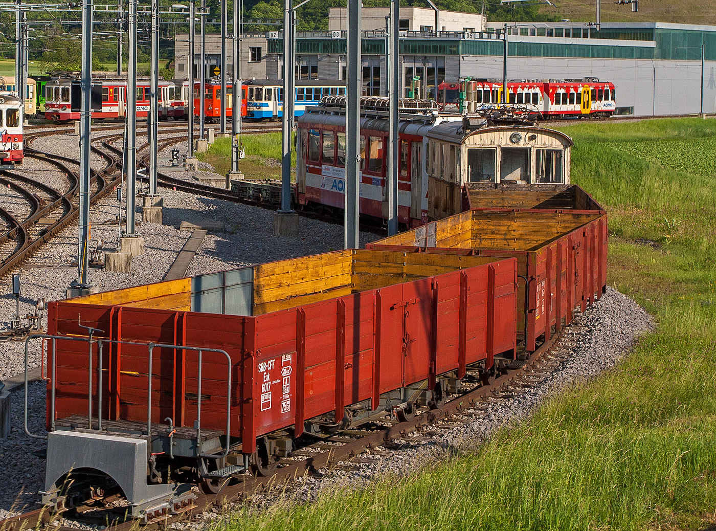 Drei ehemalige SBB Brünig meterspurige Holzwand Hochbord Güterwagen vorne der Eak 6017, dahinter der Eak 6016 und ein weiterer, sie wurden 2008 an die tpc verkauft, am 28 Mai 2012 im Dépôt der tpc -Transports Publics du Chablais in Châlex (bei Aigle), aus einem Zug heraus aufgenommen. 

Die Wagen sind hier noch im originalen Zustand der SBB Brünig, später wurden die Wagen umgebaut.

Hinter den Wagen steht noch die He 2/2 12 (Baujahr1915 von SLM/MFO), leider 2020 abgebrochen.

TECHNISCHE DATEN bei SBB: 
Spurweite:	1.000 mm (Meterspur)
Länge über Kupplung: 9.840 mm
Länge der Ladefläche: 8.500 mm
Ladefläche: 20,4 m²
Eigengewicht: 8.300 kg
Max. Zuladung: 19,0 t ab Streckenklasse A	
Höchstgeschwindigkeit: 75 km/h 
Zulassung (bei SBB): SBB und LSE
