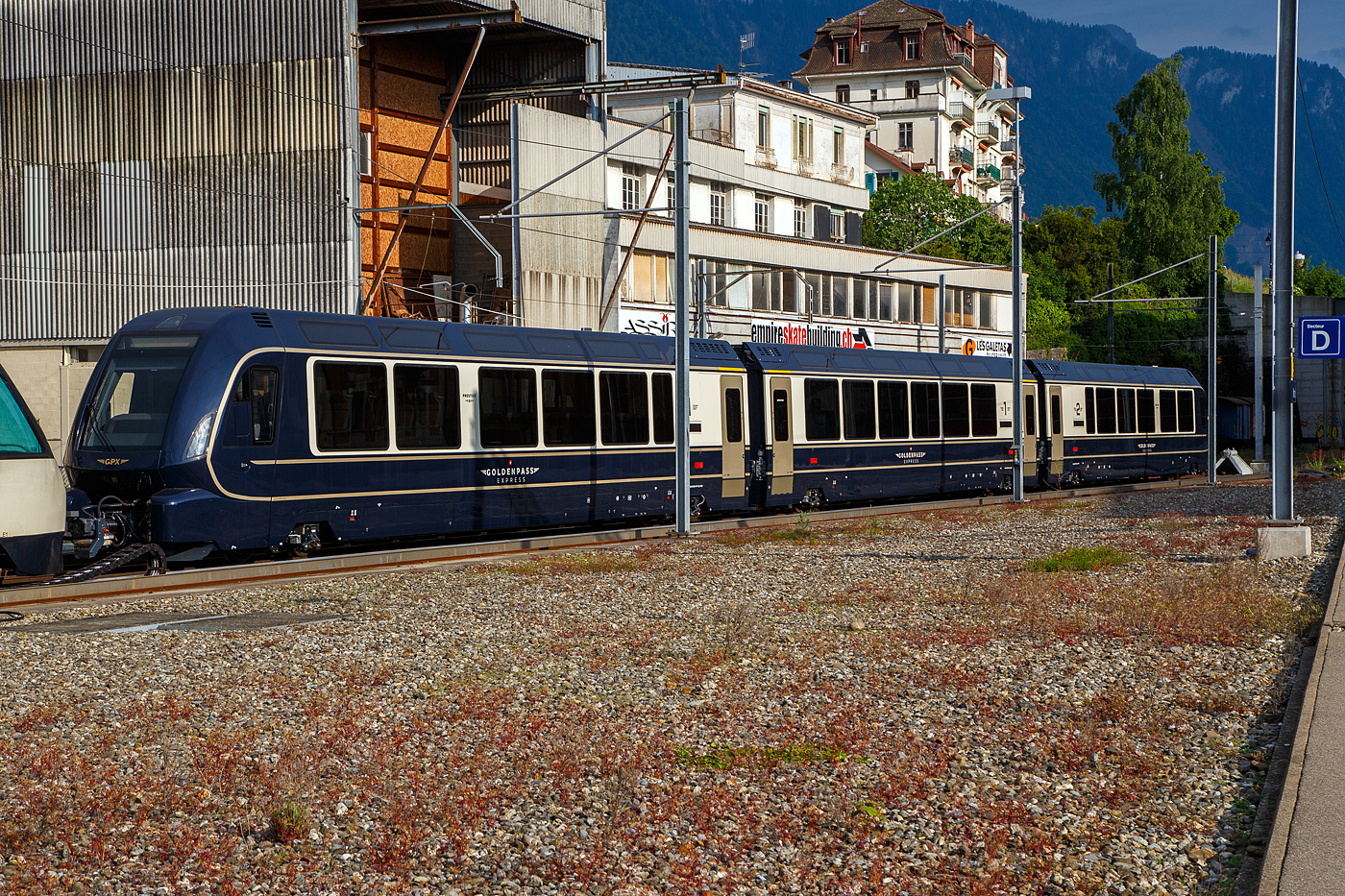 Drei MOB GPX - GoldenPass Express (Stadler GPX-Wagen mit variablem Drehgestell der Montreux-Berner Oberland-Bahn AG) abgestellt am 26. Mai 2023 beim Bahnhof Montreux. Die Wagen sind hier (von links nach rechts) der Premium-/1.Klasse Steuerwagen Ast 183 (96 85 8300 183-7 CH-MOB), der 1.Klasse Wagen As 193 (96 85 8300 193-4 CH-MOB) und der Premium-/2.Klasse Steuerwagen ABst 383 (96 85 8300 383-x CH-MOB).

Speziell am Zug ist auch dass er drei Reiseklassen hat. Wie in der Schweiz �blich verf�gt er eine 2. und 1. Klasse. Dazu kommt eine Premiumklasse mit verstellbaren und drehbaren Sitzen und gro�en Fenstern. Die Premiumklasse ist mit einer Reservierungsgeb�hr von 35 Franken und einem 1.-Klasse-Billet zug�nglich. In der Premium- und der 1. Klasse werden die Reisenden direkt am Platz gastronomisch bedient. 

Ab dem 11.Dezember 2022 wurde mit diesen Wagen der GPX - GoldenPass Express dieser fuhr von Montreux ohne Umsteigen mit Umspuren in Zweisimmen durch bis Interlaken. Daf�r wurde, im Zusammenhang mit dem Umbau des Bahnhofes Zweisimmen zwischen 2015 bis 2017, eine Umspuranlage gebaut. Ende Februar 2023 wurden erh�hte Abnutzungen an den Herzst�cken der Normalspur-Weichen auf der Strecke Zweisimmen–Interlaken Ost festgestellt. Bis zur Ermittlung der Ursache und erfolgreicher Nachbesserung verkehrt auf diesem Abschnitt ein Ersatzzug der BLS. Seit Sonntag, dem 11. Juni, f�hrt der GoldenPass Express wieder einmal pro Tag ohne Unterbrechung von Montreux nach Interlaken und zur�ck. Gleichzeitig wurden am 11. Juni drei zus�tzliche Verbindungen zwischen Montreux und Interlaken eingef�hrt. F�r diese Verbindungen wird der GoldenPass Express zun�chst nur zwischen Montreux und Zweisimmen verkehren und diese Passagiere m�ssen in Zweisimmen umsteigen. F�r diese Z�ge werden die Direktverbindungen (Montreux - Interlaken) im Laufe des Monats Juli schrittweise hinzugef�gt, vermutlich liegt dies noch an der Nachbesserung der Wagen.

Auf Meterspur wird der GPX mit einer Ge 4/4 8001–8004 bef�rdert. Als Ersatz hat die MOB im Jahr 2021 die Beschaffung neuer Lokomotiven ausgeschrieben. Bei der BLS sind die Re 465 f�r die Traktion zust�ndig. F�r die BLS Re 465 wird ein sogenannter Interfacewagen Bsi 291–293 ben�tigt. Dessen Umspurf�higkeit ist nur zur �berf�hrung in die MOB-Werkst�tte Chernex notwendig, wo gr��ere Unterhaltsarbeiten durchgef�hrt werden. Auf der Lok (Re 465) zu gewanden Seite verf�gen die Interfacewagen (Bsi 291 – 293) �ber eine Schraubenkupplung mit zwei Puffern sowie einen Hilfsf�hrerstand, auf der gegen�berliegenden Seite �ber eine Schwab-Kupplung wie die anderen GPX-Wagen. Zudem erf�llen diese Wacewagen Aufgaben der Leittechnik, des Bremssystems und der Energieversorgung.

ANZAHL DER Z�GE UND WAGEN (alle mit variablem Drehgestell) und TECHNISCHE DATEN:
Drei Zugkompositionen stellen den t�glichen Fahrbetrieb sicher, eine Komposition ist in auf Reserve oder in Wartung.Die Flotte des GoldenPass Express umfasst 23 Wagen, die alle �ber Panoramafenster verf�gen und zwischen 18,75 und 19,32 m lang sind, es sind:
•	4 x Ast (181, 182, 183, 184), Prestige/1. Klasse Steuerwagen, L�nge 19.320 mm, Eigengewicht  27,0 t, Sitzpl�tze 9/20
•	4 x As (191, 192, 193, 194) , 1. Klasse Wagen, L�nge 18.750 mm, Eigengewicht  26,51 t, Sitzpl�tze 28
•	4 x Bs (271, 272, 273, 274), 2. Klasse Niederflur-Wagen, L�nge 18.750 mm, Eigengewicht  25,3 t, Sitzpl�tze 43
•	4 x Bs (281, 282, 283, 284), 2. Klasse Wagen, L�nge 19.320 mm, Eigengewicht  25,8 t, Sitzpl�tze 54
•	4 x ABst (381, 382, 383, 384) Prestige/2. Klasse Steuerwagen, Eigengewicht  27,01 t, L�nge 19.320 mm, Sitzpl�tze 9/25
•	3 x Bsi (291, 292, 293), 2. Klasse, interface Wagen (NUR auf BLS-Netz), L�nge 18.900 mm. Eigengewicht  25,11 t, Sitzpl�tze 9/25 

19 der 23 Wagen wurden zwischen September 2020 und Ende 2021 von Stadler Rail an die MOB geliefert. Die Niederflurwagen folgen im Laufe des Jahres 2023. Die MOB hat bei Alstom 58 Drehgestelle mit variabler Spurweite bestellt (d. h. zwei Drehgestelle pro Wagen und Reserve). Diese wurden ab Fr�hling 2022 schrittweise geliefert.

Die Wagen verf�gen �ber Gep�ckablagen und Skihalterungen. Die Niederflurwagen bieten Personen mit eingeschr�nkter Mobilit�t. Niederflurwagen sind mit BehiG-konformen WCs und Wickeltisch ausgestattet. Zur Einhaltung des Behindertengleichstellungsgesetzes muss der GPX �ber mindestens einen Niederflurwagen verf�gen. 

Eingesetzte Lokomotiven (alle ohne variables Drehgestell) sind:
•	MOB Ge 4/4 III Serie 8000, somit die Ge 4/4 III 8001, 8002 und 8004, diese sind 16.690 mm lang und haben ein Gewicht von 62 t.
•	BLS Re 465, diese sind 18.500 mm lang und haben ein Gewicht von 84 t. Sie verkehren immer mit einem zus. Interface-Wagen Bsi (291, 292, 293).

Die ZUSAMMENSETZUNG DER Z�GE
Zwischen Montreux und Zweisimmen (von vorne nach hinten):
Lok MOB Ge 4/4 III Serie 8000 / ABst (Prestige/2. Klasse) / Bs (2. Klasse) / Bs (2. Klasse, Niederflur) / As (1. Klasse) / Ast (Prestige/1. Klasse).
Also f�nf Wagen, gezogen von der MOB Ge 4/4 III der Serie 8000, Zugl�nge1 20 m.

Zwischen Zweisimmen und Interlaken (von vorn nach hinten):
ABst (Prestige/2. Klasse) / Bs (2. Klasse) / Bs (2. Klasse, Niederflur) / As (1. Klasse) / Ast (Prestige/1. Klasse) /  Bsi (2. Klasse, interface) / BLS-Lok Re 465.
Also sechs Wagen, geschoben von der BLS-Lok, Zugl�nge 140 m.

KAPAZIT�T DES ZUGES
Innerhalb des MOB Meterspurnetzes (Montreux – Zweisimmen) betr�gt die maximale Kapazit�t des Zuges 184 Pl�tze (18 in der Prestige-Klasse, 48 in der 1. Klasse und 118 in der 2. Klasse). Zurzeit bis zur Lieferung der Niederflurwagen Ende 2023/Anfang 2024 betr�gt die Kapazit�t des
GoldenPass Express 145 Pl�tze (z.Z. nur 79 in der 2. Klasse). Man hatte sich wohl mehr auf Zahlungskr�ftige Reisende fixiert.

Innerhalb des Normalspurnetzes (Zweisimmen – Interlaken) betr�gt die maximale Kapazit�t des Zuges 238 Pl�tze (18 in der Prestige-Klasse, 48 in der 1. Klasse und 172 in der 2. Klasse). Zurzeit bis zur Lieferung der Niederflurwagen 199 Pl�tze (nur 133 in der 2. Klasse). Der Unterschied zwischen den beiden Wagenz�ge ist darauf zur�ckzuf�hren, dass der
Interface-Wagen (2. Klasse) nur auf der BLS Normalspur f�hrt. Der Interface-Wagen stellt die Kommunikation zwischen der Stammkomposition GPX und der BLS Lok Re 465 sicher.

Der GoldenPass Express (GPX) ist in mehrfacher Hinsicht ein au�ergew�hnlicher Zug.

TECHNOLOGIE
Der Wechsel der Spurweite um +43 % (1.000 mm / 1.435 mm) und der Perronh�he (von 35 cm auf 55 cm) ist eine absolute Neuheit. Bei dem Umspuren findet auch eine H�hen�nderung um 200 mm der Wagen statt, zudem erfolgt ebenfalls eine Spannungs�nderung von 900 V Gleichstrom auf 15 kV / 16,7 Hz Wechselstrom. Eine Weltpremiere!

Warum eine Weltpremiere, auch andere Unternehmen haben ihre Z�ge mit variablen Drehgestellen ausger�stet, etwa der spanische Talgo. Das von der MOB konzipierte und von Alstom weiterentwickelte Drehgestell ist jedoch das einzige mit einer so starken Verbreiterung (von 1 m auf 1,435 m, also um +43,5 %) und einer gleichzeitigen Anhebung des Wagenkastens um 200 mm, von 350 mm auf 550 mm. Kein anderes Drehgestell mit variabler Spurweite ist dazu in der Lage. Der Wechsel
von der Meterspur zur Normalspur ist daher eine echte Weltpremiere. Das Drehgestell des GoldenPass Express �ndert die Spurweite innerhalb weniger Sekunden und mit den Fahrg�sten an Bord. Insgesamt werden einschlie�lich des Lokomotivwechsels und der entsprechenden Kontrollen acht Minuten ben�tigt.

TOURISMUS
Durch einen Direktzug steigt die Attraktivit�t von Montreux, Gstaad und Interlaken erheblich. Montreux r�ckt so n�her an die Jungfrau und Luzern heran. Von den Palmen zu den Gletschern: Der Slogan wird Realit�t. Der GoldenPass Express ist ein Bindeglied zwischen
den Sprachen, zwischen Westschweiz und Deutschschweiz, zwischen den Kulturen, zwischen Stadt und Gebirge, zwischen Seen und Bergen. Wobei mir pers�nlich das Umsteigen gar nicht so unangenehm ist.

REISEKOMFORT
Die dreist�ndige Fahrt von Montreux nach Interlaken bietet h�chsten Komfort. Die Reisenden k�nnen in allen Wagen das Panorama genie�en und zudem das gastronomische Angebot nutzen. Die Sitze in der Prestige-Klasse sind beheizt und erm�glichen es, immer in Fahrtrichtung zu reisen.

BAHNLANDSCHAFT
Dieses Projekt �berwindet die Barriere zwischen Meterspur und Normalspur. So, als w�rde man die Grenze zwischen dem Land der Bergbahnen (Meterspur) und dem Land der Schnellz�ge (Normalspur) �berschreiten. Dies er�ffnet vielversprechende Aussichten.

SCHWEIZER WIRTSCHAFT
Beim GoldenPass Express ist fast alles aus der Schweiz. Der Eckpfeiler des Systems, das Drehgestell mit variabler Spurweite, wurde in den MOB-Werkst�tten in Chernex entworfen. Anschlie�end wurde es von Alstom Schweiz weiterentwickelt, wird im Alstom/Bombardier-
Werk in Villeneuve hergestellt und soll bei RailTech, ebenfalls in Villeneuve, gewartet werden. Die Wagen stammen aus den Stadler-Werkst�tten in Bussnang (Thurgau). Die 89 Millionen Franken wurden bzw. werden also weitgehend in die Schweizer Wirtschaft investiert. Die Instandhaltung des Zuges erfolgt durch die Abteilung Rollmaterial in den MOB-Zentren Montreux, Chernex und Zweisimmen.

Die Funktionsweise	
PRINZIP DES UMSPURENS
Der Wechsel von der Meterspur zur Normalspur erfolgt dank der Kombination aus variablem Drehgestell und Umspuranlage. Die gr��te Herausforderung besteht darin, sowohl die Spurweite als auch die H�he zu �ndern. Die elektrische Spannungsdifferenz bedingt einen Wechsel der Lokomotiven.

PHASEN
1. Von Montreux aus kommt der Zug am Bahnhof Zweisimmen auf der Meterspur an. Beim Befahren der Umspuranlage mit einer Geschwindigkeit von 15 km/h richten sich Klappen auf und st�tzen den jeweiligen Wagen von unten. Vom Gewicht des Wagenkastens befreit,
verbreitert sich das Drehgestell von 1.000 mm auf 1.435 mm. Gleichzeitig hebt sich der Wagenkasten von den 350 mm eines Meterspurperrons auf die 550 mm eines Normalspurperrons.

2. Die �nderung von Spurweite und H�he ist jedoch nicht die einzige H�rde. Zwischen dem MOB- und dem BLS-Netz besteht n�mlich eine elektrische Spannungsdifferenz von 900 Volt (Gleichstrom) auf dem Meterspurnetz der MOB und 15 kV / 16,7 Hz (Wechselstrom) auf dem Normalspurnetz der BLS. Dies erfordert einen Wechsel der Lokomotiven. Sie besitzen keine variablen Drehgestelle. So �bergibt in Zweisimmen die MOB-Lok die Wagenkolonne an die BLS-Lok.

3. Die Wagenkolonne kann dann auf der Normalspur nach Interlaken Ost weiterfahren. Das Umspuren dauert acht Minuten, einige Sekunden f�r das Befahren der Umspuranlage, die Restzeit f�r den Lokomotivwechsel und die notwendigen Kontrollen. In Zweisimmen befinden sich die Umspuranlagen an den Gleisen 6 und 7.

FAHRKARTEN PREISE
2023 betr�gt der Preis (Erwachsenen-Volltarif, Einzelfahrt) f�r die Strecke Montreux –Interlaken 73 Franken (davon  20 Franken Reservierungsgeb�hr) in der 2. Klasse und 113 Franken (davon  20 Franken Reservierungsgeb�hr) in der 1. Klasse. Eine Reservierung wird f�r die 1. und 2. Klasse dringend empfohlen und ist bei der Prestige-
Klasse (35 Franken) obligatorisch.

Da der GoldenPass Express auch den regionalen Personenverkehr (RPV) sicherstellt, werden die Fahrausweise des Schweizer Sortiments wie Generalabonnements, Halbtax und Tageskarten anerkannt und akzeptiert.

BETRIEBSWEISE
Der GPX wird nach dem Grundsatz des Linienmanagements betrieben. Das hei�t, die MOB betreibt den Zug innerhalb ihres Netzes und die BLS tut dasselbe zwischen Zweisimmen und Interlaken. 

WARUM einen Wagen mehr auf dem BLS-Netz?
Dies ist dem Lokomotivwechsel in Zweisimmen geschuldet. Hierf�r gibt es zwei Gr�nde:
1. Die elektrische Spannung des MOB-Netzes entspricht nicht der Spannung des BLS-Netzes.
2. Die Loks besitzen kein Drehgestell mit variabler Spurweite.
Die Kupplungen und Puffer des Rollmaterials des GoldenPass Express sind jedoch mit denen der BLS-Lok nicht identisch. Um die beiden Fahrzeuge miteinander zu verbinden, braucht man daher einen zus�tzlichen Wagen, den Interfacewagen (Bsi). Aus diesem Grund gibt es auf der Strecke Zweisimmen – Interlaken – Zweisimmen einen Wagen mehr.

Quelle: gpx.swiss (MOB – Goldenpass)
