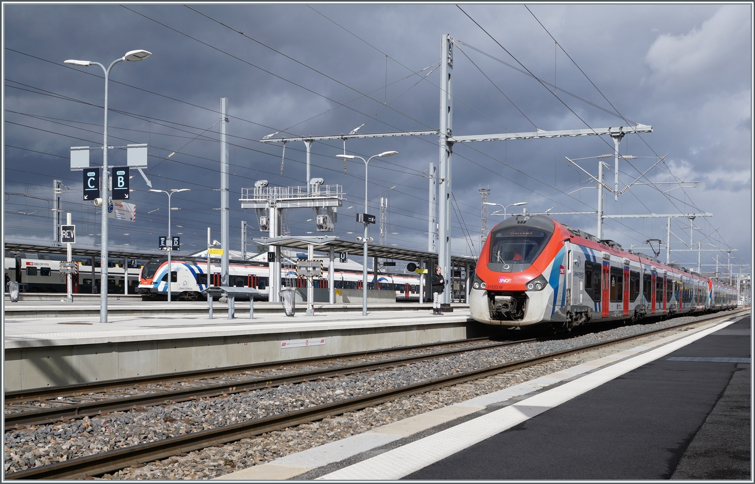 Dunkle Wolken bilden ein eindrücklichen Hintergrund der sonnenbeschienen Szene in Annemasse mit dem SNCF Z 31533 (Coradia Polyvalent régional tricourant) nach Bellegarde und im Hintergrund eines SBB LEX RABe 522  Léman Express   

10. März 2023