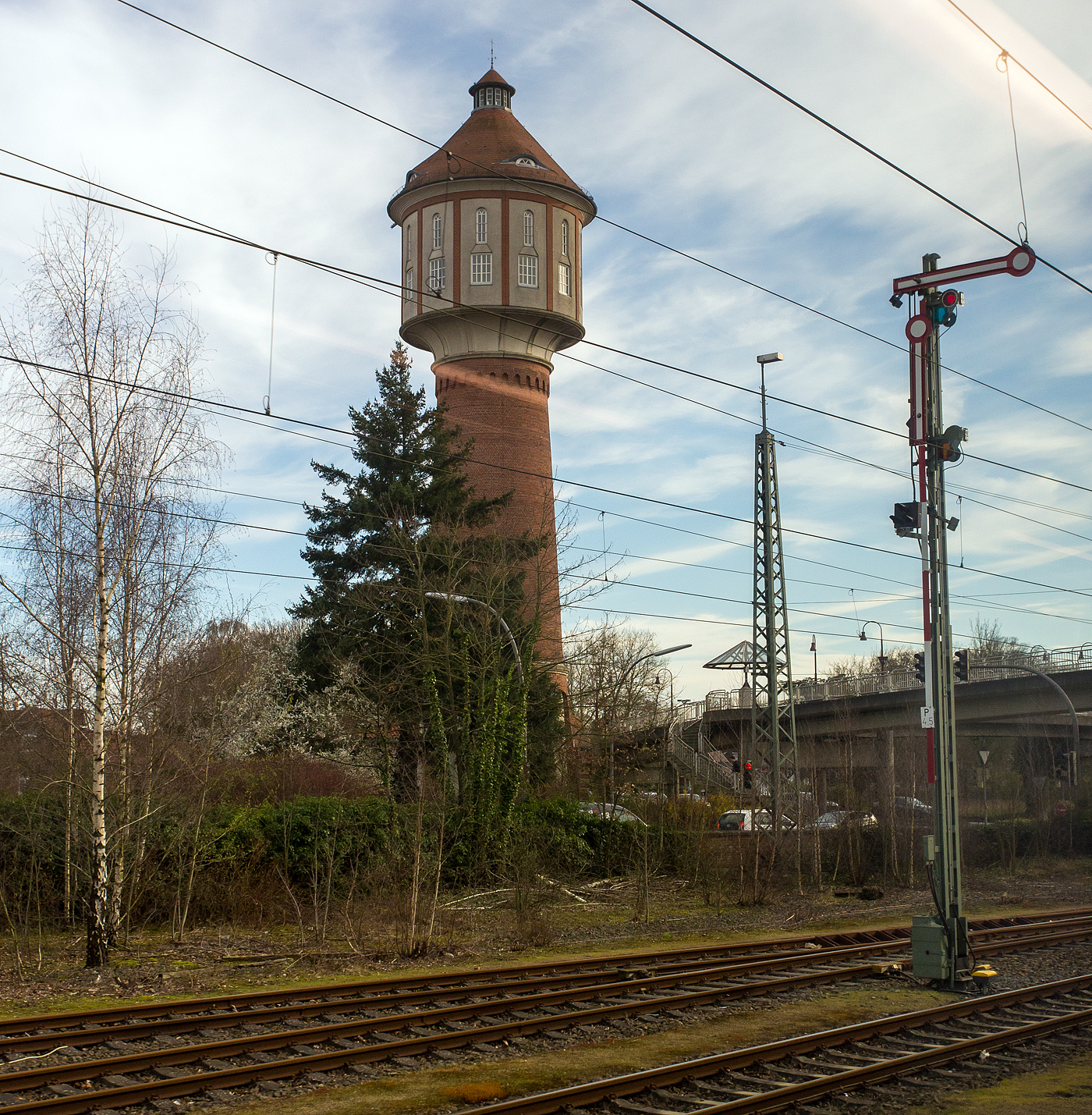 Ein Blick aus dem Zug im Bahnhof Lingen (Ems) am 14 M�rz 2024 auf den St�dtischen Wasserturm in der N�he des ehemaligen Ausbesserungswerks.

Der Wasserturm wurde 1909 im Rahmen der Errichtung einer zentralen Wasserversorgungsanlage gebaut und ist genau 42,60 Meter hoch. Der Wasserturm sicherte die Versorgung der Stadt bis 1984, 1986 wurde das Turmbauwerk in Anlehnung an die fr�here Gestaltung umfassend restauriert. Einmal im Jahr werden die T�ren des Wasserturms f�r eine Besichtigung f�r alle Interessierten ge�ffnet.