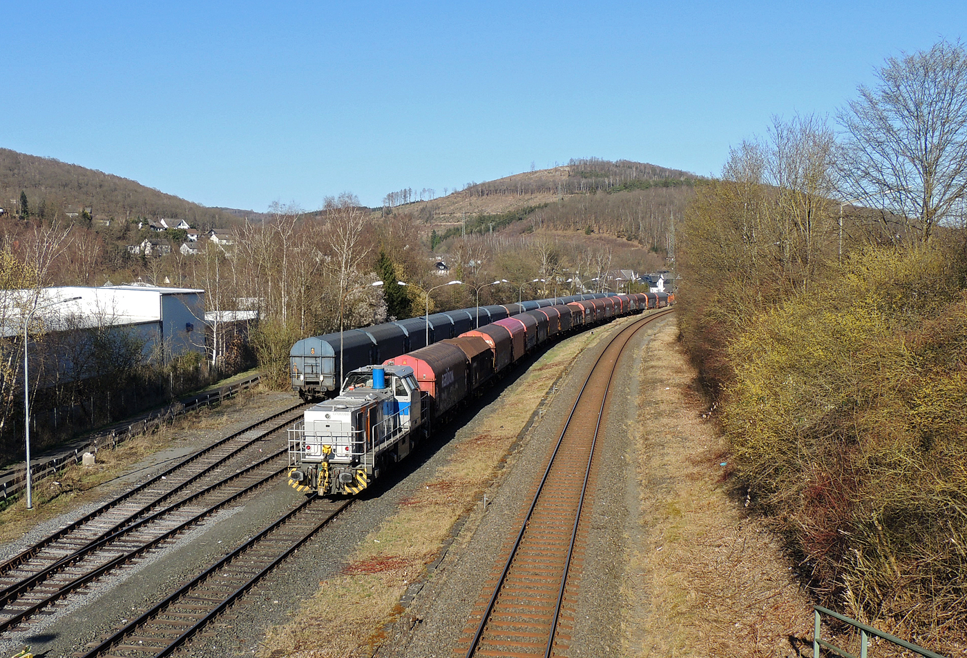 Ein Coilzug im Sandwich zweier Vossloh G 1000 BB der KSW (Kreisbahn Siegen-Wittgenstein), vorne (im Bild ganz hinten) die KSW 44 (92 80 1271 004-4 D-KSW) und am Zugschluss die KSW 47 (92 80 1271 027-5 D-KSW), ex HFM D 2, haben am 27 März 2025 Herdorf erreicht. Nun fahren sie auf den KSW-Rangierbahnhof in Herdorf, Betriebsstätte FGE -Freien Grunder Eisenbahn. Von dort fährt die KSW 44 mit einem Großteil des Zuges gleich weiter zum Pfannenberg in Neunkirchen-Salchendorf.