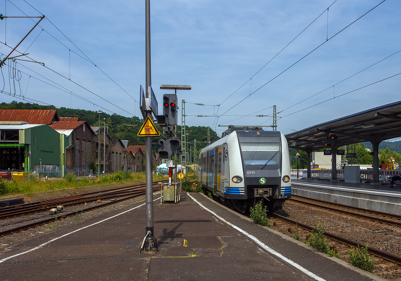 Ein ET 423 der S-Bahn Stuttgart im neuen Redesign auf Abwegen….
Der vierteilige Elektrotriebzug 94 80 0423 511-5 D-DB / 433 511-3 / 433 011-4 / 423 011-6 ein „Kurzzug“ der Baureihe 423 (1. Bauserie) der S-Bahn Stuttgart fährt am 18. Juni 2025, auf Werkstattfahrt, durch den Bahnhof Betzdorf/Sieg in Richtung Siegen. Vermutlich ging es wieder zurück nach Stuttgart.

Die Triebzüge der Baureihe 423/433 sind S-Bahn-Triebzüge, die seit 1998 den Vorgänger DB-Baureihe 420 ablösen. Die Fahrzeuge wurden ursprünglich für die S-Bahn München konzipiert, kommen aber auch bei der S-Bahn Köln, der S-Bahn Stuttgart und der S-Bahn Rhein-Main zum Einsatz. Mit Baureihe 423 werden die beiden angetriebenen Endwagen bezeichnet, während die ebenfalls angetriebenen Mittelwagen in die Baureihe 433 eingeordnet werden. Gebaut wurden die Triebzüge von einem Konsortium bestehend aus Adtranz, Alstom LHB, ABB und Bombardier. Dieser Triebzug wurde 1999 von Alstom LHB in Salzgitter-Watenstedt unter den Fabriknummern 423.0-017, 433.0-017, 433.5-017 und 423.5-017 gebaut.

Die Baureihe wurde in fünf Bauserien gebaut und geliefert:
    1. Bauserie: 423 001 – 423 190
    2. Bauserie: 423 191 – 423 300
    3. Bauserie: 423 301 – 423 371
    4. Bauserie: 423 372 – 423 396
    5. Bauserie: 423 397 – 423 462

Die vierteiligen Triebzüge der Baureihe 423 sind 67,40 Meter lang, sie laufen auf zwei Endtriebdrehgestellen und drei Jakobs-Drehgestellen (2 als Trieb- und in der Mitte ein al Laufdrehgestell. Der Triebzug ist für den S-Bahn-Betrieb konzipiert und besitzt daher kein WC. Als Leichtbaufahrzeug besteht er größtenteils aus Aluminium. Als Antrieb wird hier Drehstromtechnik mit Bremsstromrückspeisung eingesetzt, die Leistung beträgt 2.350 Kilowatt. Die zulässige Höchstgeschwindigkeit des Triebzugs beträgt 140 km/h.

Ein „Kurzzug“ der Baureihe 423 besteht dabei aus vier Wagen:
Endtriebwagen (ETW) 1: 423 001 – 462
Mitteltriebwagen (MTW) 2: 433 001 – 462
Mitteltriebwagen (MTW) 3: 433 501 – 962
Endtriebwagen (ETW) 4: 423 501 – 962

Die Ordnungsnummern der einzelnen Wagen beruhen dabei im Lieferzustand stets auf dem gleichen Schema, die vorderen beiden Wagen haben die gleiche Ordnungsnummer, während die hinteren beiden Wagen die um 500 erhöhte Ordnungsnummer tragen.

Zwei Kurzzüge bilden einen „Vollzug“, drei Kurzzüge bilden einen „Langzug“.

Die Triebzüge werden von acht vierpoligen, wassergekühlten Drehstrom-Asynchron-Fahrmotoren mit einer Gesamtleistung von 2.350 Kilowatt angetrieben. Die beiden Traktionsanlagen der Züge, die über einen gemeinsamen Stromabnehmer mit Energie versorgt werden, sind weitgehend voneinander unabhängig.

Die Züge verfügen über eine Notbremsüberbrückung. Betriebsbremsungen erfolgen über elektrodynamische Bremsen. Von den 16 Bremszylindern der elektropneumatischen Bremse sind sechs mit einem Federspeicher ausgerüstet.

Das mittlere der fünf Drehgestelle ist aus Laufdrehgestell ausgeführt (antriebslos) dieses hat auch keine Bremsen. 

TECHNISCHE DATEN:
Gebaute Einheiten: 462
Spurweite: 1.435 mm (Normalspur)
Achsformel: Bo’(Bo’) (2’) (Bo’) Bo’ (in Klammern Jakobs-Drehgestellen)
Länge über Kupplung: 67.400 mm 
Drehzapfenabstände: 15.140 mm (Endwagen) / 15.460 mm (Mittelwagen)
Achsabstand im End-Drehgestell: 	2.200 mm 
Achsabstand im Jakobs-Drehgestell: 2.700 mm
Treib- und Laufraddurchmesser: 850 mm (neu) / 780 mm (abgenutzt)
Leergewicht: 105,1 t
Höchstgeschwindigkeit: 140 km/h 
Leistung: 8 x 293,75 = 2.350 kW
Beschleunigung: 1,0 m/s²
Bremsverzögerung: 0,9 m/s²
Motorentyp: Drehstrom-Asynchron  vom Typ 	4 WIA 3558 G
Anzahl der Fahrmotoren: 8
Kupplungstyp: Scharfenbergkupplung Typ 10
Sitzplätze: 192
Fußbodenhöhe: 1.025 mm (Einstiegshöhe von 995 mm)