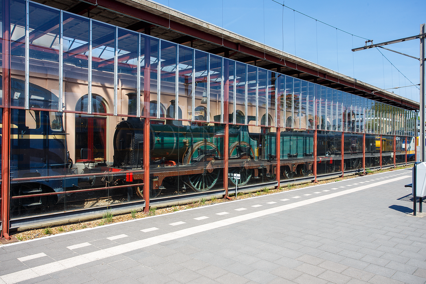 Ein etwas anderes Bild von der  1881 gebauten 1B Dampflokomotive SS 326 „Grote Groenen“ (Große Grüne), ab 1921 NS 1326 (NS-Baureihe 1300), am 29 April 2025 im Het Spoorwegmuseum (bis 2005 NSM - Nederlands Spoorwegmuseum / Niederländischen Eisenbahnmuseum) in Utrecht im ehemaligen Bahnhof Maliebaanstation.   

Die Dampflok wurde 1881 von Beyer Peacock & Co. Ltd. in Manchester (GB) unter der Fabriknummer 2101 gebaut und an die damalige SS - Maatschappij tot Exploitatie van Staatsspoorwegen (deutsch: Gesellschaft zum Betrieb von Staatseisenbahnen) geliefert. Ab 1921, nach der Zusammenlegung des Rollmaterials der SS und der NRS, wurde die Lok zur NS 1326. Die Lokomotive 1326 wurde 1939 außer Dienst gestellt und für das Eisenbahnmuseum erhalten. Am Ende des Zweiten Weltkriegs wurde sie von den zurückweichenden Deutschen Truppen in Maastricht schwer beschädigt. Im Jahr 1956 wurde sie schließlich von der Hauptwerkstatt in Tilburg in ihren Originalzustand zurückversetzt und anschließend ins Eisenbahnmuseum gebracht. Die Lokomotive 326 gilt als eines der Meisterwerke des Museums.

Die NS 1300-Serie war eine Serie von 179 Dampflokomotiven der Niederländischen Eisenbahnen (NS), die zwischen 1880 und 1895, an ihre Vorgängergesellschaften, Maatschappij tot Exploitatie van Staatsspoorwegen (SS) und Noord-Brabantsch-Duitsche Spoorweg-Maatschappij (NBDS) geliefert wurden.
