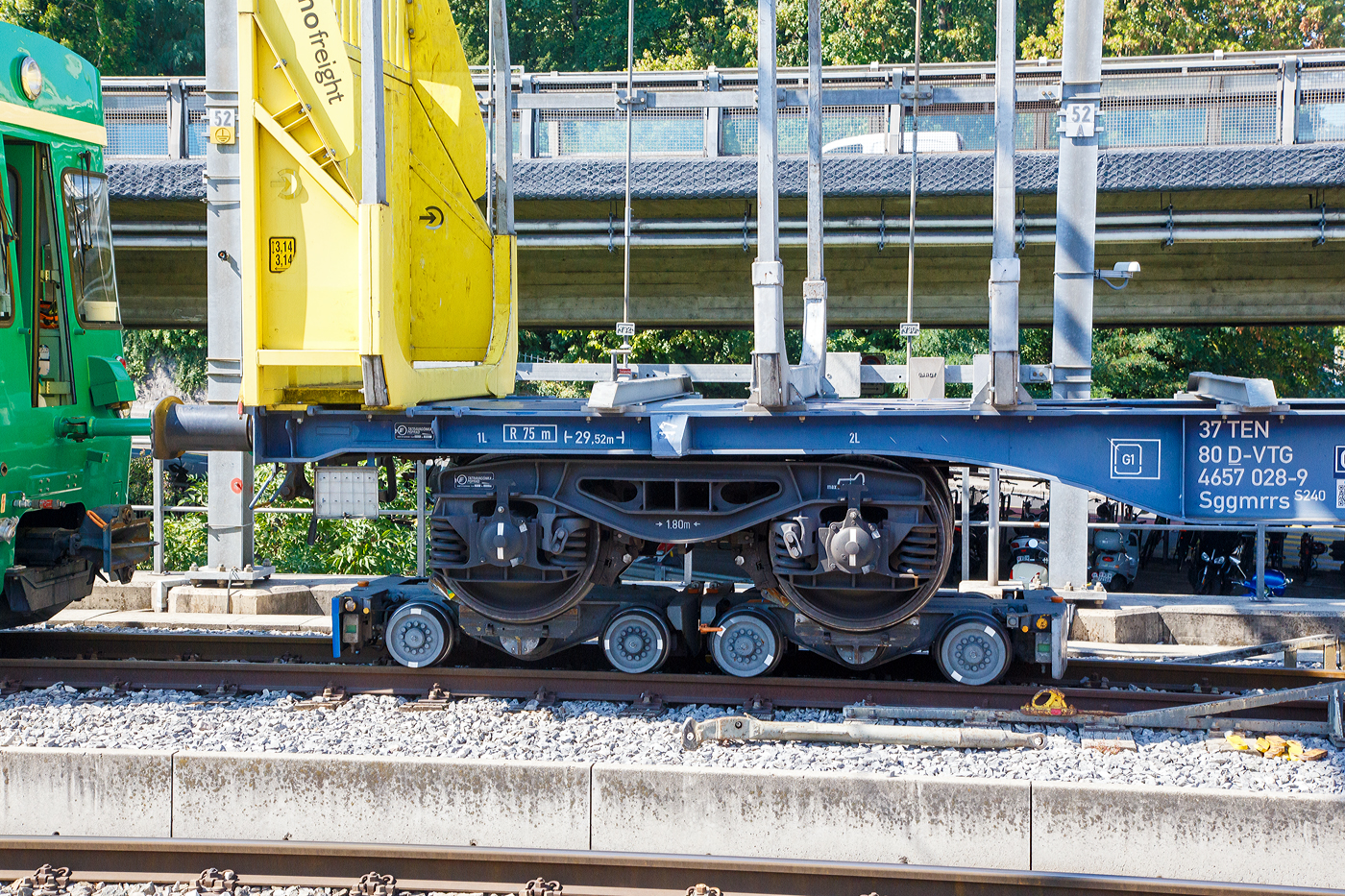 Ein normalspuriges Drehgestell des leeren 2 x vierachsiger Flachwagen in Sonderbauart (INNOFREIGHT Holz-Doppelwagen), 37 80 4657 028-9 D-VTG, der Gattung Sggmrrs S240, verladen auf zwei schmalspurige Rollböcke Ua 2xx vom Typ Vevey, am 07 September 2023 an einer Rollbockgrube beim Bahnhof Morges.

Die Rollböcke dienen zum Transport von Normalspurwagen (meist Güterwagen) auf Schmalspurgleisen (wie hier 1.000 mm). Ein Rollbock ist 1,65 t schwer und trägt jeweils eine Normalspur-Wagonachse mit einer maximalen Achslast von 22,5 t. Bei z.B. einem vierachsigen Drehgestell Wagen kommen so vier Rollböcke zum Einsatz, wobei der Wagen somit bis zu 90 t schwer sein kann.

TECHNISCHE DATEN:
Spurweite: 1.000 mm
Achsanzahl: 2
Eigengewicht: 1,65 t
Traglast: 22,5 t 

Ein Rollbock ist ein meist zweiachsiges Schienenfahrzeug (Wagen), mit dem ein andersspuriges Eisenbahnfahrzeug auf der Spurweite des Rollbocks befördert werden kann. In Süddeutschland wird er auch als Rollschemel bezeichnet, nicht aber in der Schweiz, wo dieses Wort einen Rollwagen bezeichnet. Entwickelt wurde der Rollbock 1881 von Paul Langbein (1842–1908).

Funktion:
Durch den Einsatz von Rollböcken entfällt im Güterverkehr das Umladen der Güter in Fahrzeuge der anderen Spurweite. Das Aufbocken von Personenwagen war nicht üblich, da die Reisenden selbst relativ leicht die Fahrzeuge wechseln konnten und das Kipp-Risiko bei Personenbeförderung nicht akzeptabel war. Zu besonderen Anlässen wurden aber Spezialwagen verladen, beispielsweise Salon- oder Kinowagen. Grundsätzlich ist anzumerken, dass es, insbesondere in Deutschland, kein zusammenhängendes Schmalspurnetz, ähnlich jenem in Normalspur, gibt oder gab. Daher war eine weitgehende Normung und Standardisierung, die bei den normalspurigen Eisenbahnen die Interoperabilität sicherstellt, nicht zwingend und fand nicht statt. Folglich kam es zu zahlreichen technischen Insellösungen, auch bei den Rollböcken. Die grundsätzliche Funktion ist aber stets dieselbe. Neben technischen Unterschieden waren daraus folgend die Vorschriften für den Betrieb verschieden, wobei die Vorschriften zum Teil die Technik beeinflussten, zum Teil aber auch in der Folge der technischen Voraussetzungen erlassen wurden.

Rollböcke werden seitens der Eisenbahnindustrie im Übrigen auch dafür eingesetzt, andersspurige Fahrzeuge über Normalspur vom Hersteller zu Testeinrichtungen oder zu ihrem Einsatzgebiet zu transportieren. So setzt die RailAdventure GmbH solche Fahrzeuge – bei ihr Loco Buggys genannt – ein.

Technik
Der Rollbock ist ein schmalspuriges Fahrzeug mit sehr kurzem Achsstand (ähnlich einem Drehgestell), auf dem die Räder jeweils eines Radsatzes des Normalspurwagens verankert werden. Beladen wird der Rollbock von einer speziellen Rollbockgrube aus. Abhängig von der konkreten Ausgestaltung der Rollböcke konnten auch dreiachsige Wagen aufgebockt werden. 

Güterwagen auf Rollböcken (oder Rollwagen) können zu ganzen Güterzügen zusammengestellt werden. Je nach örtlicher Betriebsvorschrift konnten schmalspurige Personenwagen in die Züge eingereiht werden, häufig waren die Reihungsfolgen reglementiert. Zum Teil waren bzw. sind die Rollböcke mit dem jeweiligen Bremssystem (Druckluft, Saugluft) oder Heberleinbremse der Schmalspurbahn ausgerüstet, es gab aber auch ungebremste Rollböcke. Einige Bahnen stellten in diesem Fall so genannte Bremswagen in die Züge ein, die ballastiert waren, um größeres Bremsvermögen zu besitzen. Teilweise wurden die Bremsleitungen der Normalspurwagen mitverwendet und die Rollbockbremsen über T-Stücke an diese angeschlossen. Normalspurwagen auf Rollböcken werden entweder direkt miteinander gekuppelt oder die Rollböcke mittels Kuppelstangen verbunden. Bei der direkten Kupplung sind diese „lang zu machen“, das heißt, nicht straff anzuziehen, da die Puffer die Wagen in den häufig engen Radien sonst von den Rollböcken drücken würden. Die Verbindung mit dem Zugfahrzeug kann ebenfalls über Kuppelstangen erfolgen. Es gibt aber auch die Möglichkeit, so genannte Pufferwagen zu verwenden. Diese schmalspurigen Wagen besitzen Zug- und Stoßvorrichtungen, die in Ausführung und Höhe zu jenen der aufgebockten Normalspurwagen passen und somit als Adapter dienen. Es wurden auch Lokomotiven mit solchen angepassten Normalspur-Zug-und-Stoßvorrichtungen verwendet.

Rollböcke nach dem System Vevey
Um den beim System Langbein personal- und zeitaufwändigen Verladevorgang zu vereinfachen, entwickelte die schweizerische Bahngesellschaft YSteC 1974 ein neues Prinzip. Hierbei wird die Achse des Normalspurwagens nicht mehr fixiert. Der Wagen steht mit seinen Rädern in speziell geformten Mulden. Derartige Rollböcke, als System „Vevey“ von den Ateliers de constructions mécaniques de Vevey (ACMV) in Serie gefertigt, werden bei mehreren Bahnen in der Schweiz und einer Bahn in Deutschland (HSB) eingesetzt. Der Hauptunterschied zum klassischen Rollbock ist, dass das Aufbocken bei langsamer Fahrt automatisch geschieht. Somit sind zahlreiche Unannehmlichkeiten und Gefährdungspotenziale behoben, weswegen beispielsweise die Harzer Schmalspurbahnen ihre Rollwagen durch solcherlei Rollböcke ersetzt haben, ähnlich wie zuvor diverse Schweizer Bahnen.

Die mögliche Rationalisierung konnte aber nicht verhindern, dass der Güterverkehr auf zahlreichen Schmalspurbahnen dennoch eingestellt wurde. Rollbockanlagen im kommerziellen Betrieb gibt es nur noch in Nordhausen, Langenthal, Morges und Yverdon, die Anlage in Worblaufen dient noch Diensttransporten. In Interlaken Ost wurde 2021 eine neue Rollbockanlage erstellt.