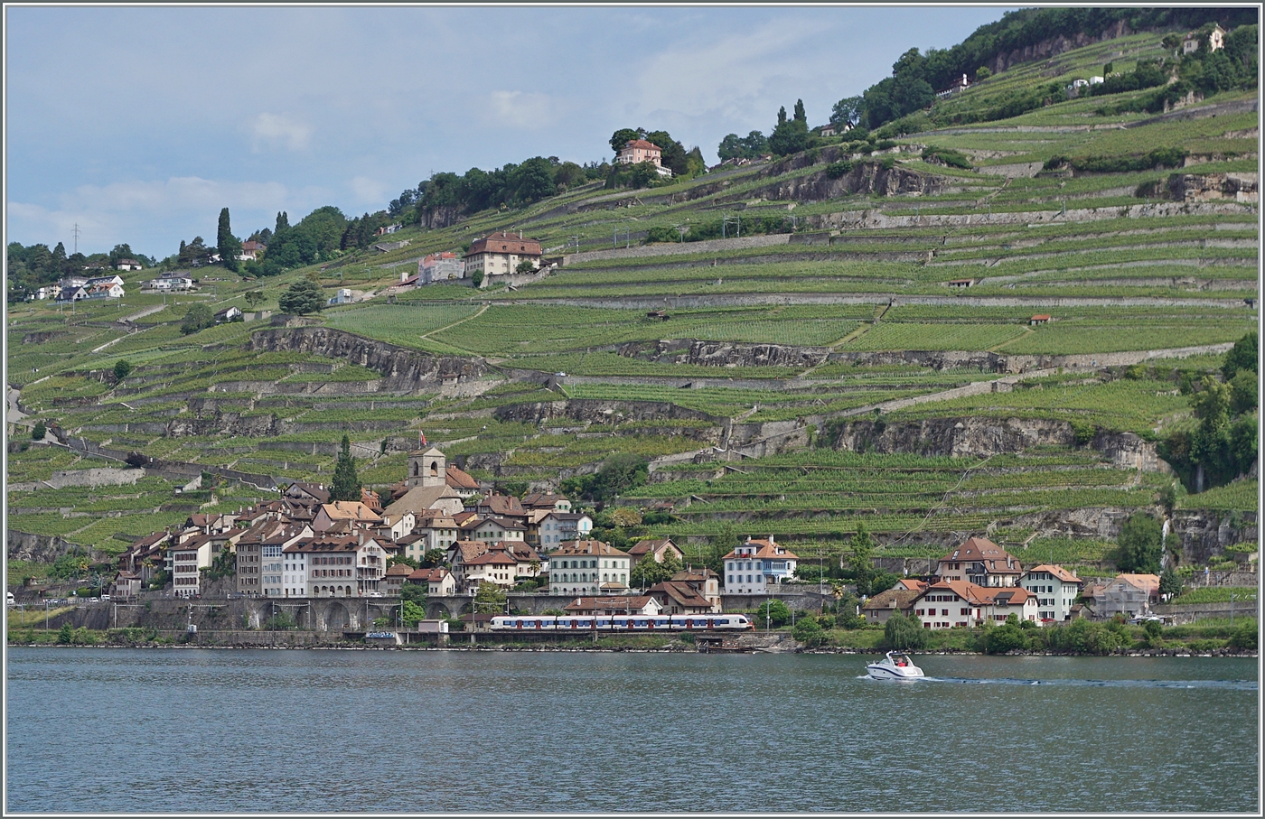 Ein paar hundert Meter östlich, aber von einer komplett anderen Position her als beim vorangegangen Bild, zeigt sich ein SBB RABe 523 523  Flirt  als R3 24324 auf dem Weg nach Vallorbe vor der Kulisse von St-Saphorin. Das Bild entstand auf dem CGN Kursschiff  La Suisse . 

31. Mai 2025