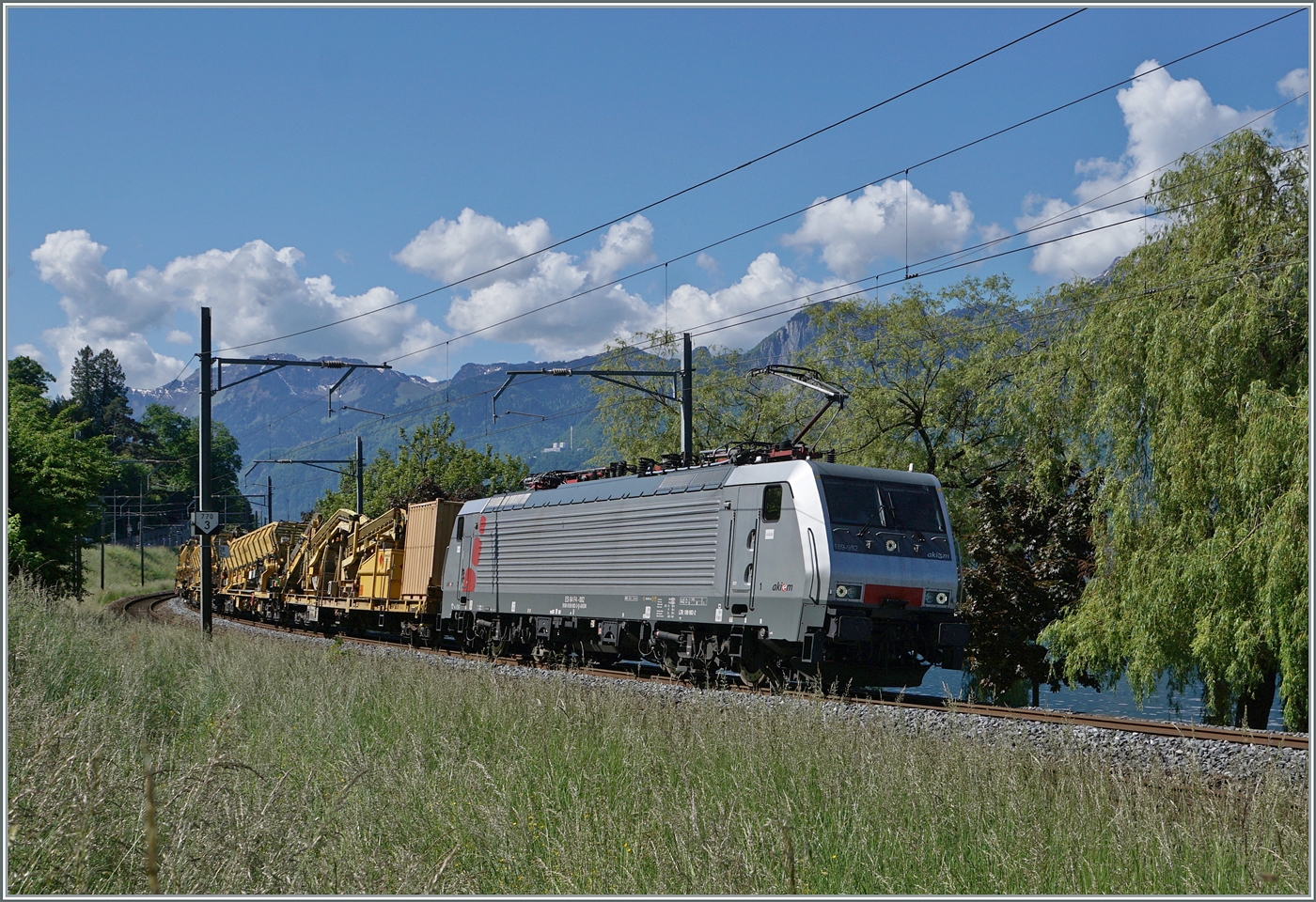 Ein sehr seltener Gast am Genfersee: die AKIEM 64 F4 082 (91 80 189 982-2 D-AKIEM) ist kurz nach Villeneuve mit einer Gleisbaumaschine auf der Fahrt in Richtung Lausanne. 14. Mai 2025