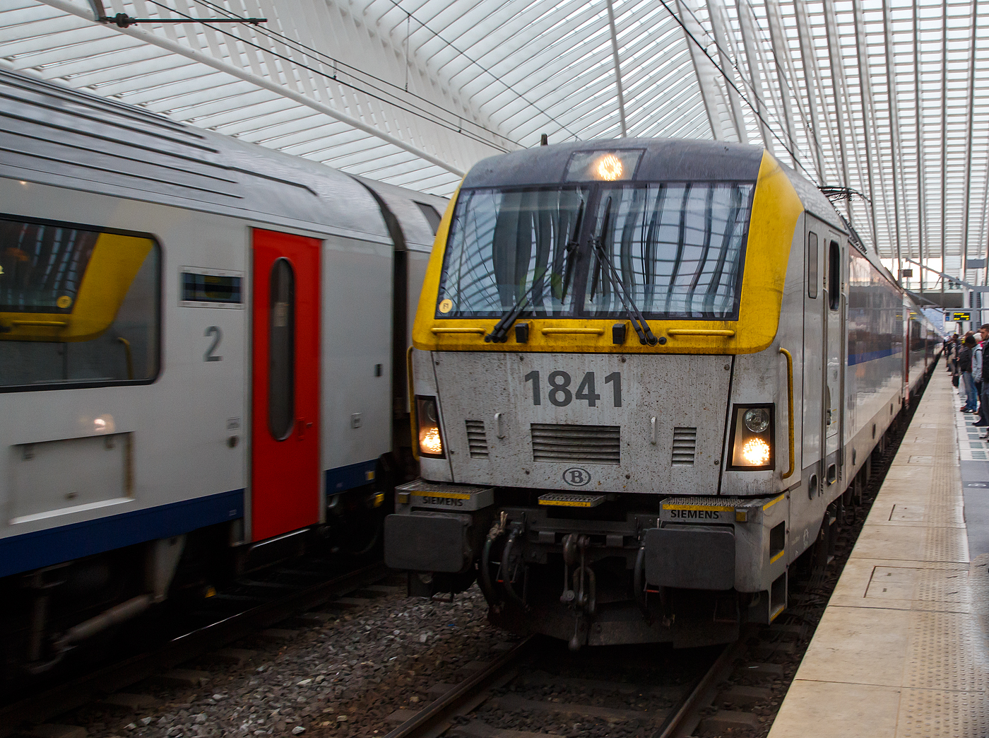 Ein Vorgänger der Siemens Vectron, die HLE 1841 eine SIEMENS EuroSprinter ES60U3 der belgischen NMBS/SNCB fährt am 03 Oktober 2015, als IC via Brüssel nach Ostende, in den Bahnhof Liège Guillemins (Lüttich-Guillemins) ein.

Die Lok wurde 2009 von Siemens in München-Allach unter der Fabriknummer 21572 gebaut und an die Nationale Gesellschaft der Belgischen Eisenbahnen geliefert.

Die SIEMENS EuroSprinter ES60U3 gehört zur Familie Siemens ES 2007, diese wird als eine überarbeitete Generation des EuroSprinters aus dem Hause Siemens Rail Systems (zuvor Siemens Mobility, vormals Siemens Transportation Systems) bezeichnet. Abgeleitet wurden sie von der Siemens ES 64 U4 Plattform, jedoch mit neuen Crash-Cabs (EN 15227). Es handelt sich dabei um den Vorgänger der erfolgreichen Fahrzeugplattform Siemens Vectron. Geliefert wurden Lokomotiven dieser Generation an die Eisenbahn von Portugal (CP) und die belgische Bahn (NMBS/SNCB).

Die belgische Staatsbahn bestellte 2006 von diesen Loks 60 Stück mit einer Leistung von 6.000 kW. 2008 erfolgte eine weitere Bestellung über weitere 60 Maschinen, das gesamte Auftragsvolumen betrug 440 Millionen Euro. Die Loks wurden dreisystemfähig für den Einsatz unter 1,5 und 3 kV Gleich- sowie 25 kV Wechselspannung ausgelegt und erhielten auch Fahrzeugeinrichtungen für die Zugbeeinflussungssysteme in Frankreich (KVB), Belgien (TBL1, TBL1+, TBL2 und Crocodile) und Luxemburg (Crocodile, ETCS Level 1). Die Typbezeichnung des Herstellers lautet entsprechend ES60U3. Es bestand eine Option auf den Einbau des niederländischen ATB-EG. Die Loks haben eine Höchstgeschwindigkeit von 200 km/h.

Mit der Reihe 18 wurde eine Baureihenbezeichnung erneut vergeben, unter der in der Vergangenheit bereits von Alstom hergestellte, inzwischen ausgemusterte Viersystemlokomotiven geführt wurden. Auf diese wurde in der Nummerierung keine Rücksicht genommen, die Zählung beginnt wie bei der Alsthom-Reihe bei 1801.

96 Loks dieses Typs wurden als Reihe 18 (1801 bis 1896) und 24 als Reihe 19 (1901 bis 1924) beschafft. Die Lokomotiven der Reihe 19 sind einseitig (an einer Front) mit automatischen Mittelpufferkupplungen für den Wendezugbetrieb mit M6-Wagen ausgerüstet, die vorher von Lokomotiven der Reihe 27 bespannt wurden und triebzugähnlich geflügelt und gestärkt werden. Die Maschinen der Reihe 18 verfügen an beiden Enden über Puffer und Schraubenkupplungen.

Lokomotiven der Reihe 18 bespannen planmäßig seit 10. Dezember 2023 den euregioAIXpress sowie den ÖBB Nightjet 424/425 zwischen Bahnhof Brüssel Süd und Aachen Hauptbahnhof, solange im Bahnhof Aachen Hbf die Fahrleitungsspannung von mehreren Bahnsteiggleisen auf 3 kV = umgeschaltet werden kann. Östlich von Aachen übernimmt dann eine Taurus-Lokomotive der ÖBB.

TECHNISCHE DATEN der NMBS/SNCB-Reihe 18/19:
Hersteller: Siemens Mobility GmbH in München-Allach
Hersteller Typenbezeichnung: ES60U3
Baujahre: 2008 bis 2012
Gebaute Anzahl: 120
Nummerierung: 1801-1896 / 1901-1924
Spurweite: 1.435 mm (Normalspur)
Umgrenzungsprofil: UIC 505-1
Achsfolge: Bo’Bo’
Länge über Puffer: 19.580 mm
Max. Breite des Lokkastens: 3.014 mm
Drehzapfenabstand: 9.900 mm 
Achsabstand im Drehgestell: 3.000 mm
Treibraddurchmesser: 1.150 mm (neu) / 1.070 mm (abgenutzt)
Dienstgewicht: 88 t 
Anzahl Fahrmotoren: 4
Antriebssystem: Kardan-Hohlwellen-Antrieb
Übersetzung: 91:27
Max. Leistung: 6.000 kW (bei AC und DC 3kV) / 2.500 kW (bei 1,5 kV DC)
Dauerleistung: 5.000 kW (bei AC und DC 3kV) / 2.400 kW (bei 1,5 kV DC)
Max. Anfahrzugkraft: 300 kN
Höchstgeschwindigkeit: 200 km/h
Netzspannungen: 25 kV AC 50 Hz, 3 kV DC und 1,5 kV DC
Kleister befahrbarer Gleisbogen: R 100 m
Kompressor Leistung: 	max. 2.400 L/min
