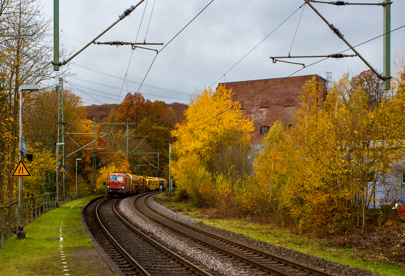 Es ist wie es ist, manchmal ist man einfach auf der falschen Gleisseite. Die 247 902 (92 80 1247 902-0 D-RTS) der RTS Rail Transport Service GmbH, Graz (eine 100%ige Tochter der Swietelsky Baugesellschaft m.b.H) fährt am 03 November 2025 mit einem P&T Schotterbewirtschaftungssystem BDS 2000-4 (eine Schotterverteilmaschine), sowie einer P&T UNIMAT 09-32/4S Dynamik (eine Universalstopfmaschine mit dynamischem Gleisstabilisator) am Haken durch Scheuerfeld/Sieg in Richtung Siegen. Beide Plasser & Theurer Maschinen gehören der Swietelsky Baugesellschaft m.b.H, wobei die BDS 2000-4 wohl in Österreich und die UNIMAT 09-32/4S in Deutschland eingesellt sind. 

Nochmals einen lieben Gruß an den netten Lokführer zurück.

Die Siemens Vectron DE wurde 2015 von Siemens Mobility GmbH in München-Allach unter der Fabriknummer 21762 als Vorführlok gebaut und eingestellt vom Siemens Prüfcenter Wegberg-Wildenrath als (92 80 1247 902-0 D-PCW). Für Testfahrten war sie bei einigen Bahnen. Ab 2017 war sie für die DB Cargo Deutschland AG (92 80 1247 902-0 D-DB) unterwegs, bis sie 2019 an die RTS - Rail Transport Service GmbH verkauft wurde. Zugelassen ist die Dieselelektrische Lok in Deutschland und Österreich, mit einer Höchstgeschwindigkeit von 160 km/h.
