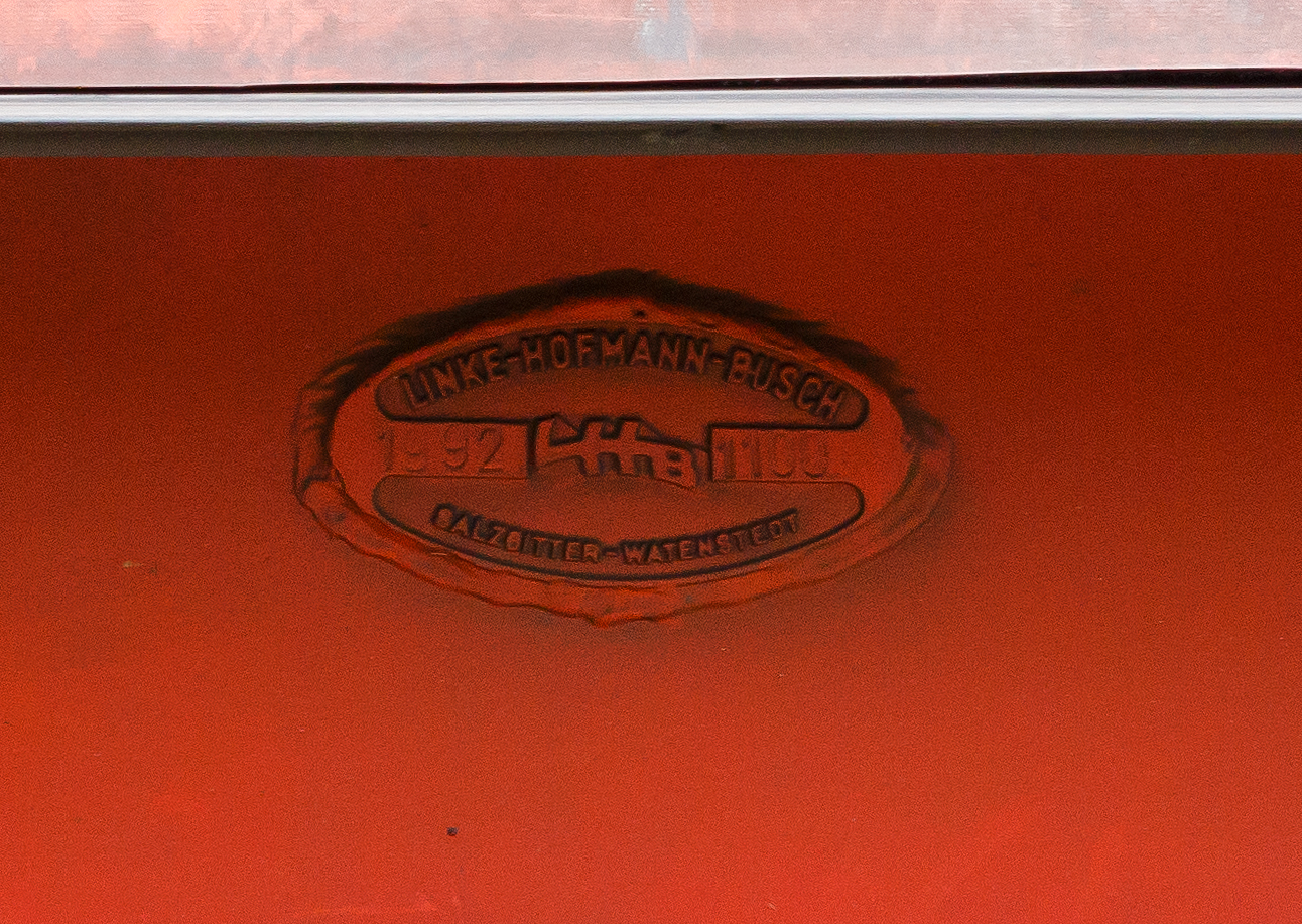 Fabrikschild LHB - Linke-Hofmann-Busch GmbH, Salzgitter-Watenstedt, 1992, Fabriknummer 1100 an dem vierachsigen Drehgestell-Flachwagen mit verschiebbarem Planenverdeck und Lademulden f�r Coil-/Spaltbandtransporte 31 80 4671 407-3 D-DB, der Gattung Shimmns-ttu 708.4, der DB Cargo AG, abgestellt im Zugverband (�bergabeg�terzug) am 26  September 2024 in Herdorf auf dem Rbf der Kreisbahn Siegen-Wittgenstein (KSW).