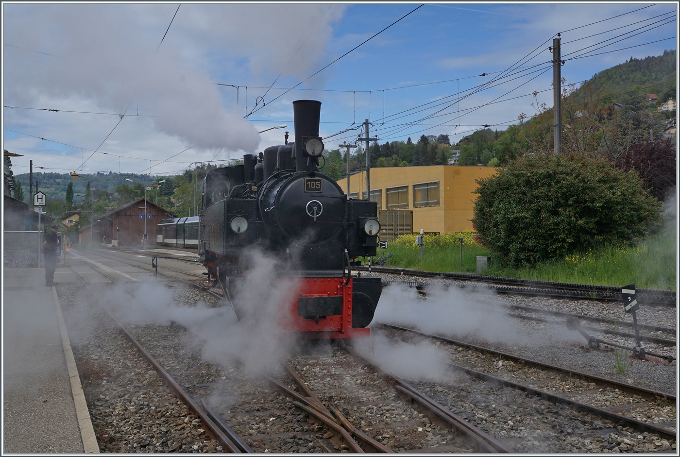 Herrlich dampft die SEG G 2x 2/2 105 der Blonay-Chamby Bahn bei ihrem Manöver in Blonay. Da der angekommene Zug mit zwei Wagen nicht zu lange ist, kann er direkt umfahren werden; (länger Züge werden zurückgestossen und rollen dann an den Bahnsteig, während die Lok auf dem Abstellgleis wartet und sich dann an die Zugspieze begibt.). 

4. März. 2024