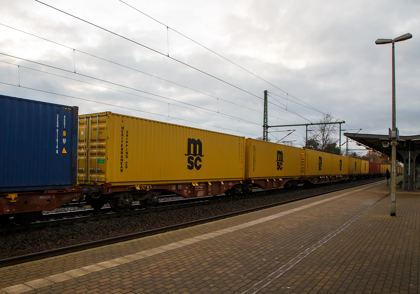 Hier sieht man den Unterschied der Gattung Sggrs (wie hier) und der Gattung Sggnss-XL (vorheriges Bild).....
6-achsiger Gelenk-Containertragwagen 33 54 4803 015-5 der Gattung Sggrs, der METRANS Rail s.r.o. (Prag / Praha), am 07.12.2022 im Zugverband, beladen mit zwei 40ft-Containern bei einer Zugdurchfahrt in Dresden-Strehlen.

Diese Wagen haben eine Länge über Puffer von 26.290 mm

Gattungs-Kennbuchstaben bedeuten:
S  -  Drehgestell-Flachwagen in Sonderbauart
gg -  Für Container mit einer Gesamtlänge von höchstens bis 80 Fuß
r  -  Gelenkwagen
ss -  Höchstgeschwindigkeit 120 km/h (beladen)
