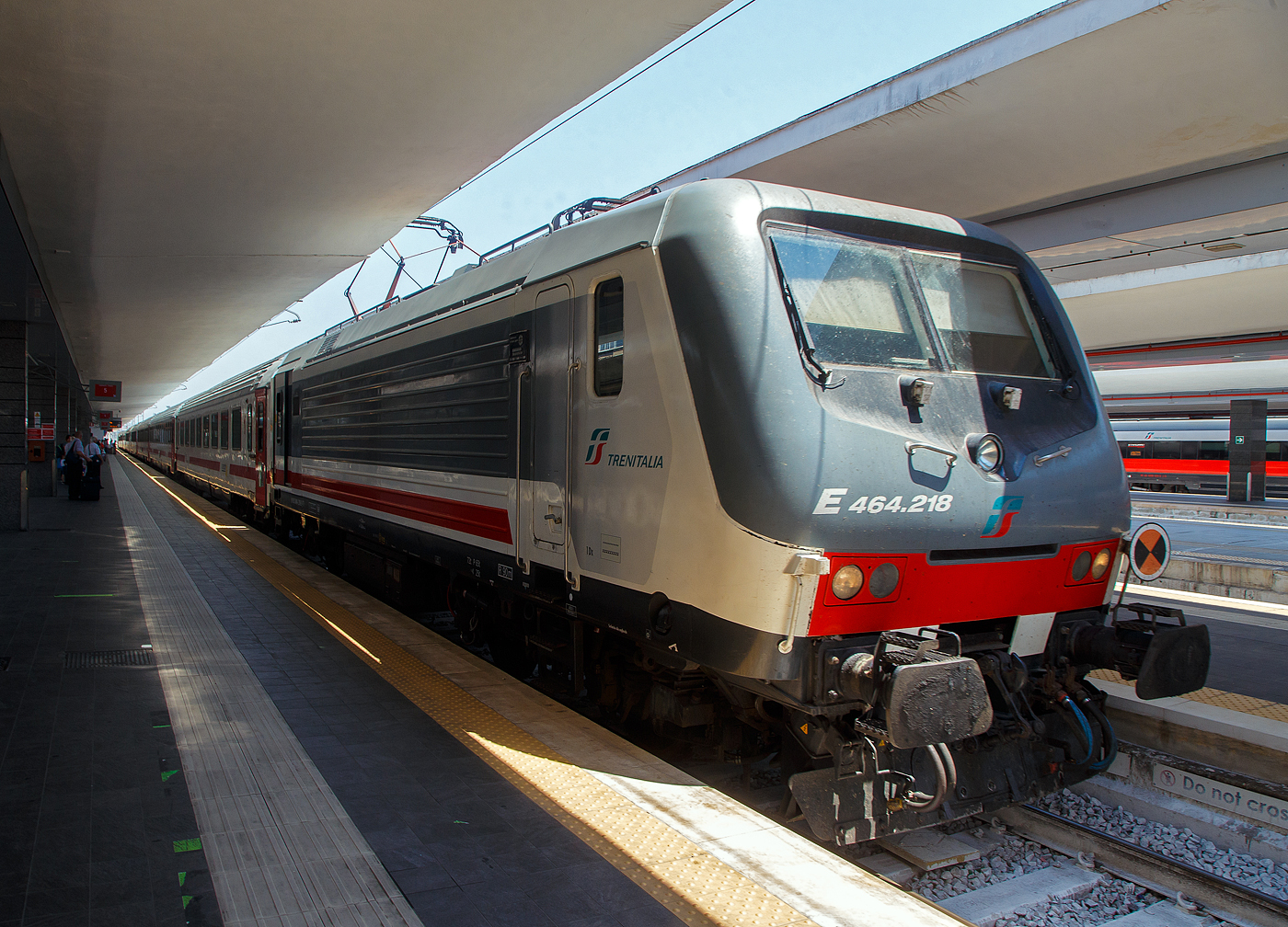 Im Sandwich zweier E.464 (geführt von der E.464.218), Steuerwagen an Steuerwagen erreicht unser Trenitalia Intercity 727 „SCILLA“ (Roma Termini - Napoli Centrale - Villa S. Giovanni - Messina Centrale - Syrakus (Siracusa) / Palermo) am 16.07.2022 den Bahnhof Napoli Centrale. 

Bis Villa S. Giovanni wird der Zug im Sandwich Steuerwagen an Steuerwagen gefahren, dann wird der Zug auf eine Eisenbahnfähre verladen und es geht über die Straße von Messina nach Sizilien. Nach der Entladung in Messina Centrale fährt der eine Zugteil weiter nach Palermo und der andere über Catania Centrale nach Syrakus (Siracusa). 
