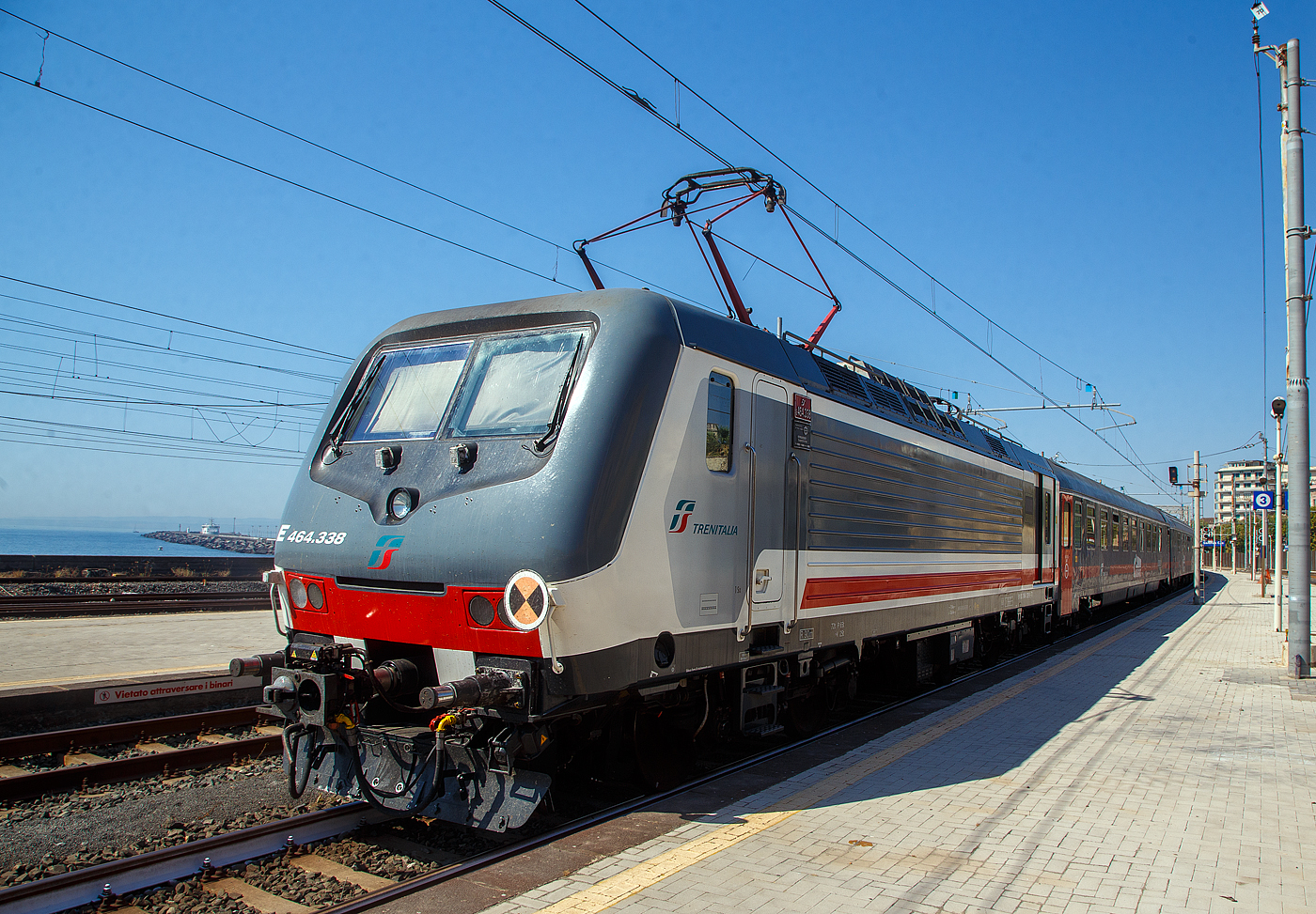 Im Sandwich zweier E.464 (geführt von der geschoben von der E.464.338) verlässt der Trenitalia InterCity Notte ICN 1959, von Roma Termini nach Syrakus (Siracusa), am 18 Juli 2022 den Bahnhof Catania Centrale und fährt weiter in Richtung Syrakus.