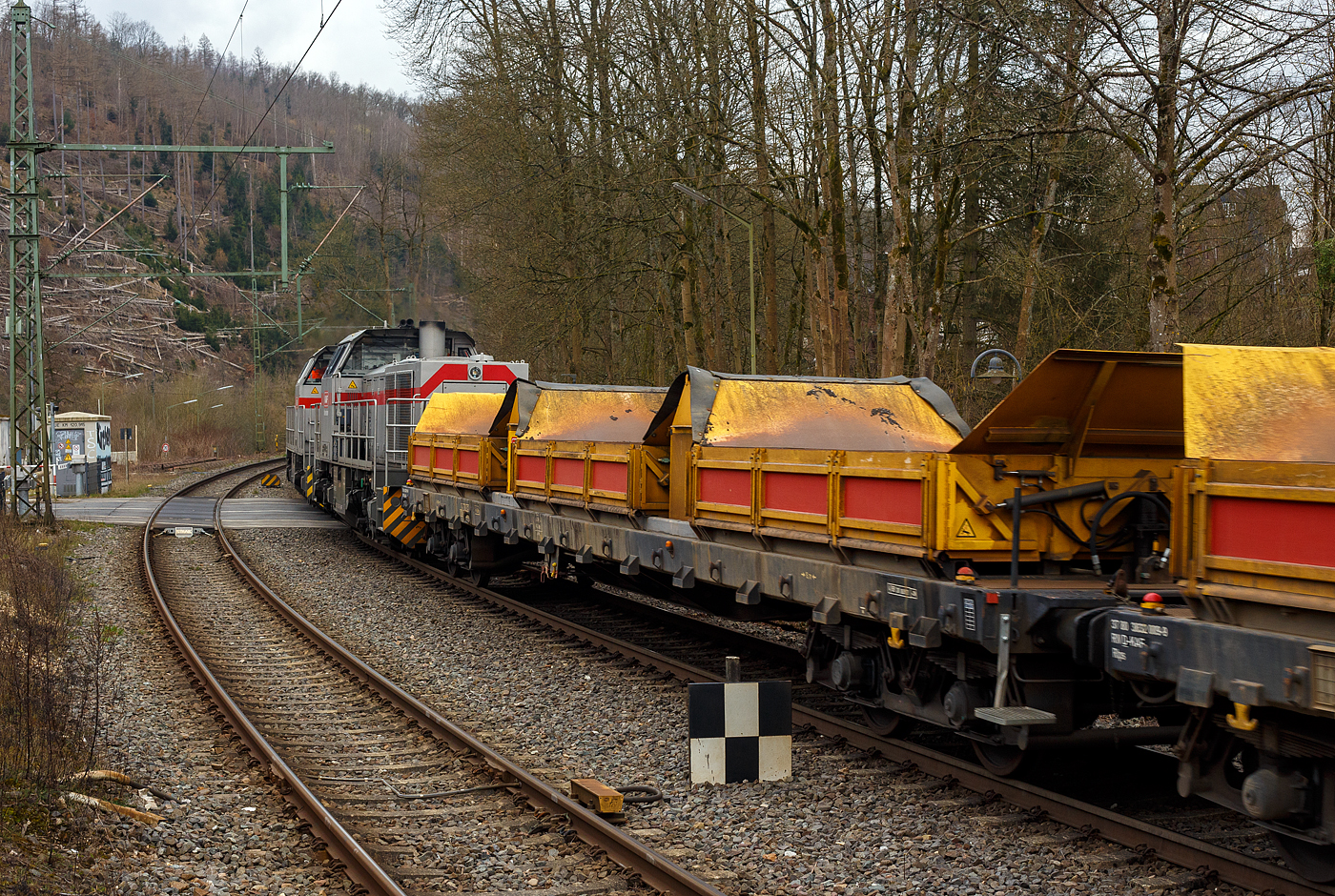 Kippwagen MK 45 DH „LW-Kipper“, 37 80 3832 010-7 RIV D-KAF, der Gattung Rlps, der KAF Falkenhahn Bau AG, Kreuztal (ehemaliger Wagen der Leonhard Weiss), am 14 März 2025 eingereiht im Zugverband bei einer Zugdurchfahrt im Bahnhof Kirchen/Sieg. 

Der von LEONHARD WEISS entwickelte Kippwagen MK 45 DH „LW-Kipper“, ist für den offenen Transport von losen, nicht zu verwehenden Schüttgütern vorgesehen. Dank der niedrigen Bauweise ist die Beladung unter abgeschalteten Oberleitungen gefahrlos möglich.

Die Ladekante ist 2.049 mm über Schienenoberkante. Der speziell ausgebildete Bediener ist für das Entladen rechts und links vom Gleis verantwortlich. Jeder Wagen ist mit einer eigenständigen Hydraulikanlage ausgestattet, welche von einem Kubota 3-Zyl. Dieselmotor angetrieben wird. So braucht man keine Fremdenergie, wie Strom oder Druckluft von der Lok.

Es wird jeweils eine Mulde pro Wagen gekippt. Es können bis zu 10 Kippwagen miteinander gekoppelt und über ein ansteckbares Bedienpult gemeinsam gesteuert werden. Die Standsicherheit ist in üblichen Überhöhungen und Radien durch eine intelligente Steuerung jederzeit gewährleistet. Die Entladezeit beträgt ca. 10 Minuten für alle 3 Mulden.

Die Vorteile des „LW-Kippers“ auf einen Blick:
NIEDRIGE BORDWANDHÖHE
SEPARATES ANTRIEBSAGGREGAT PRO WAGEN
DREI SEPARATE KIPPMULDEN PRO WAGEN

TECHNISCHE DATEN:
Gattung: Rlps
Spurweite: 1.435 mm (Normalspur)
Achsanzahl: 4 (in zwei Drehgestellen)
Länge über Puffer: 20.740 mm
Drehzapfenabstand: 15.700 mm
Achsabstand im Drehgestell: 1.800 mm
Eigengewicht: durchschnittlich 35 t (dieser 33.910 kg)
Max Zuladung: 45 t ab Streckenklasse C (dieser 46 t), somit 15 t pro Mulde (8,5 m³)
Muldenmaß (L x B x H): 5.000 x 2.480 x 520 mm
Höchstgeschwindigkeit: 100 km/h (leer und beladen)
Bremse: KE-GP-A (max. 68 t)
Tankkapazität: 120 l Diesel
Hydr. Tankkapazität: 140 l Panolin HLP 46
Kippaggregat: Wassergekühlter 3-Zyl. Dieselmotor Kubota D 1105 mit zwei Hydraulikpumpen und Überdruckventil
Höhe über Schienenoberkante in Transportstellung: 2.690 mm
Höhe über Schienenoberkante in Kippstellung: 4.009 m
Höhe über Schienenoberkante in Bordwandhöhe: 2.049 mm
Max. Kippwinkel der Mulden: 55°
Kleister befahrbarer Gleisbogen: R = 60 m, (Arbeit R =150 m)
Internationales Profil: G1
RIV Zulassung: Ja