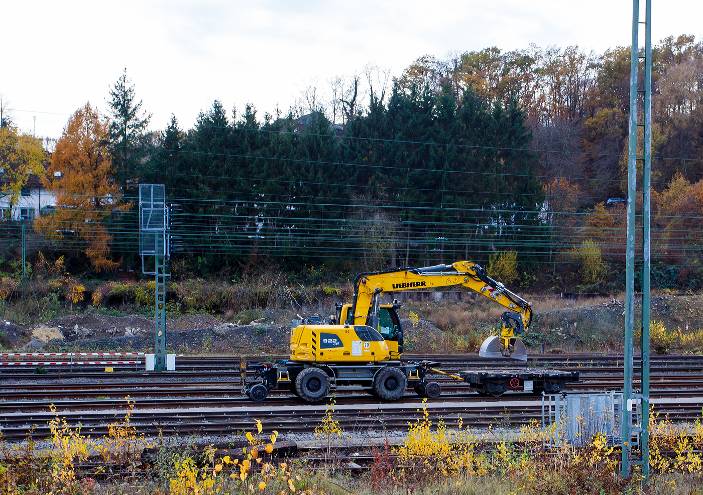 Liebherr Zweiwegebagger A 922 Rail Litronic mit Abstützpratzen, Kleinwagen Nr. D-SPAG 99 80 9904 311-4 der SPITZKE SE, interne Nr. 1171010084, mit angehangenem Gleiskraftwagenanhänger GKW-A, Kleinwagen Nr. D-SPAG 99 80 9752 0360, am 13 November 2025 im Rangierbahnhof Betzdorf/Sieg.