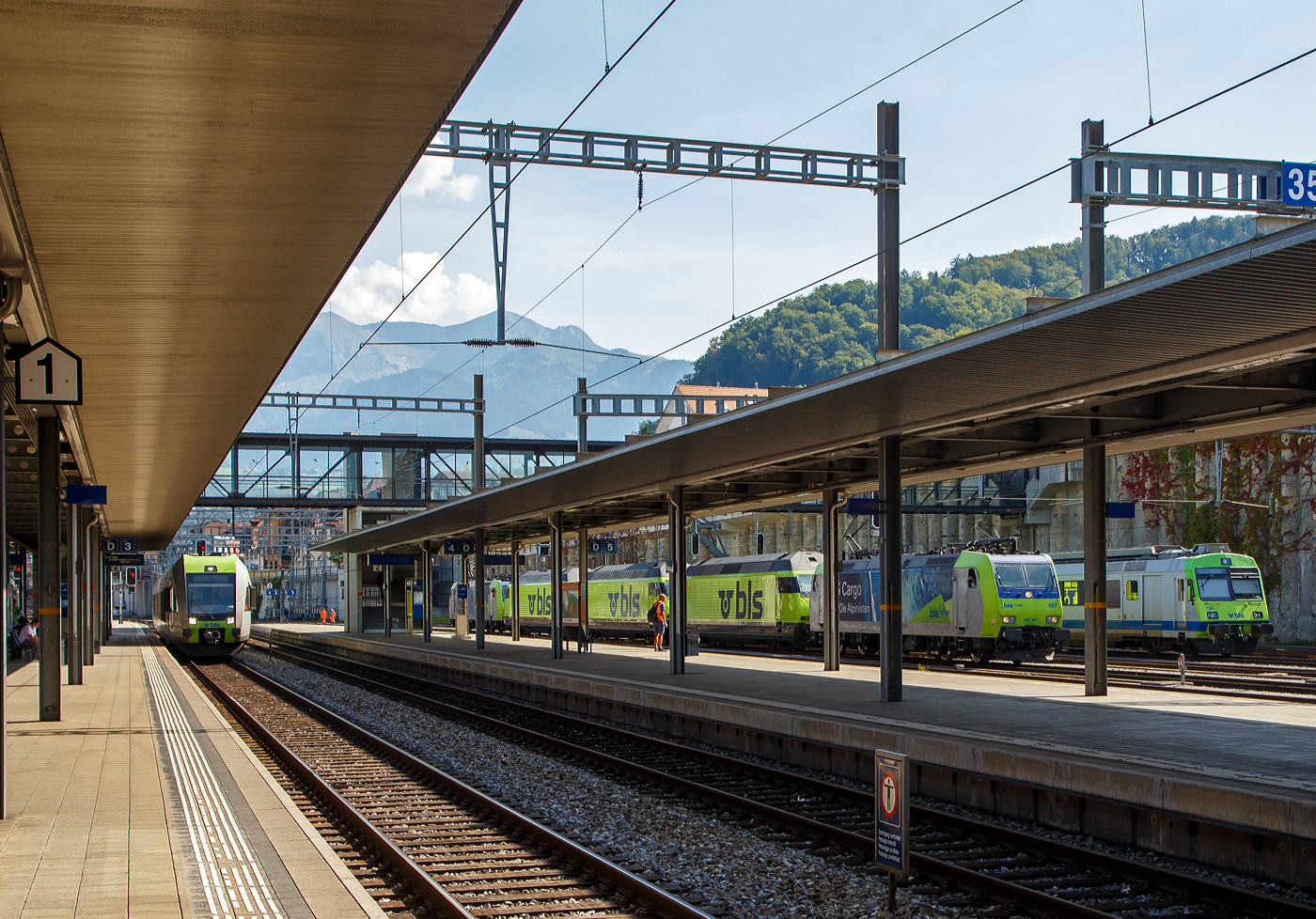 Links fährt am 08 September 2021 der vierteilige BLS  Lötschberger  RABe 535 123-4  Ausserberg  (94 85 7535 118-4 CH-BLS) der über die Lötschberg-Bergstrecke nach Brig fährt, wir fahren mit ihm gleich bis Mülenen. Ganz rechts steht der Triebwagen BLS RBDe 565 729, ex GBS RBDe 4/4 729 (Gürbetal-Bern-Schwarzenburg-Bahn), mit einem Zug. Da fährt gerade im Sandwich zweier BLS Re 485 (Bombardier TRAXX F140 AC1), drei BLS Re 465 im neuen leuchtenden BLS-Grün mit blauem Logo, fährt der Lokzug von der BLS Werkstätte Spiez am 08 September durch den Bahnhof Spiez. Vorne ist die BLS Cargo Re 485 007 (91 85 4485 007-9 CH-BLSC). Für eine bessere Sichtung war ich hier am falschen Bahnsteig.

Vermutlich war diese eine Überführung der 3 Re 465 zwischen den BLS Werkstätten Spiez und Bönigen. Die Re 465 waren fertig lackiert, aber wohl noch nicht fertig modernisiert, und so konnten sie auch nicht selbst fahren.

In den Jahren 2019 bis 2022 wurden die Lokomotiven einem Refit unterzogen. Darin enthalten waren unter anderem der Einbau der Vielfachsteuerung ZMS für den Güterverkehr mit Traxx- und Vectron-Lokomotiven und ETB (Ethernet Train Backbone) für den Autoverlad am Lötschberg. Die Kästen wurden saniert und neu in hellem BLS-Lindengrün mit blauem Logo lackiert. Die Arbeiten wurden in den eigenen Werkstätten der BLS ausgeführt, die Kosten beliefen sich auf 20 Millionen Franken.
