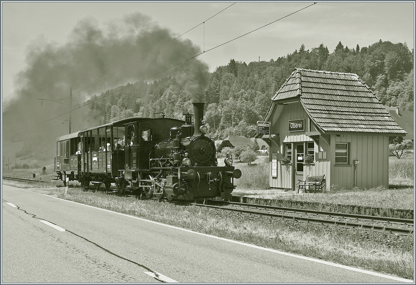 Mit einem Dampfzug der  Emmentalbahn  auf der Fahrt nach Wasen i. E. erreicht die E 3/3 853 (UIC 90 85 0008 573-3) den Halt Oberei; ein Halt auf Verlangen. Die Strecke wird zwar nicht mehr von Fahrplanmässigen Reisezügen befahren, aber Bahnhofsgebäude ist weiterhin in  Betrieb  einerseits als Bushaltestelle und andererseits dient der Wartesaal als Hofladen; und einmal pro Monat verkehrt - so steht es auf dem angeschlagenen Fahrplan - ein Museumszug der Emmentalbahn von Wasen nach Huttwil und zurück.

14. Juni 2025