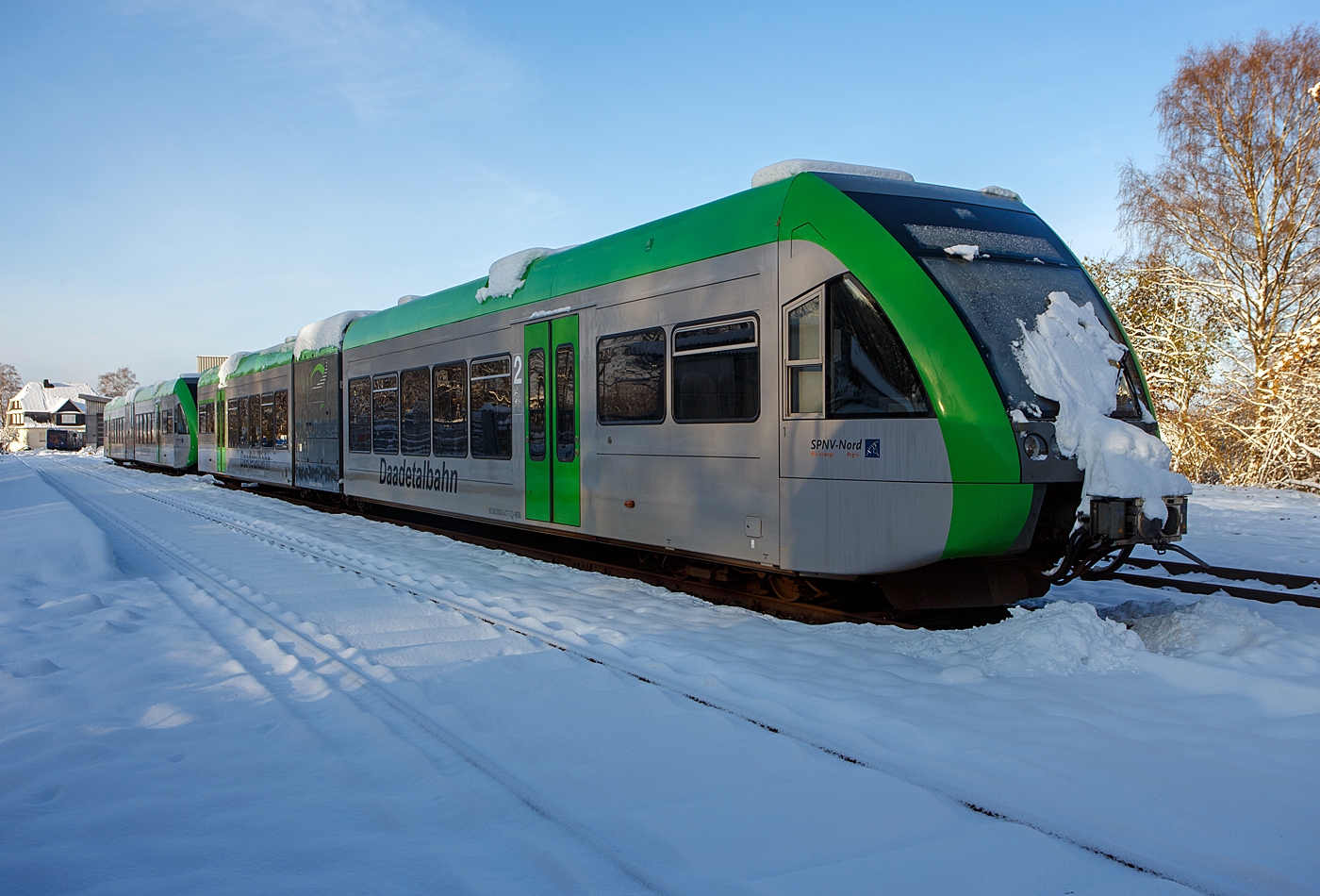 Nicht nur im S�den der Republik hat es etwas geschneit, wie hier auf dem Westerwald auf der Bindweide, aber nicht so m�chtig.
Die beiden Daadetalbahn Stadler GTW 2/6 - VT 117 (95 80 0946 417-2 D-WEBA / 95 80 0646 417-5 D-WEBA / 95 80 0946 917-1 D-WEBA) und der VT 118 (95 80 0946 418-0 D-WEBA / 95 80 0646 418-3 D-WEBA / 95 80 0946 918-9 D-WEBA) der Westerwaldbahn, beide waren bis 2015 Triebwagen der HellertalBahn GmbH, sind am ersten Advent dem am 03 Dezember 2023 dem Betriebshof der Westerwaldbahn (WEBA) auf der Bindweide bei Steinebach/Sieg abgestellt.

Diese GTW 2/6 mit dieselelektrischem Antrieb bestehen aus: Einem mittigen Antriebsmodul (auch Antriebscontainer genannt), dessen beiden Achsen angetrieben sind und das Fahrzeug bewegen. Die leicht und niederflurig gebaute jeweils zwei Endmodule mit je einem Drehgestell st�tzen sich auf das Antriebsmodul, somit ergibt sich die Achsfolge 2'Bo'2. Es ergibt sich auch eine sehr gute Raumausnutzung der Endmodule, nur ist das Fahrzeug durch das Antriebsmodul in zwei H�lften geteilt und der Gang durch den Antriebscontainer nicht barrierefrei passierbar.

Diese Triebwagen wurde 1999 bei DWA, Bautzen (Deutsche Waggonbau AG, heute Bombardier Transportation) gebaut. Der elektrische Teil und die Fahrwerke sind von Adtranz (Schweiz).

Die Antriebausr�stung besteht aus einem MTU 12V 183 TD 13 V 12 – Zylinder - Dieselmotor der seine 550 kW Leistung auf einen Dreiphasen-Generator �bertr�gt der zwei Asynchronmotoren (Adtranz, 6 RIA 4548) antreibt. Die max. Leistung an den R�dern betr�gt 420 kW, die H�chstgeschwindigkeit 120 km/h. Der kompl. Triebwagen hat eine L�nge �ber Kupplung (Scharfenbergkupplung) von 38.660 mm und ein Eigengewicht von 52 t.

TECHNISCHE DATEN:
Spurweite: 1.435 mm (Normalspur)
Achsfolge: 2'Bo'2.
L�nge �ber Scharfenbergkupplung: 38.660 mm 
Breite: 3.000 mm 
H�he: 3.850 mm 
Eigengewicht: 52 t 
Achsabstand im Drehgestell: je 2.000 mm 
Antriebsmotor:  MTU 12V 183 TD 13
Treibraddurchmesser (neu): 860 mm
Laufraddurchmesser (neu): 680 mm 
H�chstgeschwindigkeit: 120 km/h.
Max. Beschleunigung: 0,88 m/s�
Anfahrzugkraft: 62 kN
Sitzpl�tze: 120
Stehpl�tze: 103 (bei 4 Pers./m�)
