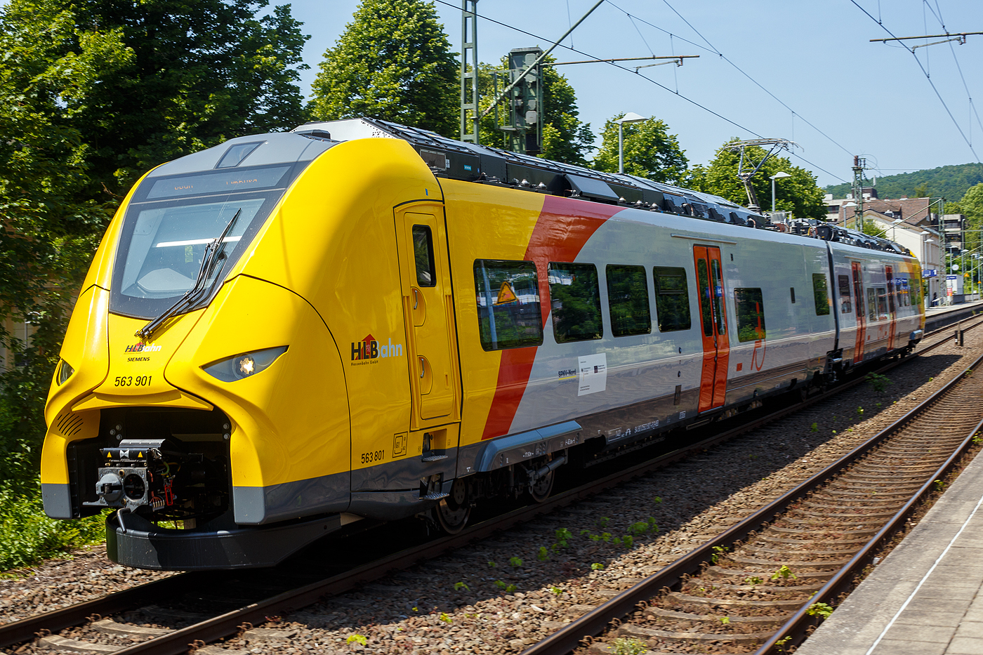 Normalerweise heißt es Dieselnetz Eifel-Westerwald-Sieg (Los 2), zudem auch die Linie RB 90  Westerwald-Sieg-Bahn  von Siegen über Betzdorf/Sieg, Au/Sieg, Altenkirchen/Westerwald und Westerburg nach Limburg/Lahn gehört. Bisher wurde die Verbindung nur mit Dieseltriebzügen der HLB vom Typ LINT 27 oder 41 gefahren. Aber die ca. 40 km lange Strecke zwischen Siegen und Au/Sieg ist elektrifiziert. Den weiteren ca. 78 km sind aber ohne Oberleitung. 

Nun wird aber auch hier elektrisch gefahren und zwar mit Hybridtriebzügen (E/Akku) vom Typ SIEMENS Mireo Plus B. Ein großer Fortschritt für den Klimaschutz am Westerwald.

Hier verlässt der HLB 563 801 / 563 901 (94 80 0563 801-0 D-HEB / 94 80 0563 901-8 D-HEB), ein zweiteiliger Hybridtriebzug (E/Akku) der BR 563 vom Typ SIEMENS Mireo Plus B der HLB (Hessische Landesbahn GmbH), am Freitag den 13 Juni 2025 den Bahnhof Kirchen/Sieg und fährt weiter in Richtung Betzdorf.