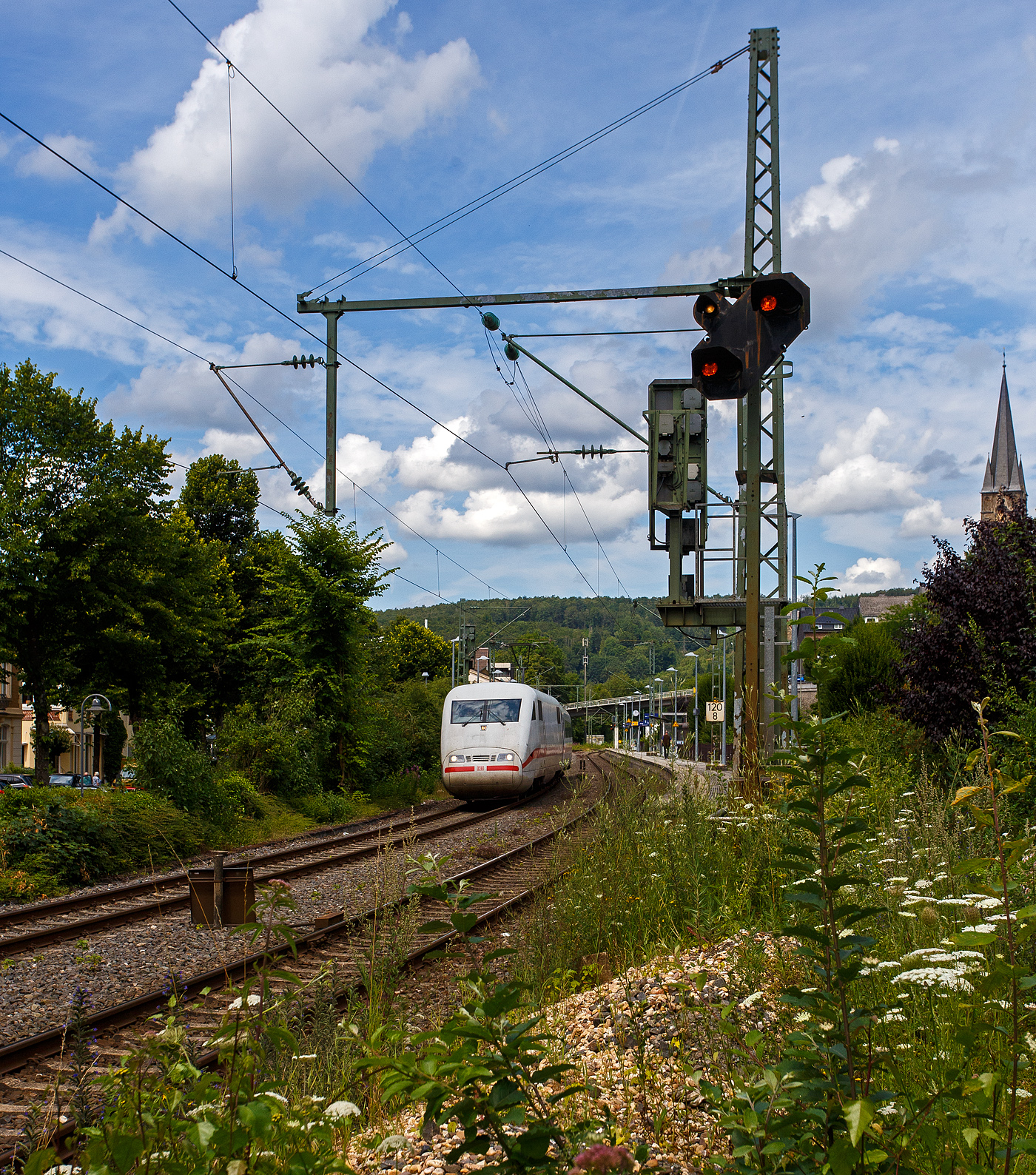 Nun fahren auch ICE auf der Siegstrecke (KBS 460), zwischen Siegen und Köln, auch wenn die Züge sehr kurz sind und nur in einer Richtung fahren können. 
Der ICE 1-Triebkopf 401 051-8 (93 80 5401 051-8 D-DB) mit dem 1. Klasse ICE1-Mittelwagen 801 047-2 (93 80 5801 047-2 D-DB / Wagen 11 vom Tz 0158 „Gütersloh“, beide der DB Fernverkehr AG, fahren am 18. Juli 2024 durch Kirchen (Sieg) in Richtung Köln.

Nochmals einen lieben Gruß an den netten Lokführer zurück.

Der Mittelwagen (Gattung Avmz ) sah recht frisch (wie neu) aus, obwohl er bereits 1991 von DUEWAG (Düsseldorfer Waggonfabrik AG) unter der Fabriknummer 89774 gebaut wurde. Der Triebkopf 401 051-8 wurde 1990 von der Krauss-Maffei AG in München-Allach  unter der Fabriknummer 19975 gebaut, der elektrische Teil wurde von SIEMENS geliefert.