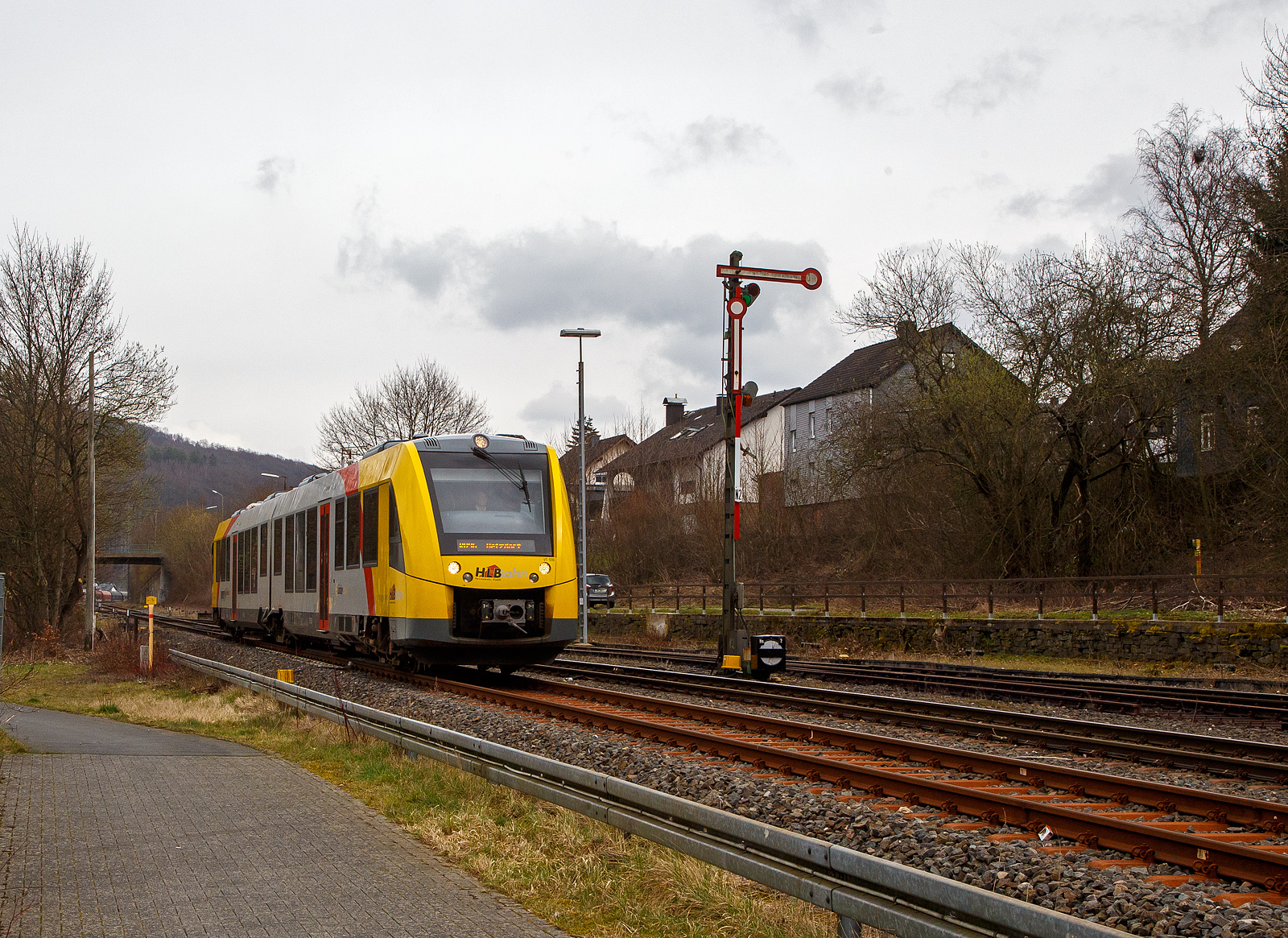 Nun fahren die Triebwagen der HLB RB 96 „Hellertalbahn“ auch endlich wieder den Bahnhof Herdorf an. Leider  ist aber dann in Herdorf am Hp Königstollen Schluss, ab dort gibt es dann von und nach Betzdorf (Sieg) SEV. Nach dem Hangrutsch (Felssturz) am 23. Dezember 2022 in Herdorf kurz hinter dem Hp  Königsstollen (bei km 88,4), ist der Abschnitt nach Betzdorf weiterhin bis mindestens bis zum kleinen Fahrplanwechsel am 11. Juni 2023, gesperrt. Aber diese ungewöhnliche Führung bis zum Hp  Königsstollen, über den Bahnhof Herdorf hinaus ist nötig, denn in den nächsten Tagen sollen die der Abriss und der Neubau der „Hellerbrücke“ der Hellerstraße (bei „Steinaus Eck“) beginnen und der SEV wäre so nur noch über Daaden oder Kirchen möglich.

Hier erreicht der VT 506 (95 80 1648 106-0 D-HEB / 95 80 1648 606-9 D-HEB), ein Alstom Coradia LINT 41 der neuen Generation / neue Kopfform, der HLB (Hessische Landesbahn GmbH) am 20.03.2023, als RB 96 „Hellertalbahn“ nach Betzdorf, bald den Bahnhof Herdorf.

Rechts das 1901 gebaute mechanische Weichenwärter Stellwerk Herdorf ost (Ho). Die beiden Stellwerke in Herdorf (Hf und Ho) sind in der Bauform Jüdel. Die Stellwerke der Bauform Jüdel (Max Jüdel & Co, Braunschweig) sind neben der Einheitsbauform am häufigsten in Deutschland anzutreffen. Viele andere Stellwerkshersteller haben Jüdel-Stellwerke in Lizenz gefertigt und dabei mehr oder weniger starke Änderungen vorgenommen.