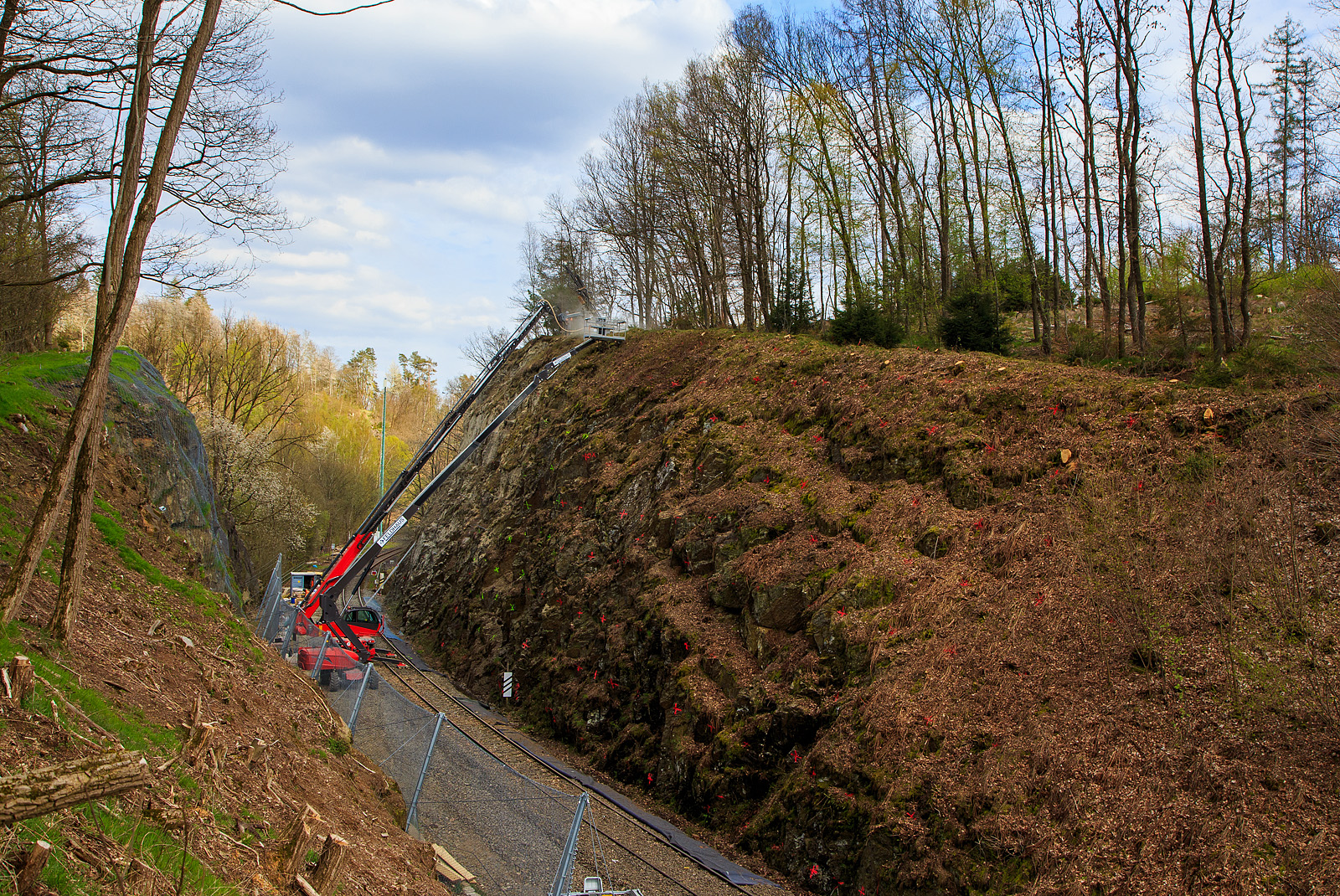 Nun haben die Felssicherungsarbeiten endlich begonnen....
Am 23. Dezember 2022 ca. 18:15 Uhr kam es hier, in Herdorf kurz hinter dem Hp  K�nigsstollen (bei km 88,4 der Hellertalbahn KBS 462), zu einem Felssturz und der HLB Triebwagen VT 507, als RB 96 „Hellertalbahn“ entgleiste, verletzt wurde zum Gl�ck niemand. Nun nach �ber vier Monaten haben endlich die erforderlichen Sicherungsma�nahmen begonnen, hier am 27.04.2023. Zuerst m�ssen viele 4 m lange Anker in den Fels getrieben werden. Die Arbeiten werden von der Firma FELDHAUS Bergbau GmbH & Co. KG aus Schmallenberg (Hochsauerland) ausgef�hrt. 

