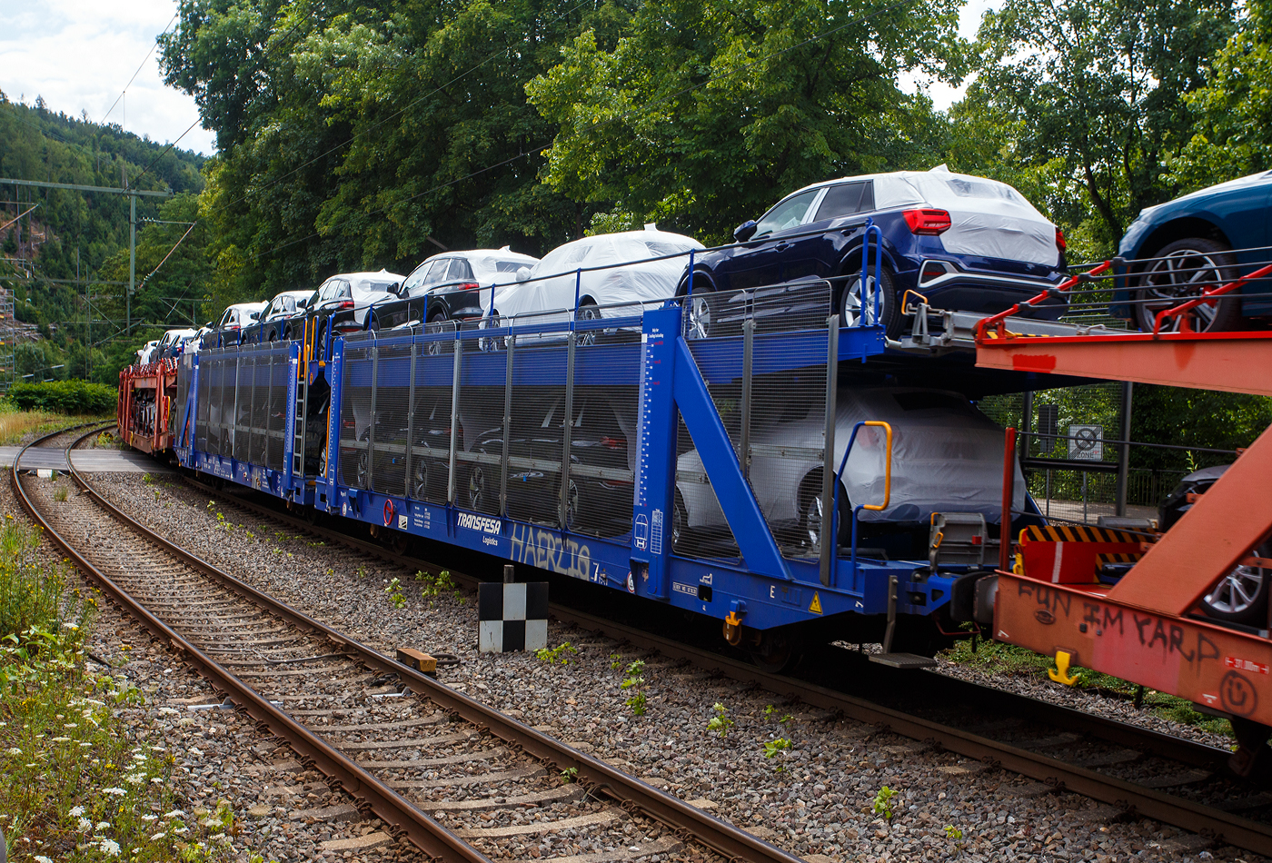 Offener vierachsiger (2 x zweiachsiger) Doppelstock-Autotransportwagen 25 80 4363 222-7 D-TRFSA der Gattung Laaers, der spanischen DB Tochter Transfesa Logistics S.A., beladen mit Autos der bekannten Marke aus Ingolstadt, am 16 Juli 2025 im Zugverband bei einer Zugdurchfahrt durch Kirchen (Sieg) in Richtung Köln. 

TECHNISCHE DATEN:
Gattung: Laaers 
Spurweite: 1.435 mm (Normalspur)
Anzahl der Achsen: 4
Länge über Puffer: 31.000 mm
Achsabstände: 10.000 mm / 5.160 mm / 10.000 mm
Laufraddurchmesser (neu): 840 mm (außen) / 730 mm (mittleren)
Ladelänge: 30.070 mm (unten) / 30.550 mm (oben)
Höchstgeschwindigkeit: 100 km/h (120 km/h leer)
Eigengewicht: 34.000 kg
Nutzlast: 30 t bei Streckenklasse A, 34,0 t ab B (max. 18 t pro Ebene)
Kleinster befahrb. Gleisbogenhalbmesser: 75 m
Bremse: KE-GP-A
Verwendungsfähigkeit: TEN-GE

Die Transfesa Logistics S.A. ist ein spanisches Transport- und Logistik-Unternehmen mit Sitz in Madrid, das sich auf Schienen- und Straßentransporte unter anderem für die Automobilindustrie spezialisiert hat. An Transfesa sind die Deutsche Bahn (ca. 84 %) und die Renfe (ca. 11 %) beteiligt. Der Rest ist im Streubesitz.