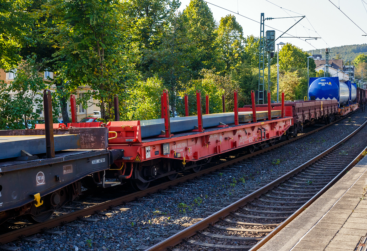 Sechsachsiger Drehgestell-Flachwagen, mit Rungen, Stirnwandklappen und klappbaren Ladeschwellen, jedoch ohne Seitenwandklappen, 31 80 4852 931-3 D-DB, der Gattung Samms 489.1, der DB Cargo AG, am 17 September 2024 im Zugverband bei der Durchfahrt im Bahnhof Kirchen (Sieg).

Der Wagen wurde 2019 von Tatravagonka a.s. in Poprad (Slowakei) unter der Fabriknummer 072 gebaut. Zusammen mit Stahlkunden entwickelt die damalige DB Schenker im Jahre 2007 einen neuen Flachwagen, der auf die Bedürfnisse der Branche noch besser eingeht. Gebaut wurden sie von dem slowakischen Hersteller Tatravagonka Poprad.

Der Wagen dient mit aufgeklappten Ladeschwellen zur Beförderung von schweren Walzprofilen und anderen sperrigen Gütern. Mit eingeklappten Ladeschwellen, also mit ebener Ladeebene, eignet er sich auch zum Transport schwerer Kettenfahrzeuge. Für das Be- und Entladen solcher Fahrzeuge sind befahrbare Stirnwandklappen vorhanden. Die Wagenbrücke ist eine in Rahmenbauweise ausgeführte Schweißkonstruktion, deren Hauptbauteile aus S355J2 (St 52) bestehen. Die Hauptbelastungen werden von den äußeren Langträgern aufgenommen. Das Kopfstück und Untergestell sind so ausgebildet, dass später ohne große Änderungen die AK eingebaut werden kann. Der Fußboden besteht aus Kiefernbohlen mit den Abmessungen 70 x 200 mm; er kann eine Radlast von 5,0 t aufnehmen. Im Fußboden sind 6 geteilte klappbare Ladeschwellen eingebaut, ebenso 6 Zurrpunkte je Längsseite. An den Außenlangträgern sind 26 Bindeösen angebracht.

Das Fahrzeug hat auf jeder Längsseite 6 Einsteckrungen und 6 zusätzliche Rungenschächte, wodurch eine variable Platzierung der Rungen ermöglicht wird (anders als bei den Vorgänger-Modellen). An jeder Stirnseite gibt es je 2 versenkbare Rungen (Fallrungen). Die Stirnwände sind umklappbar.

TECHNISCHE DATEN:
Gattung: Samms 489.1 (Gattungskennzahl 4852)
Spurweite: 1.435 mm (Normalspur)
Länge über Puffer: 16.400 mm
Drehzapfenabstand: 9.150 mm
Radsatzstand in den Drehgestellen: 3.400 mm (2 x 1.700 mm)
Raddurchmesser: 920 mm (neu)
Drehgestell-Typ: BA 714.3
Ladelänge: 15.000 mm
Ladebreite: 2.630 mm (zwischen den Rungen)
Fußbodenhöhe über SO: 1.300 mm
Ladefläche: 46 m²
Eigengewicht: 31.000 kg
Zuladung bei Lastgrenze S: 74,0 t (ab Streckenklasse D)
Zuladung auf DB Netz ab Streckenklasse CE: 89,0 t (max.100 km/h)
Max. Zuladung: 104,0 t (bauartspezifische Tragfähigkeit)
Max. Geschwindigkeit: 100 km/h (beladen) / 120 km/h (leer)
Kleinster Gleisbogenhalbmesser: 75 m
Bauart der Bremse: KE-GP-A (K) max. 88 t
Bremssohle: Cosid 810
Handbremse: Ja
Internationale Verwendungsfähigkeit: TEN-GE 
