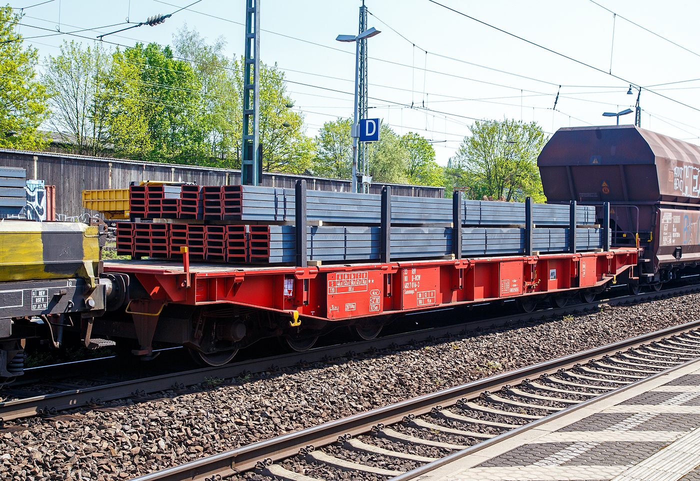 Sechsachsiger Drehgestell-Flachwagen (Schwerlastwagen), mit Rungen, jedoch ohne Stirn- und Seitenwandklappen, 33 80 482 7 016-3 D-RCW der Gattung Sammnps 482, eingestellt durch die Rail Cargo Group (zu �BB) in Deutschland, am 20.04.2018 im Zugverband bei der Durchfahrt im Bahnhof Bonn-Beuel, hier beladen mit U-Stahl (warmgewalzter Profilstahl in Herstellungsl�nge vom 12 m). Nach dem Aufkleber (MFI) zu urteilen, geh�rt der Wagen der MFI - Mat�riel Ferroviaire et Industriel S.A. und ist �ber die RCW eingestellt.

Der Wagen wurde ca. 1990 von der Waggonfabrik Talbot in Aachen gebaut.

TECHNISCHE DATEN (laut Anschriften):
Gattung: Sammnps 482 (Gattungskennzahl 4827)
Spurweite: 1.435 mm (Normalspur)
L�nge �ber Puffer: 16.400 mm
Drehzapfenabstand: 9.400 mm
Radsatzstand in den Drehgestellen: 3.400 mm (2 x 1.700 mm)
Raddurchmesser: 920 mm (neu)
Drehgestell-Typ: BA 714.3
Ladel�nge: 15.100 mm
Ladebreite: 2.630 mm (zwischen den Rungen)
Fu�bodenh�he �ber SO: 1.300 mm
Ladefl�che: 46,9 m�
Eigengewicht: 28.750 kg
Zuladung bei Lastgrenze S: 76,0 t (ab Streckenklasse D)
Zuladung auf DB Netz ab Streckenklasse CE: 91,0 t (max.100 km/h)
Max. Zuladung: 106,0 t (bauartspezifische Tragf�higkeit)
Max. Geschwindigkeit: 100 km/h (beladen) / 120 km/h (leer)
Kleinster Gleisbogenhalbmesser: 75 m
Bauart der Bremse: KE-GP (LL)
Bremssohle: IB 116
Internationale Verwendungsf�higkeit: RIV

Bedeutung der Gattungsbezeichnung (Sammnps) :
S = Flachwagen mit Drehgestellen in Sonderbauart
a =  mit sechs Rads�tzen (2 Drehgestelle mit je 3 Rads�tzen)
mm =  bei sechs o. mehr Rads�tzen Ladel�nge unter 18 m
n = bei sechs o. mehr Rads�tzen h�chste Lastgrenze �ber 75 t 
p = ohne Borde
s = zugelassen f�r Z�ge bis 100 km/h (beladen)