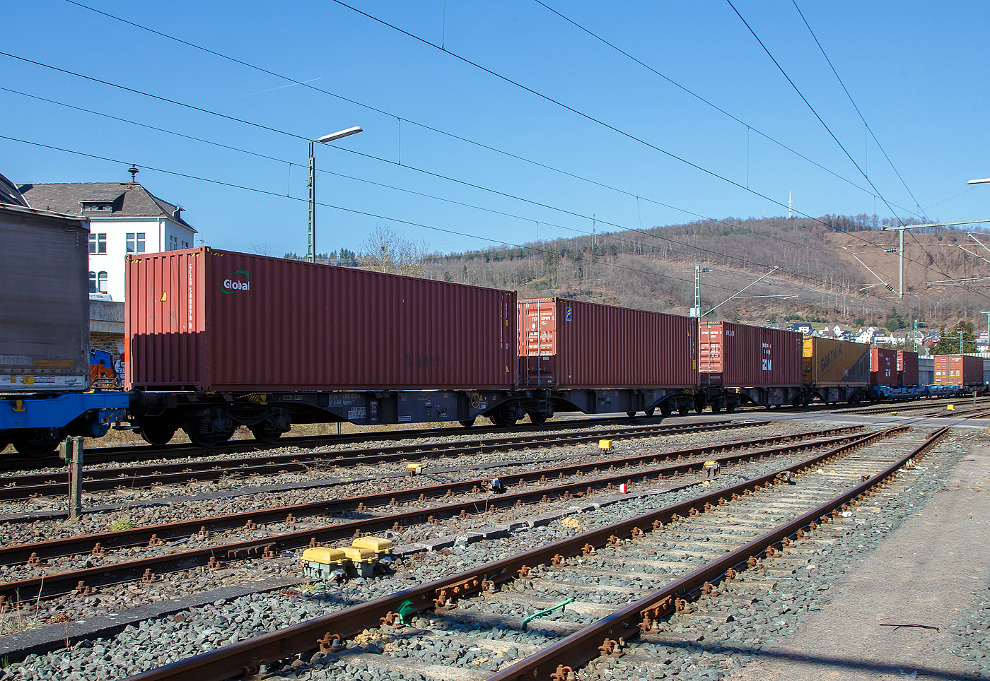 Sechsachsiger Drehgestell-Gelenk-Containertragwageneinheit, 37 80 4961 855-6 D-ERR, der Gattung Sggmrss 1, der ERR European Rail Rent GmbH (Duisburg) am 24.03.2021 im Zugverband bei der Durchfahrt in Niederschelden an der Siegstrecke (KBS 460) in Richtung Köln.

Diese Gelenkwagen mit sechs Radsätzen sind für den Transport von Großcontainern und Wechselbehältern vorgesehen. Auf den Außenlangträger des Wagens befinden sich für jede vorgesehene Ladeposition feste und klappbare Aufsetzzapfen zum Festlegen der Ladungseinheiten (gemäß UIC- Merkblatt 592-1 und 2) in verschiedenen Kombinationen.

Das aus zwei Wagenhälften bestehende Untergestell ist eine verwindungsweiche, geschweißte Rahmenkonstruktion aus Walz- und Blechprofilen, gebildet aus den Kopfstücken, den Hauptquerträgern und den äußeren Langträgern. In der Wagenmitte befindet sich eine Übersteigmöglichkeit.

TECHNISCHE DATEN:
Spurweite: 1.435 mm
Länge über Puffer: 29.590 mm
Drehzapfenabstand: 2 x 11.995 mm
Achsabstand in den Drehgestellen: 1.800 mm
Drehgestelle: 3 x Y25Lss1-K
Laufraddurchmesser: 920 mm (neu)
Ladelänge: 2 x 13.820 mm
Höhe der Ladeebene über S.O.: 1.155 mm
Eigengewicht: 27.000 kg
Max. Zuladung bei Lastgrenze S: 108,0 t (ab Streckenklasse D)
Max. Zuladung bei Lastgrenze SS: 93,0 t (ab Streckenklasse C)
Max. Geschwindigkeit: 100 km/h (Lastgrenze SS und leer 120 km/h)
Kleinster befahrbarer Gleisbogen: R 75 m 
Bremse: 2 x KE-GP-A  (K)
Bremssohle: Cosid 810
Feststellbremse: Ja (100 %)
Verwendungsfähigkeit: TEN_GE

Bedeutung der Gattung Sggmrss:
S = Flachwagen mit Drehgestellen in Sonderbauart
gg = für die Beförderung von Containern mit einer Gesamtlänge
über 60 Fuß geeignet
m = Ladelänge >= 15 m und < 18 m
r = Gelenkwagen
ss = zugelassen für Züge bis zu 120 km/h