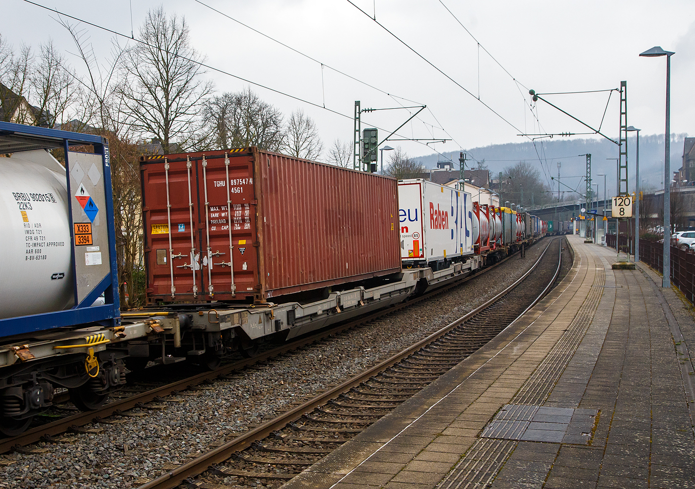 Sechsachsiger Gelenk-Taschenwagen (Doppeltaschenwagen in Gelenkbauart), 33 85 4956 718-2 CH-HUPAC der Gattung Sdggmrss, der HUPAC Intermodal SA, am 23.02.2023 im Zugverband bei der Durchfahrt in Kirchen (Sieg), hier beladen mit einem Container und einem Sattelanhängern.

Diese Wagen vom Typ T5/T3000e wurde von Tatravagónka a.s. in Poprad (Slowakei) ab 2015 gebaut, die Entwicklung und Konstruktion ist von der  Ferriere Cattaneo SA in Giubiasco (Schweiz). Baugleiche Wagen sind auch bei anderen Halteren im Einsatz, die jeweils die Gattungskennzahl 4956 haben. Mögliche Ladeeinheiten sind zwei kranmanipulierbare Sattelauflieger oder alternativ bis zu vier Wechselbrücken und/oder Container. Dafür besitzt der Wagen einen dreifach verstellbaren Stützbock sowie für die Ladungseinheiten feste und klappbare Aufsetzzapfen auf den Langträgern. Das maximale Zuladegewicht beträgt für Sattelauflieger 2 × 40 t; die Basishöhe liegt bei 270 mm über SO.

TECHNISCHE DATEN:
Spurweite: 1.435 mm
Länge über Puffer: 34.200 mm
Drehzapfenabstand: 2 x 14.200 mm
Achsabstand in den Drehgestellen: 1.800 mm
Laufraddurchmesser: 920 mm (neu) / 860 mm (abgenutzt)
Ladelänge: 2 × 16.185 mm
Eigengewicht: 36.500 kg
Max. Zuladung bei Lastgrenze S: 98,5 t (ab Streckenklasse D)
Max. Zuladung bei Lastgrenze SS: 83,5 t (ab Streckenklasse C)
Max. Geschwindigkeit: 100 km/h (Lastgrenze S) / 120 km/h (bei Lastgrenze SS oder leer)
Kleinster  befahrbarer Kurvenradius: R 75 m (R 150 m im Zugverband)
Bremse: 2 x DK-GP-A (D)  (Dako Scheibenbremsen)
Bremssohle: Jurid J707
Feststellbremse: Ja, am mittleren Drehgestell
Intern. Verwendungsfähigkeit: TEN – GE

Die Bedeutung der Gattungs- und Kennbuchstaben (hier  Sdggmrss):
S - Drehgestell-Flachwagen in Sonderbauart
d - für den Transport von Straßenfahrzeugen eingerichtet
gg - für den Transport von Containern über 60 Fuß eingerichtet
m - bei mit sechs o. mehr  Radsätzen Ladelänge 18 m bis unter 22 m
r - Gelenkwagen
ss - Höchstgeschwindigkeit (beladen) bis zu 120 km/h