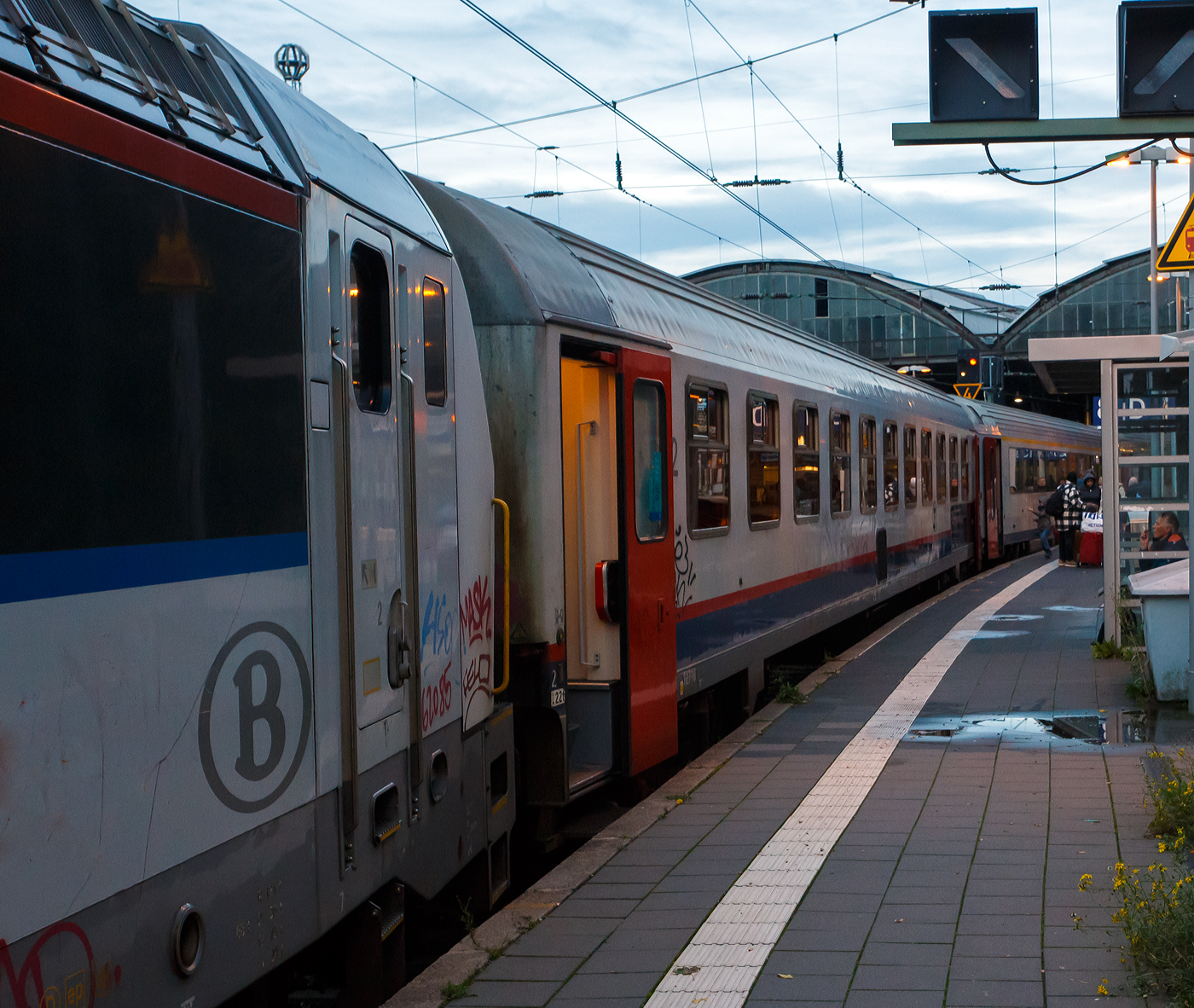 SNCB/NMBS - I10 Reisezugwagen (Schnellzugwagen für den internationalen Verkehr) der 2. Klasse, 51 88 21-70 010-2 B-B, ex B11 – 12710, eingereiht im Zugverband des euregioAIXpress (S41) von Liège-Saint-Lambert über Welkenraedt nach Aachen (d'Aix-la-Chapelle), am 21 Oktober 2025 im Hauptbahnhof Aachen. Der Wagen hat die RIC-Zulassungen für Frankreich, Deutschland, Österreich, die Niederlande, Italien, die Schweiz, Luxemburg, sowie natürlich Belgien (F, D, A, NL, I, CH, L, B).

Die Gattung I10 sind eine Serie von ursprünglich 95 Schnellzugwagen der Nationalen Gesellschaft der Belgischen Eisenbahnen (NMBS/SNCB), die in den Jahren 1987 und 1988 hergestellt wurden. Abgeleitet von den Eurofima-Wagen aus den 1970er Jahren entwickelte die NMBS/SNCB ab 1984 die neue I 10-Serie. Diese Wagen trugen viele Merkmale der Eurofima-Wagen, waren aber alle als Großraumwagen ausgeführt und besitzen einen einheitlichen Wagenkasten. Von den normalen Eurofima-Wagen unterscheiden sie sich vor allem durch die fehlende Schürze unter den seitlichen Längsträgern. Zwischen den Türen befinden sich jeweils elf 1.200 Millimeter breite Fenster plus die der WC´s auf einer Wagenseite. Davon wurden 15 Wagen als erster Klasse-Fahrzeuge und 45 Fahrzeuge mit der zweiten Wagenklasse ausgeführt. Da diese Wagen nicht klimatisiert sind, wurden die üblichen M4-Fenster mit Schiebeluke verwendet, wie sie für belgische Inlandswagen typisch sind. Die 35 Wagen der zweiten Klasse mit Klimaanlage B11 (HVAC) besitzen hingegen feststehende Fenster. Die 15 Erste-Klasse-Wagen des Typs A11t bieten 66 Sitzplätze, die 80 Zweite-Klasse-Wagen des Typs B11t haben 86 Sitzplätze.

Eingesetzt wurden die I 10-Wagen ursprünglich im internationalen Verkehr nach Italien, Deutschland und in die Schweiz. Nach der Einstellung der meisten internationalen Züge sind die Wagen heute nur noch im Interregio von Liers nach Luxemburg und in Verstärkerzügen zur Hauptverkehrszeit, oder wie hier im S41 dem euregioAIXpress nach Aachen zu finden.

TECHNISCHE DATEN:
Spurweite: 1.435 mm (Normalspur)
Anzahl der Achsen: 4 (2´2´)
Länge über Puffer: 26.400 mm
Wagenkastenlänge: 26.100mm
Drehzapfenabstand: 19.000 mm
Achsstand im Drehgestell: 2.560 mm
Drehgestelle: FIAT Y 0270 S t.34
Achsstand (gesamt): 21.560 mm
Wagenkastenbreite: 2825 mm
Höhe über SO: 4.050 mm
Eigengewicht: 41 t
Höchstgeschwindigkeit: 160 km/h
Sitzplätze: 86 in der 2. Klasse im Großraumabteil
Toiletten: 2 (geschlossenes System)
