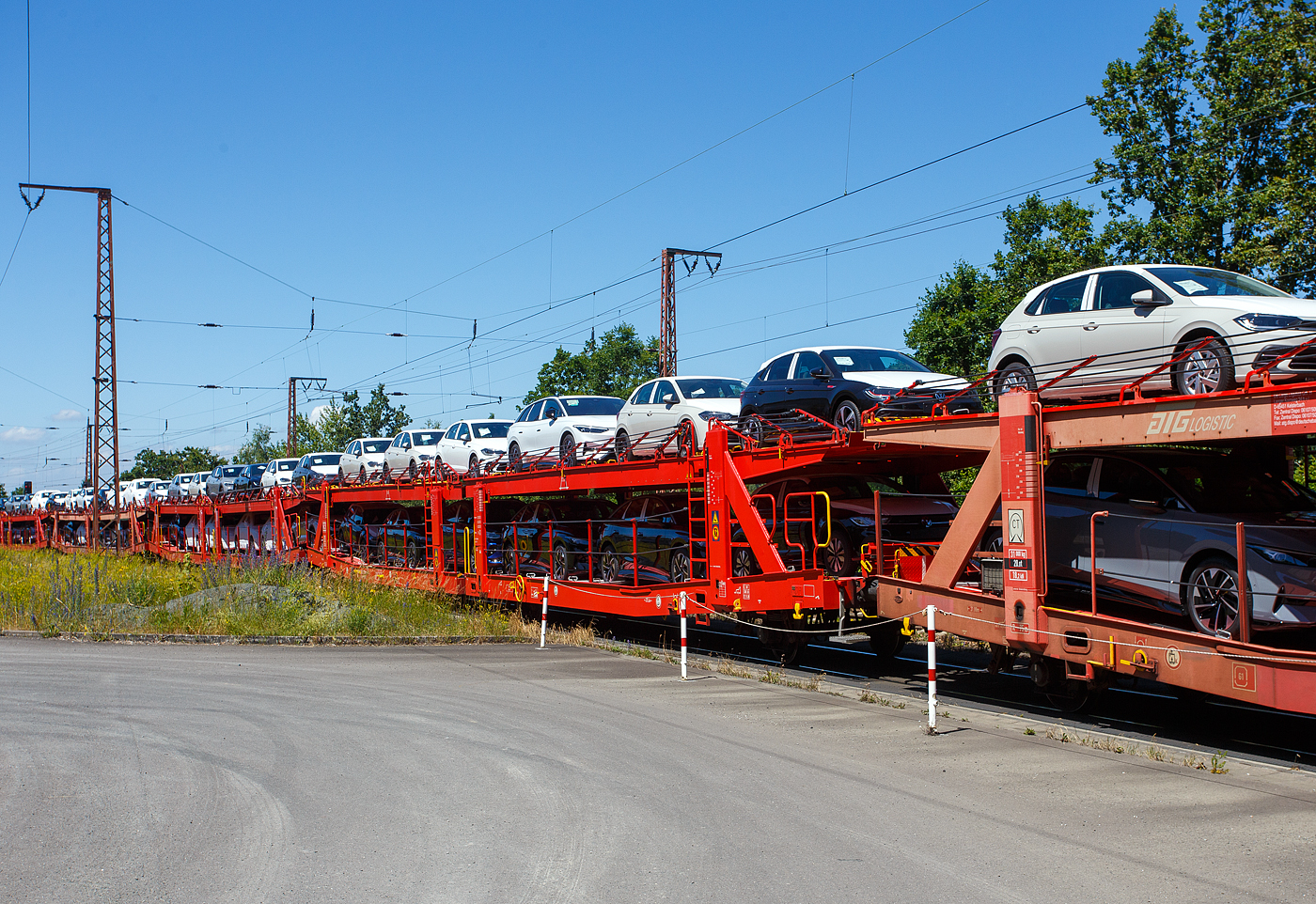Vierachsiger (2 x zweiachsiger) Doppelstock-Autotransportwagen, 25 80 4363 070-0 D-ATG, der Gattung Laaers 560.2, der DB Cargo Logistics GmbH (ex DB Schenker ATG) am 28 Juni 2024 im Zugverband bei der Zugdurchfahrt in Rudersdorf (Kreis Siegen), hier beladen mit VW PKW´s aus der „Stadt des KdF-Wagens bei Fallersleben“ (ab 1945 Wolfsburg).

Der Wagen wurde 201_ von der damaligen DB Waggonbau Niesky GmbH gebaut.

Diese Waggons haben zwei Ladeebenen und sind für den europaweiten Transport geeignet. Sie werden für den internationalen Transport von PKWs, SUVs und Vans eingesetzt und bieten maximale Flexibilität durch eine stufenlos verstellbare obere Ladeebene. Aufgrund der hohen Lastgrenze (bis 34 t) ist der Transport von besonders schweren Fahrzeugen der genannten Typen möglich.

Damit sowohl ein typenreiner Transport als auch eine Mischverladung in den unterschiedlichen Lademaßen möglich ist, kann die obere Ladeebene hinsichtlich der Transportstellungen stufenlos eingestellt werden.

Durch die Entwicklung eines veränderten Ladungssicherungssystems wurde den Kundenanforderungen nach optimierten Transportmöglichkeiten für Fahrzeuge mit niedrigerer Bodenfreiheit Rechnung getragen.

TECHNISCHE DATEN:
Gattung: Laaers (Bauart 560.2)
Erstes Baujahr der Wagengattung: 2007
Spurweite: 1.435 mm
Anzahl der Achsen: 4 (2 x 2)
Länge über Puffer : 31.000 mm
Achsabstände: 10.000 mm / 5.160 mm / 10.000 mm
Laufraddurchmesser (neu): äußere 840 mm und mittlere 730 mm
Ladelänge : 30.070 mm (unten) / 30.550 mm (oben)
Ladelänge waagerechter Teil untere Ebene: 19.400 mm
Ladebreite : 2.950 (unten) / 2.750 mm (oben)
Höchstgeschwindigkeit: 100 km/h (120 km/h leer)
Eigengewicht: 30.500 kg
Max. Zuladung bei Lastgrenze S: 33,5 t (ab Streckenklasse B, bei A 32,0 t)
Max. Zuladung der Ladeebenen: unten und oben jeweils max. 18 t
Max. Gewicht je Pkw: 2.800 kg (Radlast max. 1 t)
Anzahl der Radvorleger: 64
Höhe Geländer oben: 600 mm
Kleinster befahrb. Gleisbogenhalbmesser: 75 m
Bremse: KE-GP-A (K)
Bremssohle: Jurid 816 M
Handbremse: Ja
Intern. Verwendungsfähigkeit: TEN-GE

Der große Unterschied zwischen den Laaers-Wagen der Bauart 560.2 (wie hier) und der Bauart 560.1 sind das Lastgrenzenraster (Max. Zuladung), zudem ist die Bauart 560.2 meist 500 kg leichter. 