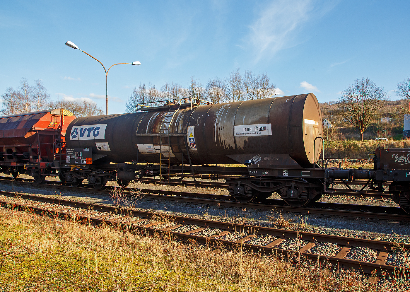 Vierachsiger 34 m� Drehgestell Kesselwagen mit Bremserb�hne, 33 80 7874 648-8 D-VTG, der Gattung Zaces, der VTG Rail Europe GmbH (Hamburg), abgestellt am 21.02.2023 in Herdorf, im Zugverband eines �bergabezuges der KSW, auf dem Rbf. der KSW. 

Die Gefahrguttafel (X886/1831) zeigt an, was drin war oder ist:
Schwefels�ure (rauchend), auch bekannt als Oleum oder Vitriol (rauchend). Sie wird unteranderem zur Herstellung von Sprengstoffen verwendet, was hier bei der Fa. Dynamit Nobel Defence in Burbach-W�rgendorf der Fall ist.

TECHNISCHE DATEN:
Gattung: Zaces 
Spurweite: 1.435 mm
L�nge �ber Puffer : 14.400 mm
Drehzapfenabstand: 9.360 mm
Achsabstand im Drehgestell: 1.800 mm
Laufraddurchmesser:  920 mm (neu)
H�chstgeschwindigkeit: 100 km/h
Eigengewicht: 21.220 kg
Max. Ladegewicht: 58,7 t (ab Streckenklasse C)
Gesamtvolumen: 34.000 Liter (34 m�)
Bauart der Bremse: KE-GP (LL)
Bremssohle: IB 116
Handbremse: Ja
Kleinster befahrbarer Gleisbogen: R 36 m
Tankcode: L10DH (Zul�ssiger Betriebs�berdruck 4 bar)
Beh�lterwerkstoff : Edelstahl
Intern. Verwendungsf�higkeit: RIV

Die Bedeutung der Gattung Zaces:
Z = Kesselwagen
a = 4 Rads�tze
c = Entladung durch Druckluft oder Luftst��e
e = mit Heizung
s = zugelassen f�r Z�ge bis 100 km/h (beladen)