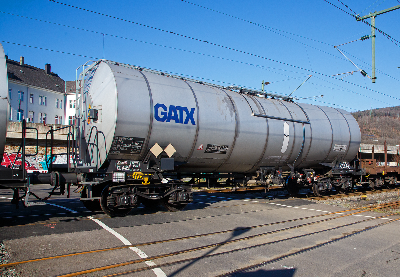 Vierachsiger 73 m³ Drehgestell-Kesselwagen mit Isolierung und Heizung sowie mit  Bremserbühne, 33 84 79x33 798-6 NL-GATXD, der Gattung  Zacens (GATX Typ 1472), der Vermietungsfirma GATX Rail Germany GmbH, im Zugverband am 14.02.2023 bei der Zugdurchfahrt in Niederschelden (Sieg). 

Der Wagen wurde von Tatravagónka a.s. in Poprad (Slowakei) gebaut, konnte ich hier anhand des Fabrikschildes erkennen. 

Dieser 73 m³-Wagen ist eine weitere Evolutionsstufe für den Transport von hochviskosen Materialien und Ölprodukten. Es wurde eine Optimierung in Bezug auf Länge und Gewicht erreicht. Dieser Wagen ist zusätzlich mit beheizten Seitenventilen ausgestattet.

TECHNISCHE DATEN (gem. Anschriften) :
Spurweite: 1.435 mm
Achsanzahl: 4 (in 2 Drehgestelle)
Länge über Puffer: 14.140 mm
Drehzapfenabstand: 9.100 mm
Achsabstand im Drehgestell: 1.800 mm
Laufraddurchmesser:  920  mm (neu) 
Drehgestelltyp: Y25Ls-K
Eigengewicht: 21.790 kg
Tankinhalt: 73.058 Liter (ca. 73 m³)
Max. Ladegewicht: 68,2 t (ab Streckenklasse D)
Höchstgeschwindigkeit: 100 km/h (beladen) / 120 km/h (leer)
Bremse: MH-GP (K)
Bremssohle: C 810
Handbremse: Ja, auf Bremserbühne
Tankcode: L4BH TE14
Intern. Verwendungsfähigkeit: TEN-GE

Die Bedeutung der Gattung Zacens:
Z = Kesselwagen
a = 4 Radsatz
c = Entladung durch Druckluft oder Luftstöße
e = mit Heizung
n = Lademasse bei Lastgrenze C: m > 60 t für vierachsige Wagen
s = zugelassen für Züge bis 100 km/h