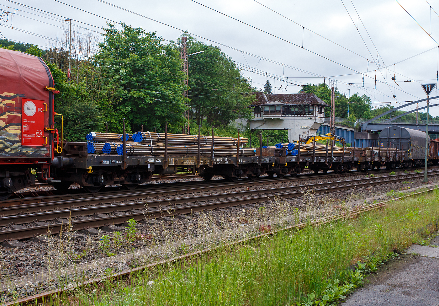 Vierachsiger Drehgestell-Flachwagen mit Drehrungen und Stirnwandklappen, jedoch ohne Seitenborde, 31 80 396 1 753-1 D-DB, der Gattung Rmms 664, der DB Cargo AG, beladen mit Rundstahl, am 03 Juni 2024 im Zugverband bei einer Zugdurchfahrt in Kreuztal.

Ab 1968 ließ die DB 1.760 Rmms 664 bauen, dieser 1973 von der Waggon Union in Berlin.

Mit einer Ladelänge von 12,80 m dienen diese Wagen mit aufgeklappten Ladeschwellen zur Beförderung von schweren langen Erzeugnissen der Eisen- und Stahlindustrie (wie Walzprofile) und anderen sperrigen und schweren Gütern. Mit eingeklappten Ladeschwellen, also mit ebener Ladefläche, eignet er sich auch für die Beförderung von schweren Kettenfahrzeugen. Vor den umlegbaren Stirnwänden sind je zwei absenkbare Rungen angeordnet. Der Wagen kann mit umgelegten Stirnwänden und abgesenkten Rungen gefahren werden. Die Höhe der umgelegten Stirnwände über FO beträgt 38 mm. An den Längsseiten hat der Wagen je 6 Drehrungen. Der Fußboden besteht aus Kiefernbohlen mit den Abmessungen 70 x 180 mm. Er kann eine Radlast von 5,0 t aufnehmen. Im Fußboden sind 6 geteilte, klappbare Ladeschwellen eingebaut.

Die an den Stirnseiten angeordneten Überfahrklappen gestatten abgeklappt das Durchfahren von Gleisbögen mit mindestens 150 m Halbmesser. Die Überfahrklappen liegen im abgeklappten Zustand auf 4 Konsolen auf. In senkrechter Stellung werden sie durch je 2 am Kopfstück angeordneten Fallrungen gehalten.

Die Wagen haben eine Klotzbremse mit stufenlos, selbsttätiger Lastabbremsung. Die Bremskraft nach dem minder belasteten Drehgestell gesteuert. Das Steuerventil ist im Wagenuntergestell angeordnet.

TECHNISCHE DATEN:
Spurweite: 1.435 mm (Normalspur)
Gattung/Bauart: Rmms 664
Erstes Baujahr: 1968
Anzahl der Achsen: 4 in 2 Drehgestellen
Länge über Puffer: 14.040 mm
Drehzapfenabstand: 9.000 mm
Achsabstand im Drehgestell: 1.800 mm
Ladelänge: 12.644 mm
Ladebreite: 2.904 mm 
Ladefläche: 36,0 m²
Fußbodenhöhe über SO: 1.235 mm
Höchstgeschwindigkeit: 100 km/h (beladen) / 120 km/h (leer)
Eigengewicht: 21.000 kg (sonst. Ø 21.800 kg(
Maximale Ladegewicht: 59 t (ab Streckenklasse C)
Laufraddurchmesser (neu): 920 mm
Kleinster bef. Gleisbogenradius: 35 m
Bauart der Bremse: KE-GP-A  max. 56 t (LL)
Handbremse: Fbr (wirkt auf beide Drehgestelle)
Internationale Verwendungsfähigkeit: RIV

Die Bedeutung der Gattung Remms:
R = Drehgestellflachwagen in Regelbauart
mm = Ladelänge unter 15 m
s = zugelassen für Züge bis 100 km/h (beladen)
664 = Bauartnummer
