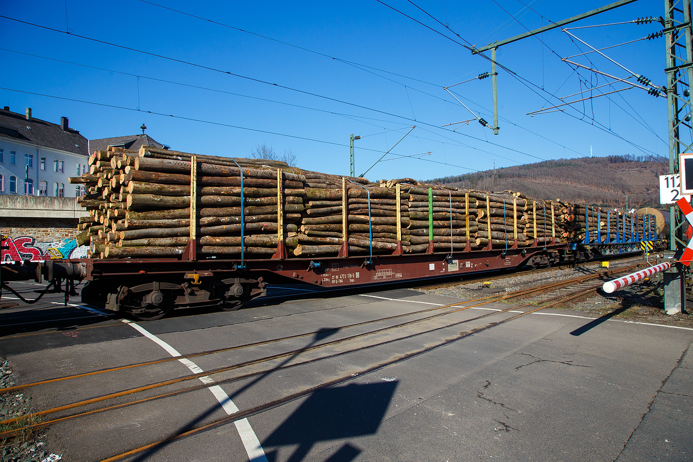 Vierachsiger Drehgestell-Flachwagen mit Niederbindeeinrichtung, 37 80 4723 110-5 D-TWA, der Gattung Snps, der TRANSWAGGON GmbH, beladen mit Stammholz, am 14.02.2023 im Zugverband bei der Durchfahrt in Niederschelden (Sieg).

Der Wagen wurde von Tatravagonka Poprad (Slowakei) gebaut.

TECHNISCHE DATEN:
Gattung: Snps (TWA Typ SNP3)
Spurweite: 1.435 mm (Normalspur)
Länge über Puffer: 23.240 mm
Drehzapfenabstand: 17.730 mm
Radsatzstand in den Drehgestellen: 1.800 mm
Ladelänge: 21.980 mm
Ladebreite zwischen Rungen: 2.540 mm
Ladefläche: ca. 56 m³
Rungenhöhe: 2.050  mm (Nutzbare Rungenhöhe 1.930 mm)
Anzahl Rungen: 20 (10/Seite)
Eigengewicht: 25.000 kg 
Max. Zuladung: 65 t (ab Streckenklasse D) 
Max. Geschwindigkeit: 100 km/h / 120 km/h (leer)
Kleinster Gleisbogenhalbmesser: 36 m
Bremse: KE-GP (LL)
Ladegut: Stammholz
Intern. Verwendungsfähigkeit: RIV
