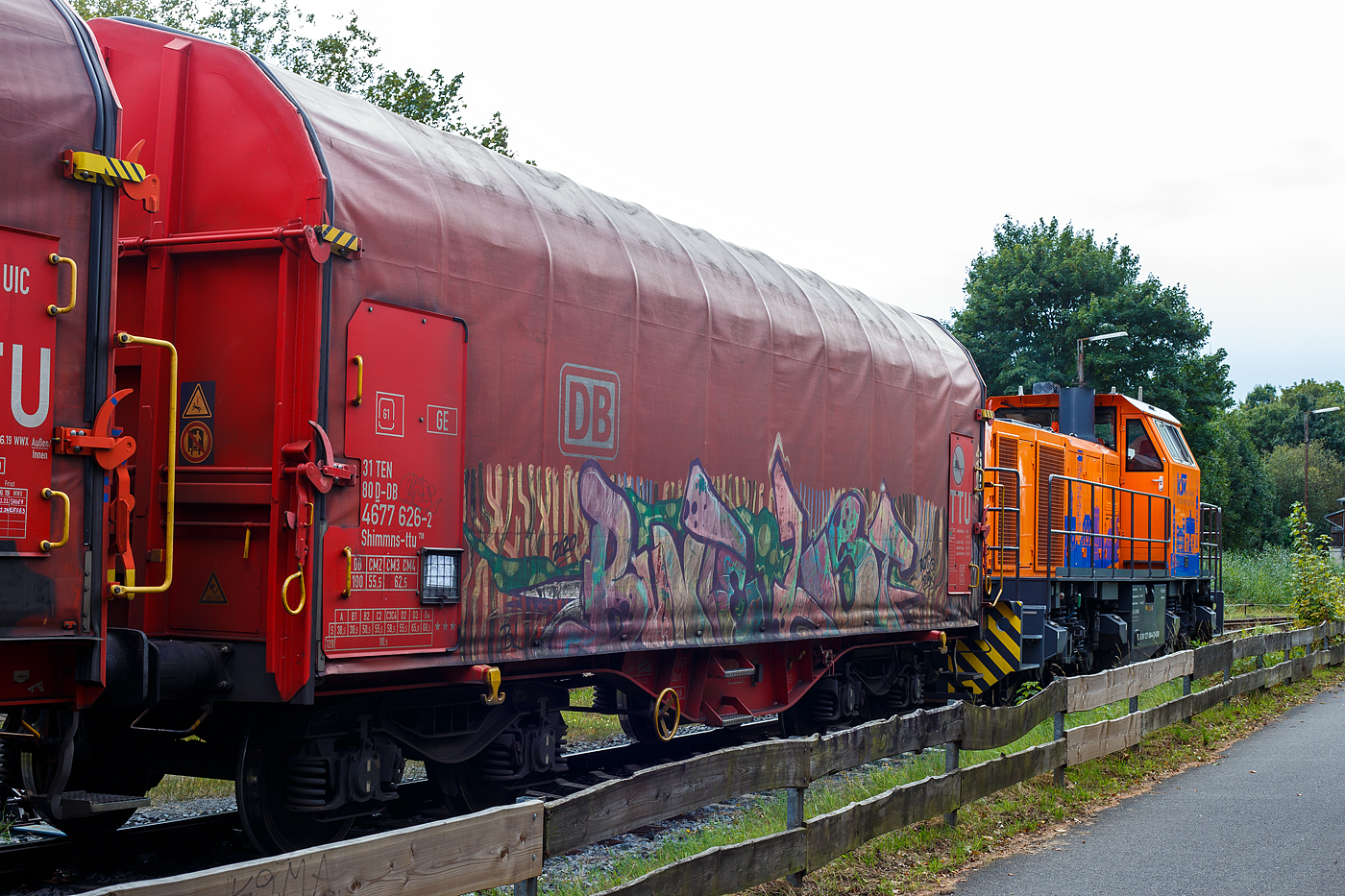 Vierachsiger Drehgestell-Flachwagen mit verschiebbarem Planenverdeck und Lademulden für Coil-/Spaltbandtransporte, 31 80 4677 626-2 D-DB, der Gattung Shimmns-ttu 728, der DB Cargo AG, am 12 September 2024 im Zugverband, auf dem KSW Rbf in Herdorf (Betriebsstätte Freien Grunder Eisenbahn - NE 447), hier direkt hinter der KSW 44 (92 80 1271 004-4 D-KSW) eine MaK G 1000 BB.

Der Wagen wurde 2019 vom rumänischen Güterwagenhersteller Astra Rail Industries (ARI, heute zu The Greenbrier Companies) in Arad unter der Fabriknummer 925008 gebaut, die Drehgestelle vom Typ Y25Lsd-KP1 sind auch von Astra Rail (Fabriknummer 512 SH). Die Intern. Verwendungsfähigkeit des Wagens ist TEN-GE.

Das Nachsetzzeichens ttu, hier bei den Shimmns-Wagen bedeutet: 
tt = mit besonderer, stufenlos verstellbarer Festlegeeinrichtung zur Sicherung gebündelter Schmalband-Coils 
Die Wagen sind mit 20 verstellbaren Festlegearmen (4 je Mulde) ausgerüstet, die auf den Muldenhöckern gelagert sind und sich über Rollen in den Mulden abstützen. Ihre Form und Festigkeit ist so ausgelegt, dass sie einen sicheren Schutz gegen unzulässiges seitliches Verschieben, als auch gegen Kippen gebundener Schmalbandcoils gewährleisten. Gegenüber herkömmlichen Shimmns-Wagen sind die Festlegearme mit einer stufenlosen Feinverstellung ausgerüstet, welche sicherstellt, dass ein unmittelbarer Kontakt zur Stirnfläche der Coils entsteht und somit ein Teleskopieren ausgeschlossen ist.

u =  Auskleidung der Mulden mit gewebeverstärkten Gummimatten
Die Auskleidung der Mulden mit einer 10 mm starken Gummieinlage soll einen optimalen Schutz des Coilbleches unterstützen. Die mittig geteilte Gummiauflage ist auf den Satteln der Lademulden befestigt. Zwischen den Gummiauflagen ist mittig längs verlaufend ein weißer Farbstrich als Orientierung für die Beladung aufgebracht.
