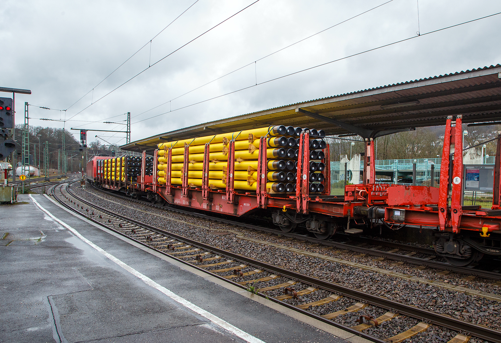 Vierachsiger Drehgestellflachwagen mit Rungen, Stirnwandklappen und Niederbindeeinrichtung, 81 80 4712 097-2 D-DB, der Gattung Sns 727, der DB Cargo AG am 01.04.2023 im Zugverband bei einer Zugdurchfahrt im Bahnhof Betzdorf (Sieg). Hier beladen mit 36 gelb beschichteten Gasrohren bzw. HFI-längsnahtgeschweißte Stahlrohre Ø 323.9 x 12,7 (DN/NW 300 mm bzw. 12 ¾ Inch) mit gelber MAPEC® Polyethylen (HDPE)-Umhüllung), in Herstellungslänge vom 12 m. Das Metergewicht der Rohre beträgt 97,5 kg/m (ohne Umhüllung), so ist der Wagen mit ca. 45 t beladen. Der Hersteller der Stahlrohre ist die Mannesmann Line Pipe GmbH in Siegen (ex RW Fuchs), gehört zum Salzgitter-Konzern.

In den Jahren 2001 und 2002 beschafft die DB AG vierachsige Flachwagen mit festen Rungenpaaren und niedrigen, umlegbaren Stirnborden, die mit je zwei kurzen Fallrungen gesichert werden. Die bei Grennbrier Europe Wagony Swidnica gebauten (dieser 2002) und als Sns 727 eingereihten Wagen, gleichen in vielen Komponenten den parallel beschafften Rbns 646, sind jedoch 5,91 m kürzer. Durch die reduzierte Länge und den kleineren Kurvenüberhang ließ sich die Wagenbreite um 330 mm gegenüber dem Rbns 646 vergrößern, und die Ladebreite von 2,52 m auf 2,85 m.

Wagenboden ist mit begehbaren (und nicht befahrbaren) Gitterrosten vollständig abgedeckt, die 15 hölzernen Ladeschwellen sind fest. An jeder Wagenseite befinden sich acht, innen mit Schichtholzleisten versehene Festrungenpaare, die im entlasteten Zustand oben 20 mm zur Fahrzeugmitte geneigt sind. Die in den Rungen integrierten Spannvorrichtungen verfügen über so lange Gurte, dass auch eine das G2-Profil ausnutzende Ladung gesichert werden kann. Der Sns 727 ist vorzugsweise für die Beförderung von Rohren, sowie den Transport von schweren Stahlerzeugnissen vorgesehen und überwiegend in festen Relationen im Einsatz.

TECHNISCHE DATEN:
Gattung: Sns 727
Spurweite: 1.435 mm (Normalspur)
Länge über Puffer: 20.440 mm
Drehzapfenabstand: 14.140 mm
Radsatzstand in den Drehgestellen: 1.800 mm
Ladelänge: 19.098 mm
Ladebreite: max. 2.850 mm (zwischen den Rungen)
Ladefläche: 54,4 m²
Fußbodenhöhe über SO: 1.350 mm (OK Ladeschwelle)
Rungenhöhe: 2.000 mm
Eigengewicht: ca. 26.500 kg 
Zuladung bei Lastgrenze S: 63,5 t (ab Streckenklasse D); DB Netz CM 57,5
Max. Geschwindigkeit: 100 km/h / 120 km/h (leer)
Kleinster Gleisbogenhalbmesser:	 75 m
Bauart der Bremse: KE-GP-A (LL)
Bremssohle: IB 116
Verwendungsfähigkeit: nein
