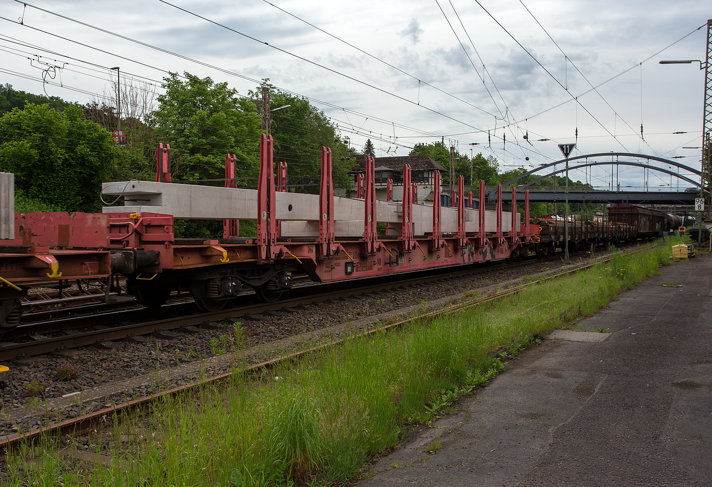 Vierachsiger Drehgestellflachwagen in Regelbauart der DB Cargo AG (ex DB Schenker), 81 80 3507 857-0 D-DB der Gattung Rbns 646.1, am 21 Mai 2024 beladen mit einem Fertigbetonträger, im Zugverband bei der Zugdurchfahrt in Kreuztal.

Dieser Drehgestell-Flachwagen mit vier Radsätzen (mit Rungen und Stirnwandklappen, jedoch ohne Seitenwandklappen) ist ausgestattet mit 10 Rungenpaaren mit Niederbindeeinrichtungen zur Verzurrung des Ladegutes, umlegbare Stirnwandklappen, feste Ladeschwellen. 

Der Wagen dient vorzugsweise zur Beförderung von Stahlerzeugnissen, z. B. Rohren und Profilen. Zur Aufnahme und Abstützung der Ladung sind auf dem Wagenboden Ladeschwellen und an den Wagenlängsseiten Rungen angebracht. Zur Verzurrung des Ladegutes ist jedes Rungenpaar mit einer Niederbindeeinrichtung ausgerüstet, die von einer Person bedient werden kann. Die Spanngurte sind zur Schonung des Ladegutes mit einem elastischen Werkstoff ummantelt. Die Länge des Gurtes und die Teilung der Raster sind so gewählt, dass auch Ladungen, die nur etwa die halbe Rungenhöhe einnehmen, verzurrt werden können.

Für die Auflage des Ladegutes sind hölzerne Ladeschwellen im Rungenbereich vorhanden. Zwischen den äußeren Rungen und den Stirnwandklappen ist jeweils eine zusätzliche Ladeschwelle angeordnet. Die Ladeschwellen sind genügend hoch, so dass die handelsüblichen Umschlagmittel verwendet werden können. Die Ladeschwellen bestehen außen aus Hartholz und mittig aus einem nagelbaren Weichholzkern.

Der Wagenboden ist mit einem begehbaren Riffelblech vollständig abgedeckt. Zur Aufnahme von Lasten oder zum Befahren mit Flurförderfahrzeugen sind die Abdeckungen nicht geeignet. Jedes Kopfende ist zur Ladungssicherung mit einer nach außen umlegbaren Stirnwandklappe versehen, die durch zwei kurze absenkbare Rungen gesichert werden. Die Wagen können mit umgelegten Stirnwandklappen und abgesenkten Rungen verkehren.

Zur Sicherung der Ladung sind auf jeder Wagenlängsseite in gleichmäßigen Abständen 10 senkrecht stehende Rungen vorhanden. Die Rungen sind mit dem Untergestell-Außenlangträger fest verbunden und so ausgeführt, dass sie die durch die Ladung entstehenden Kräfte in Wagenlängs- und Wagenquerrichtung sicher aufnehmen können. Für die Unterhaltung kann die Verbindung gelöst werden (An- und Abbauen der Rungen nur in Werkstätten). Die Innenseiten der Rungen sind zum Schutz des Lagegutes mit einer Schutzleiste aus Schichtholz ausgekleidet.

TECHNISCHE DATEN 
Gattung:  Rbns 646.1
Hersteller: Fabryka Wagonow Gniewczna (Polen)
Länge über Puffer: 26.350 mm
Drehzapfenabstand: 20.050 mm
Achsabstand im Drehgestell: 1.800 mm
Ladelänge: 25.008 mm
Ladebreite: 2.520 mm
Ladefläche: 63,0 m²
Wagenhöhe (Rungenoberkante): 3.360 mm
Wagenbreite: 3.020 mm
Rungenhöhe: 1.980 mm
Höhe der Ladeschwellen: 100 mm
Fußbodenhöhe über SO: 1.380 mm
Höchstgeschwindigkeit: 100 km/h (beladen) 120 km/h (leer)
Maximales Ladegewicht: 60,5 t ab Streckenklasse D / DB CM auch 54,5 t
Eigengewicht: 29.500 kg
Drehgestell-Bauart: 629 (Y 25)
Kleinster bef. Gleisbogenradius: 75 m
Bremse: KE-GP-A (K)
Bremssohle: C810 / Cosid 810 (Komposit-Bremssohle, kurz K-Sohle)
Handbremse: tlw. Fbr
Austauschverfahren: 81 (international durch Sondervereinbarungen einsetzbar)
Erstes Lieferjahr/ Baujahr der z. Z. ältesten Wagen: 2001