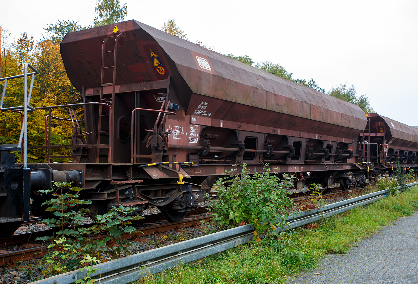 Vierachsiger offener Drehgestell-Schüttgutwagen mit dosierbarer Schwerkraftentladung, 31 80 6940 387 D-DB, Gattung Facs 124 (ex DR Gattung Eads-y), der DB Cargo AG, steht 12 Oktober 2025, eingereiht in einen Schotterzug, im Bahnhof Herdorf.

Der Wagen wurde 1979 ANF Industrie in Frankreich für die DR – Deutsche Reichbahn gebaut und geliefert. 

Die DR ließ zwischen 1978 und 1980 bei der französischen Firma Ateliers de construction du Nord de la France, abgekürzt ANF Industrie, auch bekannt unter Markenname „Blanc-Misseron“, über 1.450 vierachsige offene Selbstentladewagen mit vier Kammern bauen, die zunächst als Eads-y (5970) eingereiht werden. Bei der DB AG wurden die Wagen 1994 in Facs 124 umgezeichnet. Die ANF Industrie mit Sitz in der französischen Kleinstadt Crespin im Département Nord (an der Grenze zu Belgien), wurde 1990 von Bombardier Transportation übernommen, 2021 übernahm dann Alstom das Werk von Bombardier Transportation.

Bei den offenen Selbstentladewagen hat der Laderaum die Form mehrerer nebeneinanderstehender (4) Trichter. Der Entladevorgang erfolgt über die Schwerkraft des Ladegutes. Mehrere Auslauföffnungen mit Drehschiebern (4 pro Längsseite) ermöglichen die restlose Entladung des Wagens nach der einen oder anderen Seite. Die Menge ist regulierbar - so wie es zum Beispiel für die Entladung über Förderband erforderlich ist. Geeignet sind die Wagen für den Transport nicht nässeempfindlicher Güter in loser Schüttung. Die Drehschieber über einer Einrichtung auf der Bühne an einer Stirnseite des Wagens können einzeln bedient werden.

Der Wagen ist für den Transport von Nässe unempfindlichen Schüttgütern vorgesehen. Das Untergestell besteht aus miteinander verschweißten Blechen und Walzprofilen. Der Wagenkasten ist eine Schweißkonstruktion und besteht aus vier Trichtern. Querrippen teilen den Wagenkasten in vier Räume, von denen jeder an seinem Unterteil zwei Entladeöffnungen aufweist, die sich an beiden Seiten der horizontalen Mittellinie des Wagens befinden. Über jeder Entladeöffnung ist am Kastenblech eine Stütze für einen Vibrator angeschraubt.
Die acht kreisförmig ausgebildeten Wölbschieber sind auf Rollen gelagert und verschieben sich auf Laufbahnen, die außerhalb der Rinnen angebracht sind. Unter jeder Entladeöffnung sind eine feste und eine schwenkbare Auslaufrutsche angeordnet. Die schwenkbaren Auslaufrutschen werden einzeln durch einen Hebel betätigt, der in der Nähe der Rutsche angebracht ist. Die Betätigung der Wölbschieber erfolgt von der Bedienungsplattform aus. Die Entladung des Wagens erfolgt nach Öffnen der Schieber durch die Schwerkraft des Ladegutes. Für den Zugang zur Bedienungsplattform sind zwei Auftritte mit Gitterrosten (500 x 160 mm) vorhanden. Die Menge ist regulierbar - so wie es zum Beispiel beim Einschottern erforderlich ist.

Das Entfernen von Ladegutresten in der Be- oder Entladestraße ist nur durch leichte Gummihammerschläge auf die äußeren Behälterwandungen gestattet oder durch den Einsatz von Pressluftlanzen im Laderaum!

TECHNISCHE DATEN:
Hersteller: ANF Industrie (Frankreich)
Spurweite: 1.435 mm (Normalspur)
Achsanzahl: 4 (in 2 Drehgestellen)
Länge über Puffer: 19.040 mm
Drehzapfenabstand: 14.000 mm
Achsabstand im Drehgestell: 1.800 mm
Laufraddurchmesser: 920 mm (neu)
Größe der Beladeöffnung: 1.800 x 15.300 mm
Laderaum:  70 m³
Breite der festen Auslaufrutschen: 600 mm
Breite der schwenkbaren Auslaufrutschen: 476 mm
Wagenhöhe:  4.000 mm
Höchstgeschwindigkeit: 100 km/h (beladen) / 120 km/h (leer)
Maximales Ladegewicht: 55,0 t (ab Streckenklasse C)
Eigengewicht: 25.000 kg
Drehgestell-Bauart: Y 25 Cs – 639
Kleinster bef. Gleisbogenradius: 75 m
Bauart der Bremse:  KE-GP (LL)
Bremssohle: IB 116
Intern. Verwendungsfähigkeit: RIV
