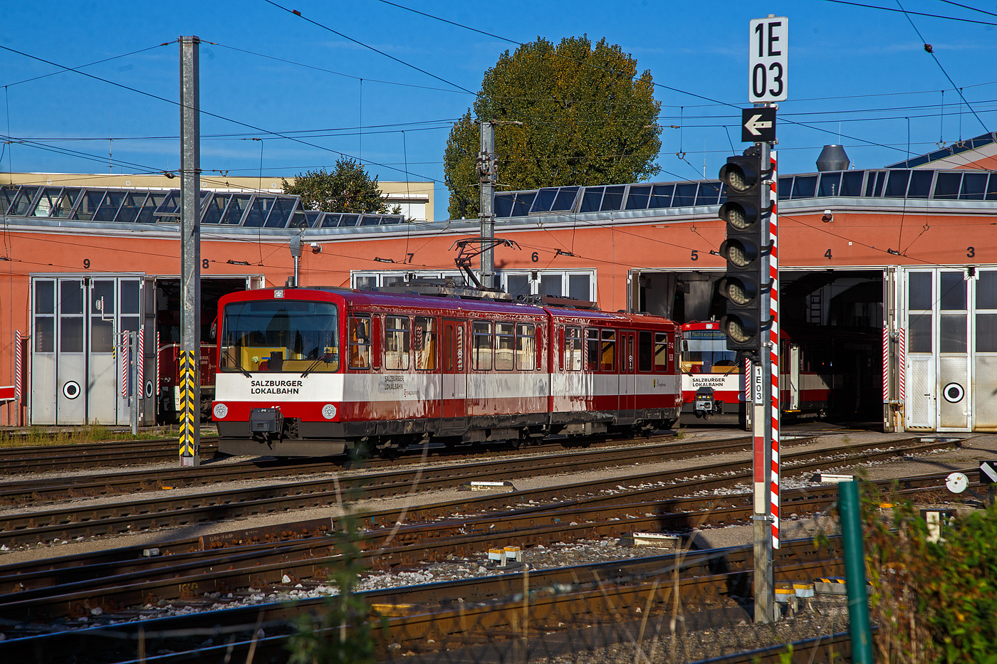 Vor dem Depot der SLB - Salzburger Lokalbahn steht am 13.09.2022 der ET 42 „Bergheim“ .

Der Triebwagen wurde 1983 von der SGP - Simmering-Graz-Pauker AG gebaut, der elektrischer Teil ist von AEG.

Die ab 1983 gebauten ET41–49 sind normalspurige Elektrotriebwagen für den Einsatz auf den mit 1.000 Volt Gleichspannung elektrifizierten Salzburger Lokalbahnstrecken, die heute in das Netz der S-Bahn Salzburg integriert sind. Seit 1983 bestimmen die bis 2002 beschafften Stadtbahnwagen der Typenreihe ET40 das Bild der Salzburger Lokalbahn. Diese waren nach über 30 Jahren die ersten Neufahrzeuge und setzten ein Zeichen für Aufschwung des Nahverkehrs im nördlichen Flachgau und im angrenzenden Innviertel.

Nach Abwägung mehrerer Projekte entschied man sich in Anlehnung an deutschen sechsachsigen Gelenktriebwagen von DUEWAG (U3-Triebwagen Frankfurt am Main) zu beschaffen. So geschah es, dass 1983 der erste Triebwagen einer zunächst fünf Fahrzeuge umfassenden Lieferserie (ET41-ET45) in Salzburg eintraf und sich sofort großer Beliebtheit erfreute.

Die beiden Wagenkästen eines Triebwagens stützen sich stirnseitig
über Schraubenfedern auf die Drehgestelle ab. Diese sind als Triebdrehgestelle ausgeführt, welche je einen Gleichstrommotor aufnehmen. Die Kraftübertragung erfolgt mittels starrer Wellen und Achsgetrieben auf beide Achsen eines Drehgestells. Jede der sechs Achsen ist mittels Maggy-Federn mit dem Drehgestell verbunden. Jede Achse der Triebdrehgestelle wird mit Federspeicherbremsen gebremst. Als primäre Betriebsbremse dient eine elektrische Bremse. Zum Ausgleich von Längskräften zwischen den beiden Fahrzeugteilen bei Bremsvorgängen kommt auf einer Achse des Laufdrehgestells eine Solenoidbremse zur Verwendung. Als Zusatzbremse dienen Magnetschienenbremsen an jedem Drehgestell.

Durch entsprechende elektronische Ansteuerung können die Triebwagen in Vielfachsteuerung eingesetzt werden (maximal vier Triebwagen).
Das Konzept dieser Triebwagen bewährte sich, sodass ab 1988 eine
weitere Serie (ET46-ET50) in Betrieb genommen wurde. Diese Triebwagen wiesen einige Modifikationen auf, die sich jedoch äußerlich kaum bemerkbar machen. Infolge der stetig wachsenden Fahrgastzahlen und um die letzten Altbautriebwagen aus dem Planbetrieb nehmen zu können, wurden 1992 vier Triebwagen (ET51-ET54) und 2001/02 weitere vier (ET55-ET58) ausgeliefert. Diese Triebwagen sind jedoch dreiteilig, mit einem zusätzlichen Niederflur-Mittelteil, ausgeführt.

Mechanischer Teil
Der Wagenkasten ist als selbsttragende Stahlkonstruktion ausgeführt welche sich auf den beiden Motordrehgestellen an den Fahrzeugenden sowie auf Jakobs-Drehgestelle abstützt. Der Fahrmotor ist den Drehgestellen als Längsmotor eingebaut, die Kraftübertragung erfolgt über Winkelgetriebe (Tandemantrieb). Die Primärfederung wurde mittels Megi-Federn ausgeführt, zwischen Drehgestell und Wagenkasten kommen Schraubenfedern in Verbindung mit hydraulischen Stoßdämpfern zum Einsatz.

Elektrischer Teil
Die Fahrmotoren sind als vierpolige, kompensierte Vollspannungs-Reihenschlussmotoren mit 300 kW Nennleistung ausgeführt. Jeder Motor wird von einem eigenen Thyristor-Gleichstromsteller (Chopper) angesteuert. Durch die Verwendung von Gleichstromstellern ist es möglich, Bremsenergie in die Fahrleitung zurück zu speisen. Kann die Bremsenergie nicht aufgenommen werden, wird diese durch Bremswiderstände in Wärme umgewandelt. 

TECHNISCHE DATEN:
Gebaute Anzahl: 9 (ET 41 bis ET 49)
Spurweite:  1.435 mm (Normalspur)
Achsfolge:  B‘2‘B‘
Länge über Puffer: 28.400 mm
Höhe mit Dachaufbauten: 3.720 mm
Breite: 2.674 mm
Fußbodenhöhe über SOK: 984 mm
Leergewicht: 48.400 kg
Drehzapfenabstand: 2 x 10.400 mm
Achsstand im Drehgestell: 1.900 mm
Raddurchmesser:  780 mm (neu) / 710 mm (abgenutzt)
Kleinster zulässiger Bogenradius:  80 m
Höchstgeschwindigkeit: 80 km/h
Sitzplätze: 80
Stehplätze: 100
Leistung Fahrmotoren:  2 x 300 kW 
Übersetzung: 1:5,625
Stundenleistung:  600 kW
Fahrdrahtspannung : 1.000 V DC (=)
Steuerung:  Chopper (Gleichstromsteller)
Stromabnehmer:  Halbscherenstromabnehmer
Zug- und Stoßvorrichtung: Scharfenbergkupplung
Bremsbauart: Elektrodynamische Nutzbremse, Federspeicher-, Magnetschienen- und Solenoidbremse

Die SLB ist eine Tochtergesellschaft der Salzburg AG für Energie, Verkehr und Telekommunikation. Die Bahn nahm 1896 ihren Betrieb auf. Von 1907-1940 betrieb die Salzburger Eisenbahn und Tramway Gesellschaft (SETG) die Bahn, die in der Stadt Salzburg auch ein Straßenbahnnetz betrieb.

Quelle: SLB