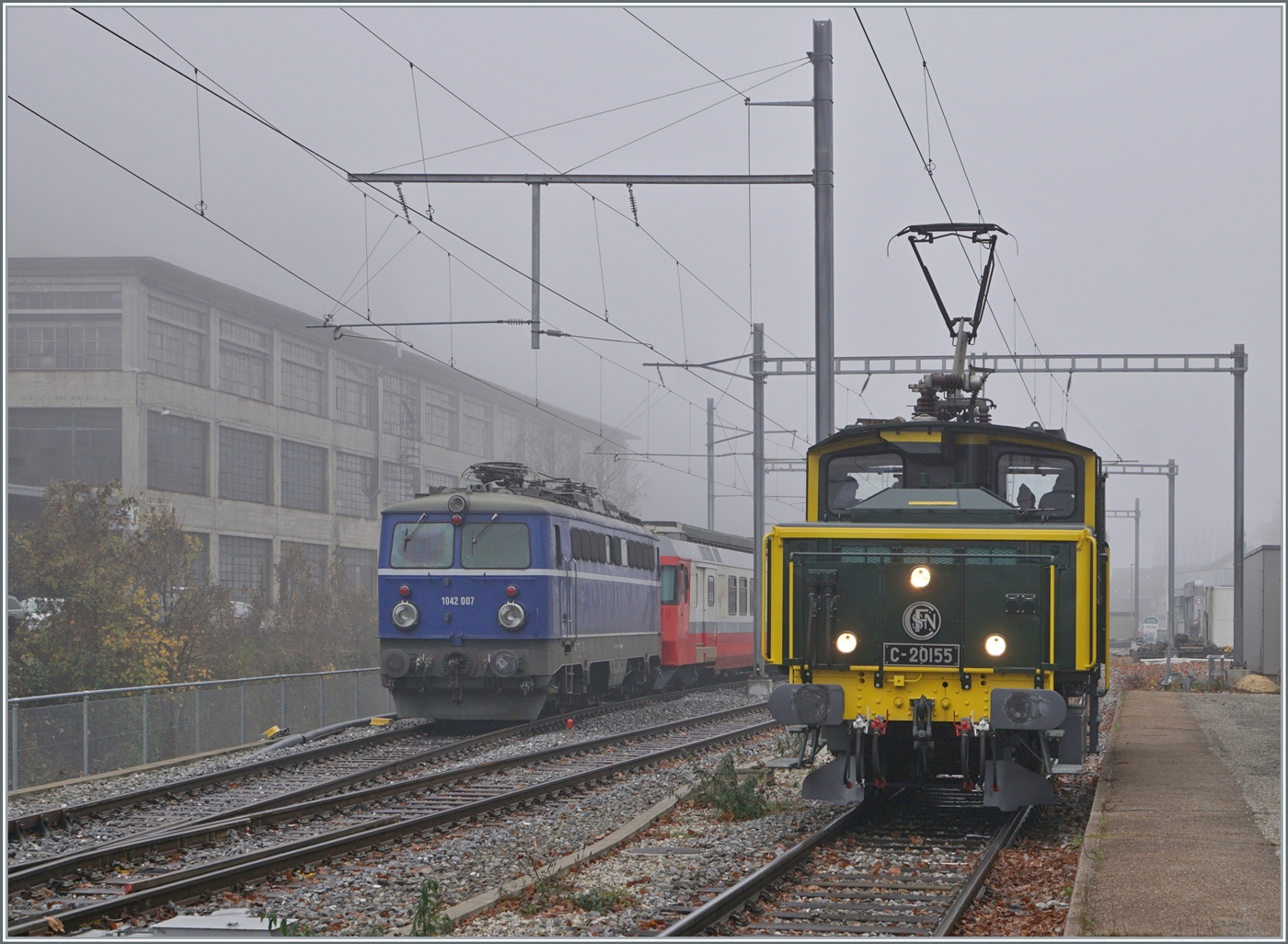 Wenn eine ex SNCF Lok eine ex ÖBB Lok trifft, ist dies ein Bild wert, selbst bei diesem Nebelwetter. Die SNCF C 20155 UIC N° 97 85 1 932-0 (ex SBB Ee 3/3 II 16515, ex SNCF C 20155) führt im Rahmen der offen Tür in Balsthal Führerstandsfahrten Balsthal - Klus - Balsthal aus und erreicht den Bahnhof Klus, während die ex ÖBB 1042 007 (heutige UIC Nummer 91 85 1042 007-1) hier abgestellt ist.

8. November 2025
