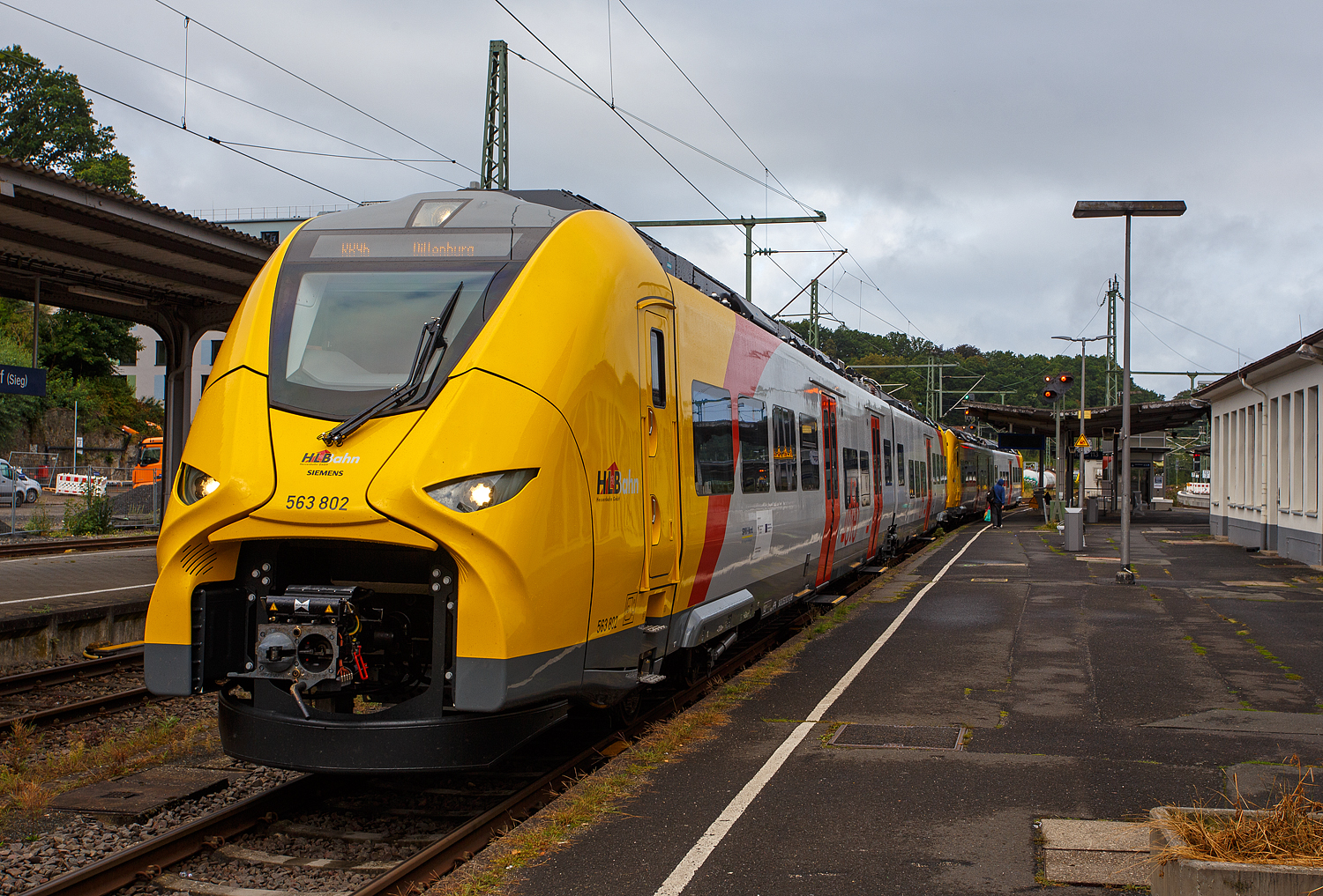 Zurzeit wird auf der Hellertalbahn (KBS 462) emissionsfrei gefahren. Die beiden gekuppelten zweiteilige Hybridtriebzüge (E/Akku) der BR 563 vom Typ SIEMENS Mireo Plus B der HLB (Hessische Landesbahn GmbH) 563 802 / 563 902 und 563 803 / 563 903, stehen am 05 September 2025 im Bahnhof Betzdorf/Sieg, als RB 96 „Hellertalbahn“ nach Dillenburg, zur Abfahrt bereit. Wegen den derzeitigen Sperrungen der Siegstrecke und der Oberwesterwaldbahn sind die SIEMENS Mireo Plus B. So ist der neue Klimaschutz auch auf der Hellertalbahn angekommen.

Laut Aussage von einem Lokführer bewähren sie die neuen Hybridtriebzüge auch auf der Hellertalbahn sehr gut. 

Hier in Betzdorf, sowie auf der Strecke zwischen Haiger und Dillenburg, können die Akkus aufgeladen werden. Selbst eine Wendezeit von 20 Minuten ist für eine Aufladung der Fahrzeuge ausreichend.
