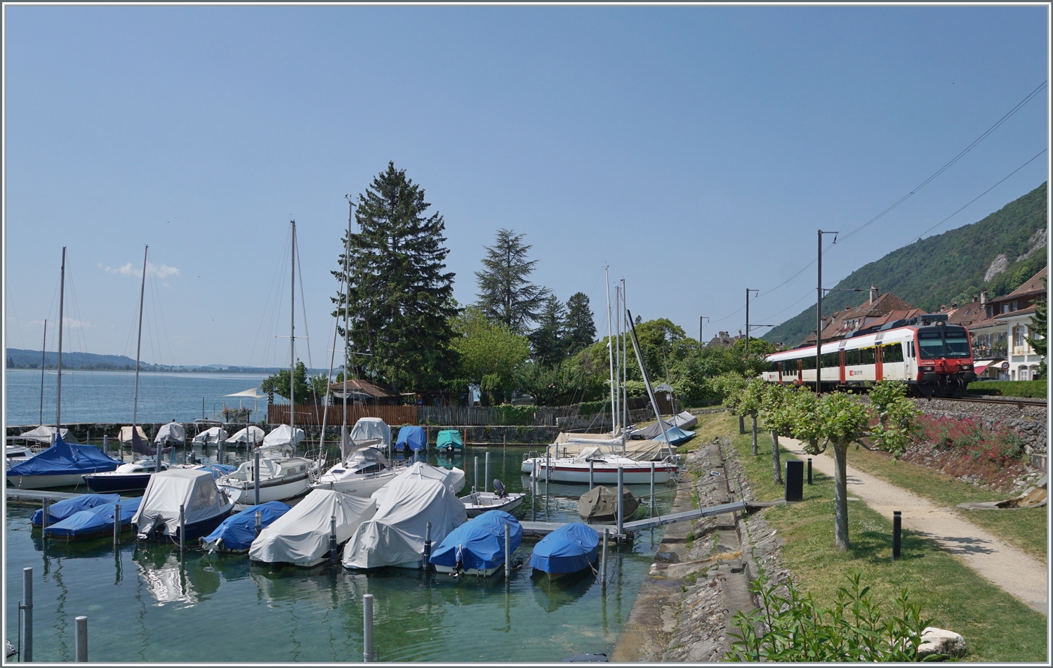 Zwar f�hrt bei Ligerz eine herrlicher (Wander)-Weg direkt nben der Strecke entlang, doch bietet dieser kaum die M�glichkeit zur Wahl des Blickwinkels auf die Z�ge. Anders beim Hafen von Ligerz; auch wenn dann dort mehr Landschaft als Zug das Bild gestaltet. 
Ein SBB Domino ist als Regionalzug von Neuch�tel nach Biel/Biene bei Ligerz unterwegs. 

5. Juni 2023