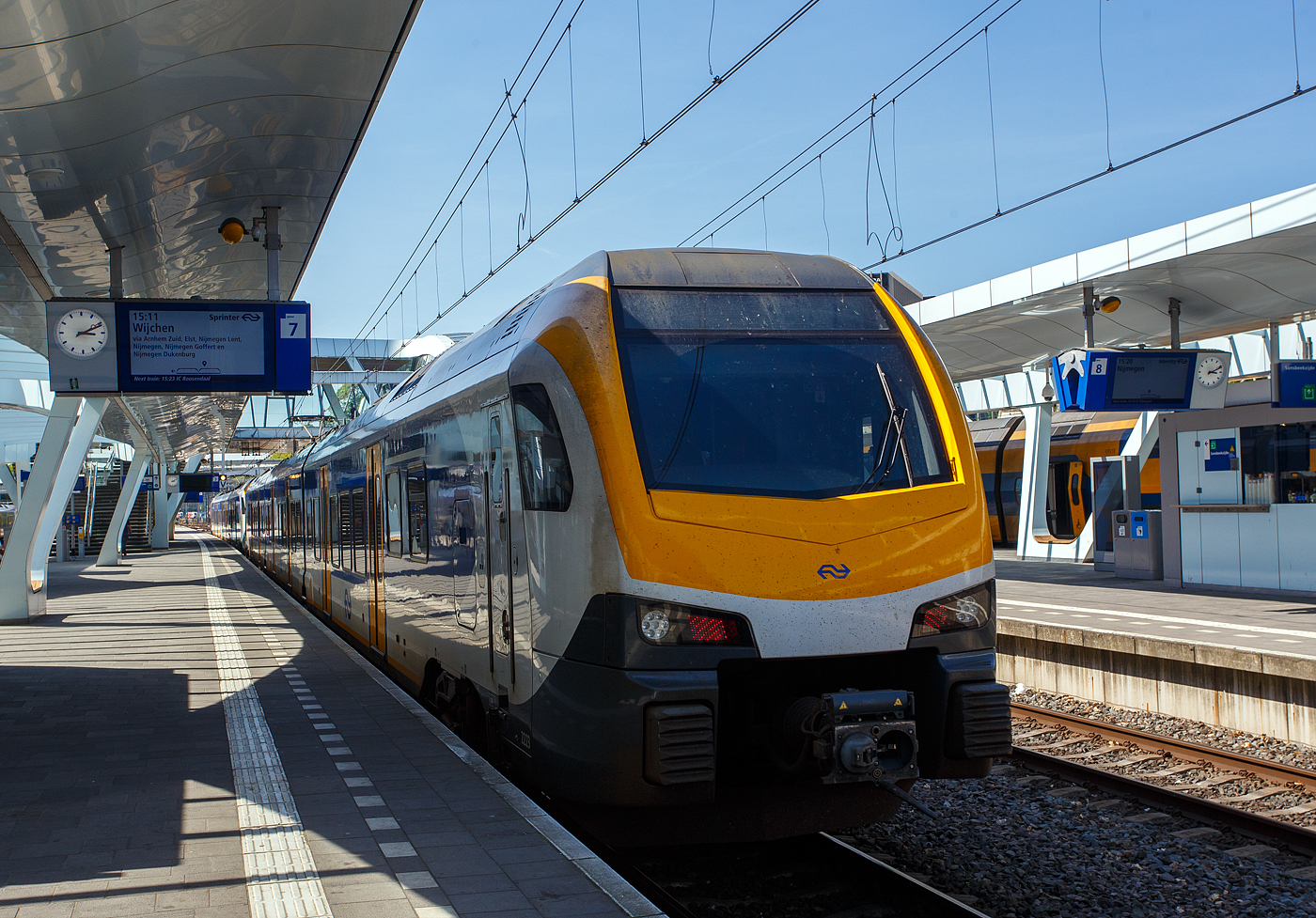 Zwei gekuppelte dreiteilige NS Stadler FLIRT³ (Triebzug 2222 und 2223) der Nederlandse Spoorwegen N.V. (Niederländische Eisenbahnen AG), stehen am 29 April 2025, als Sprinter via Nijmegen (Nimwegen) nach Wijchen, zur Abfahrt im Bahnhof Arnhem Centraal (Arnheim Hbf) bereit. 

Der NS FLIRT ist ein elektrischer Niederflurtriebzug der Niederländischen Eisenbahnen. Der interne Projektname bei NS war Flirt Fast Forward oder FFF, weshalb dieser Spitzname auch verwendet wird. Die Züge wurden vom Schweizer Zughersteller Stadler Rail gebaut und basieren auf der FLIRT3-Plattform des Unternehmens. Die Züge sollen vor allem den Mangel an Ausrüstung und das Wachstum der Fahrgastzahlen auf dem Hauptschienennetz kompensieren.

Der FLIRT (Abkürzung für Flinker Leichter Innovativer Regionaltriebzug) ist vom Stadler GTW abgeleitet, mit dem Hauptunterschied, dass sich die Antriebseinheiten beim FLIRT hinter den Führerständen befinden (statt in einem separaten Triebkopf). Dieser Zugtyp zeichnet sich durch Licht und Platz im Innenraum aus, der durch die Verwendung von Jakobsdrehgestellen in Kombination mit breiten, offenen Wagenkastenübergängen und einem niedrigen Boden entsteht. Der niedrige Boden in Kombination mit einer ausfahrbaren Trittstufe macht den Zug für Menschen mit körperlichen Einschränkungen leichter zugänglich. Das geringe Gewicht des Triebzuges in Kombination mit einem hohen Anfahrdrehmoment macht ihn ideal geeignet für Zugverkehre mit vielen Haltestellen und kurzen Haltezeiten. Die Züge werden daher von der NS als Sprinter eingesetzt.

Die Niederländische Eisenbahngesellschaft NS hat im April 2015 bei Stadler 58 drei- und vierteilige Niederflurtriebzüge des Typs FLIRT bestellt, es sich um 33 dreiteilige und 25 vierteilige Triebzüge. Die Züge werden durch NS Reizigers betrieben, verkehren auf regionalen Strecken und sind für eine Geschwindigkeit von 160 km/h ausgelegt. Der FLIRT der neusten Generation erfüllt die technischen Spezifikationen für Interoperabilität TSI, insbesondere die Standards für Crashanforderungen nach EN 15227. Die luftgefederten Züge überzeugen mit hohem Komfort: 158 bis 214 Fahrgäste (je nach Zuglänge) finden einen einladenden Sitzplatz in klimatisierten, farbenfrohen Innenräumen. Für die Unterbringung von Fahrrädern, Kinderwagen oder Rollstühlen ist gesorgt. Highlight: Der Roll-In der ersten Züge am 13. April 2016 in Maastricht – nur ein Jahr nach der Bestellung – unterstreicht die hohe Leistungsfähigkeit von Stadler.

Da die SNG - Sprinter Nieuwe Generatie, die CAF Civity Triebzüge erst 2018 in Betrieb gehen würden, aber bereits ab Januar 2017, aufgrund der Ausweitung des ÖPNV-Studentenausweises, die NS mit einem starken Anstieg der Fahrgastzahlen konfrontiert war, benötigte die NS schnell zusätzliche Triebzüge. So erteilte die NS gleichzeitig beim Schweizer Hersteller Stadler Rail eine Eilbestellung über 58 FLIRT-Züge, die ab 2016 ausgeliefert wurden. Der Vertrag für diesen Auftrag wurde am 23. April 2015 unterzeichnet.

Der Aluminiumaufbau der Triebzüge wurde im Stadler-Werk in Szolnok (Ungarn) gebaut und anschließend zur Fertigstellung in das polnische Stadler-Werk in Siedlce gebracht. Die ersten drei Züge wurden am 29. März 2016 für die erforderlichen Umwelt- und Transportinspektions- und Zulassungsfahrten in den Niederlanden nach Maastricht überführt. Die Auslieferung der insgesamt 58 bestellten FLIRTs an die NS wurde am 4. September 2017 abgeschlossen.

Technik:
Die FLIRT-Triebzüge bestehen aus drei oder vier Wagen, die an den Wagenübergängen auf Jakobsdrehgestellen montiert sind. Durch den Einsatz eines Jacobs-Drehgestells ist der Wagenkastenübergang kurz und breit, was für ein hohes Maß an Transparenz sorgt. Daher verfügen diese Züge über breite Wagenkastenübergänge und einen Niederflurbereich. Die Triebzüge haben eine Länge von 63,2 m als dreiteilige Einheit bzw. 80,7 m als vierteilige Einheit, eine Breite von 2,820 m und eine Höhe von 4,120 m. Die Wagenkästen sind kürzer als üblich. Niederflurbereich beträgt über 90 %, die Bodenhöhe im Niederflurbereich beträgt 780 mm. Die Züge haben je Längsseite 6 (dreiteilig) bzw. 8 (vierteilig) 1.300 mm breite Doppeltüren (2 Einstiegstüren pro Wagenkastenseite). Die Wagenkästen sind in Aluminium-Leichtbauweise gemäß den neuesten Standards in Bezug auf Kollisionssicherheit (EN 15227) und Festigkeit (EN 12663). Die Züge laufen auf luftgefederte Trieb- und Laufdrehgestelle, die Laufdrehgestelle sind als Jacobs-Drehgestelle ausgeführt. Durch die Vielfachsteuerung sind bis zu drei Fahrzeuge kuppelbar. Die Sets verfügen über ATB-EG und sind für die Installation von ERTMS vorbereitet. Die Züge haben eine Höchstgeschwindigkeit von 160 km/h.

Die dreiteiligen Zuggarnituren verfügen über 32 Sitzplätze der 1. Klasse und 114 Sitzplätze der 2. Klasse, zudem 12 Klappsitze. Die dreiteiligen Triebzüge tragen die Nummern 2201 – 2233. Die vierteiligen Züge verfügen über 32 Plätze der ersten Klasse und 170 Plätze der zweiten Klasse, zudem 12 Klappsitze. Die vierteiligen Triebzüge tragen die Nummern 2501 – 2525.

Interieur:
Im Inneren gibt es keine Quer-/Stirnwände oder Zwischentüren, lediglich die erste und zweite Klasse sind durch Glastüren und Zwischenwände getrennt. Reisende haben Zugang zu USB-Ladestationen zum Aufladen mobiler Geräte, Steckdosen und einem kostenlosen WLAN-Netzwerk. Darüber hinaus sind die Züge mit Niederflur, Schiebetritten und einer rollstuhlgerechten Toilette ausgestattet, um Menschen mit körperlicher Behinderung das Reisen zu erleichtern. Diese Toilette verfügt über eine klappbare Ablage zum Windelwechseln. Die Züge verfügen über Abteile erster und zweiter Klasse, einen Mehrzweckbereich mit Abstellraum für Fahrräder und Kinderwagen. Der Innenraum ist mit Werken vom niederländischen Maler Piet Mondrians gestaltet. Die Innenreinrichtung (Sitze) sind vom tschechischen Unternehmen BORCAD cz a.s. Wie bei der NS üblich, ist die Innenreinrichtung rot für die 1. Klasse und blau für die 2. Klasse. Die Führerstände sind unter anderem mit einer auf die Strecke gerichteten Kamera ausgestattet. 

Außenfarbwechsel:
Die Stadler FLIRT wurden alle mit einer Front in dunkelblau/weiß ausgeliefert. Während diese Färbung den europäischen Standards entsprach, machte die Kombination aus der dunklen Farbe und dem großen Fenster es schwierig, den Zug von Bahnübergängen aus zu sehen. Der Mangel an Sichtbarkeit war die Hauptursache für eine Kollision zwischen einem Traktor und einem SNG an einem unbesicherten Bahnübergang im Mai 2020, bei dem der Lokführer getötet wurde. Die NS beschloss, die Farbe der Fronten von Triebzügen in Gelb zu ändern, die ersten Änderungen wurden bei den SNG-Triebzügen vorgenommen, wo teils noch die Restlieferung CAF anstand. So war diese bei den SNG bis August 2022 nahezu abgeschlossen. So wurde 2023 eine ähnliche Änderung an den FLIRT-Züge vorgenommen. Im Februar 2023 wurde die Garnitur 2206 mit gelben Fronten in Betrieb genommen. Ab 2024 werden alle 3er-Sets mit einer gelben Front ausgestattet.

TECHNISCHE DATEN:
Gebaute Anzahl: 58 (davon 33 dreiteilige ET und 25 vierteilige ET)
Nummerierung: 2201-2233 (dreiteilige ET) / 2501-2525 (vierteilige ET)
Hersteller: Stadler Rail
Baujahre: 2016 und 2017
Spurweite: 	1.435 mm (Normalspur)
Achsfolge: Bo'2'2'Bo' (8 Achsen) / Bo'2'2'2'Bo' (10 Achsen)
Länge über Kupplung: 63.200 mm / 80.700 mm
Fahrzeugbreite: 2.820 mm
Fahrzeughöhe: 4.120 mm
Achsabstand im Triebdrehgestell: 2.500 mm
Achsabstand im Laufdrehgestell: 2.700 mm
Treibraddurchmesser: 920 mm (neu)
Laufraddurchmesser: 760 mm (neu)
Leergewicht: 
Höchstgeschwindigkeit: 160 km/h (Planmäßig 140 km/h)
Sitzplätze: 32 in 1. Klasse, 114 bzw. 170 der 2. Klasse, sowie 12 Klappsitze
Bodenhöhe: Niederflur 780 mm (90%), Hochflur 1.180 mm
Türbreite: 1.300 mm
Türen je Längsseite: 6 / 8
Leistung am Rad: 3.000 kW
Anfahrzugkraft: 200 kN
Anzahl der Traktionsmotoren: 4 
Übersetzung: 1 : 5,347
Stromsystem: 1,5 kV Gleichstrom
Kupplung: Scharfenberg
