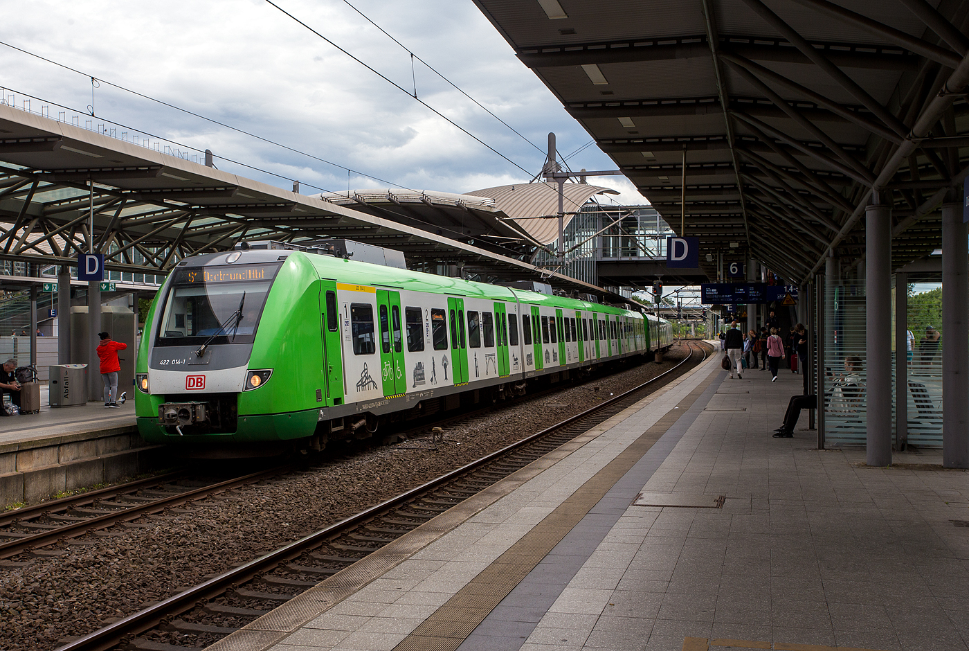 Zwei gekuppelte vierteilige elektrische Triebzüge der Baureihe 422 / 432 der S-Bahn Rhein-Ruhr (Betreiber DB Regio NRW), der S-Bahn Linie S1 (Solingen – Duisburg – Essen - Dortmund Hbf), haben am 16 Mai 2024 den Bahnhof Düsseldorf Flughafen erreicht.

Vorne der ET 422 014-1 / 432 014/ 432 514/ 422 514-0 und dahinter der ET 422 034-9 / 432 034 / 432 534 / 422 534-8. Beide Triebzüge hier gehören der DB Regio NRW, nicht wie andere dem ZV VRR Eigenbetrieb Fahrzeuge und Infrastruktur. Der vordere 422 014-1 wurde 2008 von er Bombardier Transportation GmbH in Hennigsdorf gebaut, der hintere 422 034-9 wurde 2008 von ALSTOM Transport Deutschland GmbH (vormals LHB) in Salzgitter-Watenstedt gebaut.

Die DB-Baureihe 422/432 ist ein aus der Baureihe 423 weiterentwickelter vierteiliger elektrischer Triebzug für den S-Bahn-Verkehr. Als Baureihe 422 werden dabei die beiden angetriebenen Endwagen bezeichnet, während die ebenfalls angetriebenen Mittelwagen als Baureihe 432 klassifiziert werden. Diese Baureihe/-serie mit 84 Triebzügen gibt es nur bei der S-Bahn Rhein-Ruhr im Gebiet des Verkehrsverbunds Rhein-Ruhr (VRR).  In anderen deutschen S-Bahn-Netzen wird stattdessen die Nachfolge-Baureihe 430/ 431eingesetzt.

Diese Triebzüge der BR 422/432 ist sind eine Weiterentwicklung der BR 423, sie sind vierteilige elektrische Triebzüge für den S-Bahn-Verkehr, alle Teile sind angetrieben, wobei die beiden Steuerwagen als BR 422 und die Mittelwagen als BR 432 geführt werden. Diese Baureihe/-serie mit 84 Triebzügen, die zwischen 2007 bis 2010  gebaut wurde, gibt es nur bei der S-Bahn Rhein-Ruhr im Gebiet des Verkehrsverbunds Rhein-Ruhr (VRR). In anderen deutschen S-Bahn-Netzen wird stattdessen die Nachfolge-Baureihe 430/ 431eingesetzt. Die Triebzüge wurden von einem Konsortium gebildet von Bombardier und Alstom in Aluminium- gefertigt. 

Technik: 
Technisch ähnelt die Baureihe 422 stark der Vorgängerbaureihe 423. Die Fahrzeuge wurden in Leichtbauweise aus Aluminium und Verbundwerkstoffen gefertigt. Die Triebzüge haben konventionelle Enddrehgestelle und Jakobs-Drehgestelle zwischen den einzelnen Wagen (End- und Mittelwagen). Das Mittlere Drehgestell, zwischen den beiden Mittelwagen der BR 432, ist als reines Jakobs-Laufdrehgestell ausgeführt. Die beiden Jakobs-Drehgestelle zwischen jeweils einem End- und einem Mittelwagen sind jeweils als Triebdrehgestell ausgeführt.

Äußerlich besteht die wesentliche Änderung aus dem neuen Fahrzeugkopf mit Knautschzone gemäß DIN EN 15227 zum verbesserten Schutz der Fahrgäste und des Triebfahrzeugführers bei Kollisionen, die zu einer gegenüber den BR 420 und 423 um insgesamt zwei Meter länger Gesamtlänge führt. Hinter den Verkleidungen an den Fahrzeugenden befinden sich Energieverzehrmodule mit integriertem Aufkletterschutz.

Nach den Praxiserfahrungen mit in bestimmten Situationen, insbesondere im Herbst, ungenügender Bremsleistung wurde das bei der Baureihe 423 noch ungebremste Laufdrehgestell mit Radbremsscheiben und einer zusätzlichen Magnetschienenbremse ausgestattet.

Am Standort Hennigsdorf führte Konsortialführer Bombardier die Endmontage von 26 Zügen durch, 58 Züge montierte Alstom LHB in Salzgitter. Die Wagenkästen und Kopfdrehgestelle wurden bei Alstom in Salzgitter gebaut. Bombardier fertigte die elektrische Ausrüstung im Werk Mannheim und die Jakobs-Drehgestelle im Werk Dreis-Tiefenbach (bei Siegen) der ehemaligen Waggon Union (ex SEAG Siegener Eisenbahnbedarf A.G.  Waggonbau Dreis-Tiefenbach).

TECHNISCHE DATEN der BR422/432:
Spurweite: 1.435 mm (Normalspur)
Achsformel:  Bo'(Bo') (2') (Bo')Bo'  (Jakobsdrehgestelle in Klammern)
Länge über Kupplung:  69.430 mm
Höhe:  4.330 mm
Breite:  3.020 mm
Drehzapfenabstände:  15.140 mm / 2 x  15.460 mm / 15.140 mm
Achsabstand im Drehgestell:  2.200 mm (End-DG) ; 2.700 mm (Jakobs-DG)
Treib- und Laufraddurchmesser: 850 mm neu / 780 mm abgenutzt
Kleinster bef. Gleisbogen: R 100 m
Leergewicht: 112 t
Max. Achslast: 18,0 t
Höchstgeschwindigkeit: 140 km/h
Dauerleistung: max. 2.350 kW möglich
Anfahrzugkraft: 145 kN
Beschleunigung: 1,0 m/s²
Bremsverzögerung_ 0,9 m/s²
Stromsystem:  15 kV 16,7 Hz ~
Fahrmotoren:  8x Drehstrom-asynchron (wassergekühlt)  á 200 kW (max. 294 kW)
Kupplungstyp: Scharfenbergkupplung Typ 10
Sitzplätze: 192 (davon 16 in der 1. Klasse)
Stehplätze: 352
Türen pro Fahrzeugseite: 12 (Öffnungsweite jeweils 1.300 mm)
Fußbodenhöhe/Einstig: 1.025 mm / 995 mm
Toilette: keine
Bremsen: Elektrisch, Druckluft-Scheibenbremse, Magnetschienenbremse

Bemerkung: Seit 2017 werden die ET´s modernisiert, der ET 422 010 war der erste.