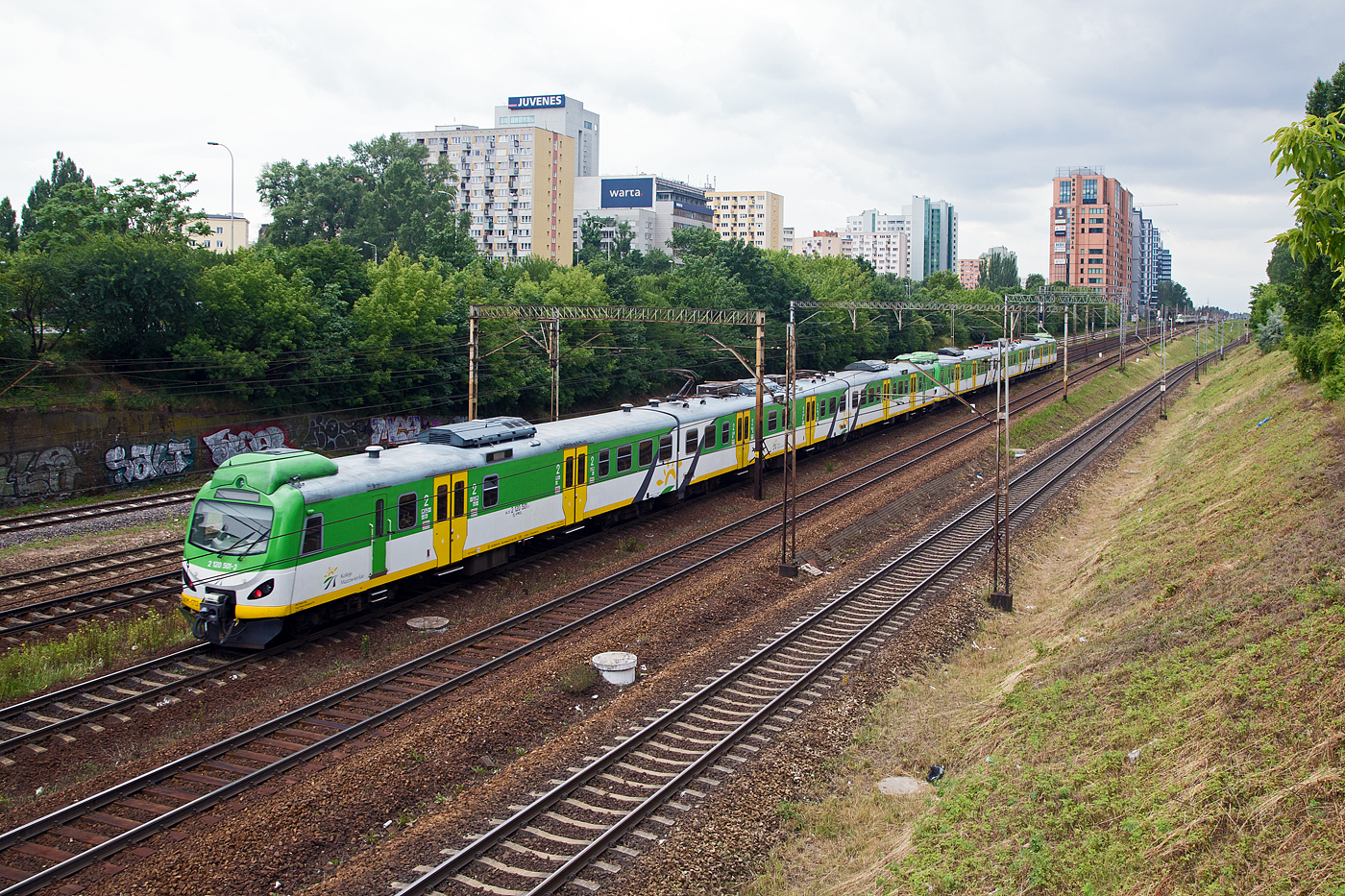 Zweigekuppelte dreiteilige elektrische Triebzüge, modernisierte Pafawag 5B/6B der Koleje Mazowieckie - KMKOL (Masowische Eisenbahnen), haben am 26 Juni 2017 den Bahnhof Warszawa Ochota (in Warschau) verlassen. Hier am Schluss der EN57AKM-1713 (2 120 501-3).

Die Koleje Mazowieckie (KM) führt  seit 2005 den Regionalverkehr in der Woiwodschaft Masowien auf dem Gleisnetz der PKP PLK durchführt. 

Im Jahr 2008 beschloss die KM die Modernisierungen von den ersten zehn EN57 (Pafawag 5B/6B) in Auftrag zu geben, bei denen die von EMIT aus Żychlin entwickelten Wechselstrommotoren LK450X6 installiert wurden. Diese Motoren wurden in alten Gehäusen eingebaut, sodass kein Austausch der Achsantriebe erforderlich war. Der neue Motor hat eine Leistung von 250 kW, die gesamte Einheit hat eine Leistung von 1 MW, was die Traktionsparameter der Fahrzeuge deutlich verbesserte, die Anfahrbeschleunigung (bis 40 km/h) wurde auf fast 1 m/s² erhöht , und die Höchstgeschwindigkeit wurde auf 120 km/h erhöht. Die Modernisierungen wurden in den ZNTK-Werken „Mińsk Mazowiecki“ (6 Einheiten im Jahr 2009–2010) und Newag Nowy Sącz (4 Einheiten im Jahr 2009) durchgeführt, die modernisierten Einheiten erhielten die Kennzeichnung EN57AKM, später folgten 66 weitere Einheiten. 

Später wurden aber auch andere Einheiten in die Version EN57AL modernisiert, die sich etwas auch äußerlich von den EN57AKM unterscheiden.
