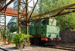 Etwas für Fotos ungünstig stehend, die Verschub-Dampflokomotive Emil Mayrisch 5, eine Krupp Bergbau, am 05 Juni 2011 im LWL-Industriemuseum Henrichshütte in Hattingen (bis 2007 WIM - Westfälisches Industriemuseum).

Die Krupp Typ Bergbau wurde 1953 Lokomotiv- und Waggonbaufabrik Krupp (LOWA) der Friedrich Krupp AG in Essen unter der Fabriknummer 3077 gebaut und als Lok IX an die Gewerkschaft Auguste-Victoria in Marl-Sinsen. Bis zu seiner Schließung 2015 war das Bergwerk das drittletzte aktive Steinkohlebergwerk Deutschlands sowie das zweitletzte im Ruhrgebiet.

1968 ging die Lok aber an die Grube Anna in Alsdorf des EBV - Eschweiler Bergwerks-Verein AG und wurde 1983 als ANNA Nr. 7 geführt, von 1983 bis zur Ausmusterung 1992 wurde die Lok  Emil Mayrisch 5  geführt. Im Jahr 1993 ging sie an das Bergbaumuseum Wurmrevier e. V. in Alsdorf und ging aber ende der 1990er an das damalige als geführt WIM - Westfälisches Industriemuseum, Standort Henrichshütte in Hattingen. 

Beschreibung des Typs  Bergbau  der Lokomotivfabrik Krupp (Essen):
Die normalspurige, vierachsige Tenderlokomotive war Teil des Nachkriegs-Typenprogramm Lokomotivfabrik in Essen und wurde sowohl in einer Naßdampf- als auch in einer Heißdampfversion geliefert. Zwischen 1948 und 1962 entstanden 30 Lokomotiven dieses Typs in der Lokomotivfabrik Krupp AG. Die  Bergbau  war nicht nur die leistungsstärkste, sondern mit Abstand mit 80 t die schwerste Maschine unter den Nachkriegsbauarten. 

Entstehungsgeschichte:
Während des Zweiten Weltkrieges erhielt Krupp den Auftrag zur Entwicklung einer schweren Dh2t-Lokomotivbauart für die Reichswerke Hermann Göring in Salzgitter, nach 1945 ging diese endgültig in der Salzgitter AG auf, die sich bis Ende der 1980er Jahre im Besitz der Bundesrepublik Deutschland befand. Nach Abschluss der Konstruktionsarbeiten wurde der Bau der 13 bestellten Maschinen kriegsbedingt zur Firma Werkspoor in Utrecht verlagert. Die Niederlande war ja von den deutschen Truppen besetzten worden. Bis zum Kriegsende konnte allerdings keine Lok fertig gestellt werden. Die angearbeiteten Baugruppen wurden kurz vor dem Abzug der Besatzungstruppen noch nach Essen überführt, wo sie nach Komplettierung und Endmontage ab 1948 zur ersten Serie der Bergbau wurden. 

Bauart:
Die Krupp Bergbau war für den schweren Übergabe- und Verschubdienst von Industrie- und Werksbahnen konzipiert. Entsprechend diesem Einsatzzweck war sie besonders robust und kräftig ausgeführt. Dank ihres vergleichsweise hohen Kesseldrucks, der großen Zylinder und des günstigen Übersetzungsverhältnisses war die mit vollen Vorräten 80 t schwere und rund 1.000 PSi starke Lok nicht nur die leistungsfähigste Type des Krupp-Industrielokprogramms, sondern die schwerste und stärkste vierachsige deutsche Tenderlok überhaupt. Im unteren Geschwindigkeitsbereich übertraf ihre Zugkraft sogar die der sechsachsigen Schlepptenderlok der Baureihe 50. Die zulässige Höchstgeschwindigkeit betrug 50 km/h. Zwecks Erzielung günstiger Kurvenlaufeigenschaften lagen nur der erste und dritte Radsatz fest im Rahmen, der zweite und vierte Radsatz waren jeweils um 15 mm seitenverschiebbar.

Die Type wurden in mehreren Baulosen gefertigt, die sich teilweise äußerlich unterscheiden lassen; die ersten beiden Serien besaßen viereckige Führerhausstirnfenster nach Art der Kriegslokomotiven, kantige Führerhausdächer und zwei sichtbare Kesselaufbauten (Dampfdom mit zwei Sandkästen unter gemeinsamer Verkleidung, separater Speisedom); später gebaute Loks hatten ovale Stirnfenster, abgerundete Führerhausdächer sowie eine durchgehende Verkleidung von Speisedom, Dampfdom und nur noch einem Sandkasten. Da sich der Wasservorrat von zunächst 8 m³ bei den auf der Hafenbahn der HOAG (Walsum – Oberhausen) eingesetzten Loks als etwas knapp erwiesen hatte, wurde ein Teil der später gebauten Maschinen mit vergrößerten hinteren Vorratsbehältern ausgerüstet. Der hintere Überhang wuchs dadurch um 150 mm, der Wasservorrat nahm auf 10 m³ zu. Einige Maschinen wurden ab Werk mit einem Mischvorwärmer ausgerüstet.

TECHNISCHE DATEN:
Gebaute Anzahl: 30
Baujahre: 1948 bis 1962
Bauart: D n2t oder D h2t
Spurweite: 1.435 mm (Normalspur)
Länge über Puffer: 11.100–11.250 mm (je nach Bauserie)
Höhe: 4.150 mm
Breite: 3.130 mm
Gesamtachsstand: 4.500 mm (3 x 1.500 mm)
Treibraddurchmesser: 1.200 mm (neu)
Dienstgewicht: 80 t
Höchstgeschwindigkeit: 50 km/h (vorwärts / rückwärts), diese zuletzt 25 km/h
Indizierte Leistung: 735 kW / 1.000 PS
Anfahrzugkraft: 223 kN
Kesselüberdruck: 15 bar
Zylinder: 2 (Ø 630 mm x 600 mm Hub)
Steuerungsart: Heusinger auβen
Rostfläche: 2,46 m² 
Überhitzerfläche: 42 m² 
Verdampfungsheizfläche: 118 m²
Wasservorrat: 10,0 m³
Kohlevorrat: 3 t
Kleinster bef. Halbmesser: 100 m
Bremse: Knorr 
