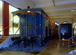 Versailles auf Rädern, der Salon- und Terrassenwagen des bayerische Märchenkönigs Ludwig II, im DB Museum in Nürnberg, hier am 01 November 2008.

Der bayerische Märchenkönig Ludwig II. ist vor allem für seine prachtvollen Schlossbauten bekannt. Weniger bekannt ist seine Rolle als Auftraggeber von nicht minder prachtvollen Bahnfahrzeugen. Die beiden prunkvoll gestalteten Eisenbahnwagen sind die einzigen Fahrzeuge, die vom einstigen königlich-bayerischen Hofzug (ein Schloss auf Rädern) erhalten geblieben sind.

Ludwig II. hatte 1864 mit der Regentschaft auch den hofeigenen Zug vom Vater Maximilian II. übernommen. In den nächsten Jahren ließ er ihn erweitern und zu einem Prunkzug im Stil des französischen Barock umbauen. Bereits kurz nach seinem Amtsantritt gab Ludwig den Terrassenwagen in Auftrag, der 1865 ausgeliefert wurde. In den Jahren 1868 bis 1870 ließ er den Salonwagen, der 1860 von der Eisengießerei und Maschinenfabrik Klett & Comp. (in Nürnberg, eines der beiden Vorgängerunternehmen der MAN) für Maximilian gebaut worden war, aufwendig umgestalten. Für den Umbau engagierte Ludwig II. den Bühnenmaler Franz von Seitz, Professor an der Münchener Kunstakademie und artistischer Direktor der Hofbühne. Auf Anweisung des Königs orientierte sich der Künstler am Schloss Versailles, dem Palast von Frankreichs „Sonnenkönig“ Ludwig XIV. Der Volksmund gab dem Ludwigswagen später den entsprechenden Beinamen  Versailles auf Rädern .

Über die Fahrten Ludwigs mit dem Hofzug ist wenig bekannt. Belegt ist, dass er mit ihm 1866 seine berühmte Frankenreise unternahm. Damals war der Salonwagen allerdings noch in seinem alten Bauzustand. In späteren Jahren reiste Ludwig meist inkognito. Da sein Hofzug hierfür zu auffällig war, benutzte er dabei einen  Inkognito-Zug , der aus einfachen Reisezugwagen bestand.

Der Hofzug Ludwigs II. wurde nach seinem Tod noch bis 1918 einsatzfähig gehalten. Offenbar wurde er weiterhin eingesetzt, denn zwischen 1891 und 1893 wurden sämtliche Wagen modernisiert. Der Salonwagen erhielt in dieser Zeit moderne Drehgestelle und Westinghouse-Druckluftbremsen.

Nach dem Ende der Monarchie kamen der Salonwagen und der Terrassenwagen in das Verkehrsmuseum Nürnberg. Bei einem Bombeneinschlag gegen Ende des Zweiten Weltkrieges wurde das Museumsgebäude beschädigt. Plünderer nahmen danach alles mit, was irgendwie transportabel war, unter anderem sämtliche Bodenbeläge, die seidenen Wandverkleidungen, die Marmorplatten der Tische und die Eckgemälde an der Decke des Salonwagens. Bis zur Wiedereröffnung des Verkehrsmuseums 1953 ließ man die Gemälde neu herstellen, Verzierungen ausbessern und neu vergolden. Spiegel, Marmorplatten und Putten wurden ergänzt und sämtliche Bodenbeläge und Stoffbezüge erneuert.
